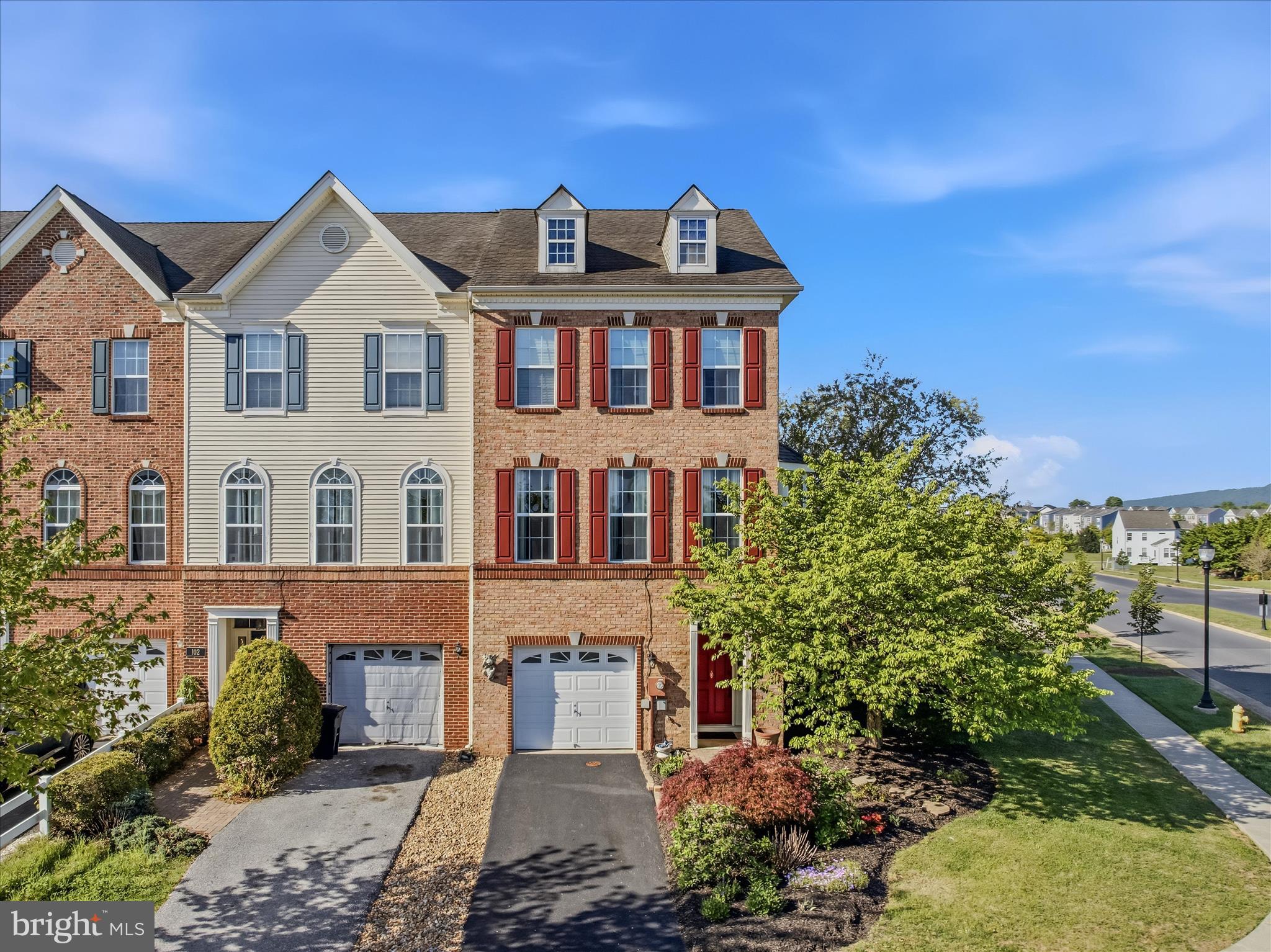 This beautifully appointed brick-front townhome offers three thoughtfully designed levels, featuring nine-foot-high ceilings, decorative moldings and finishes you'll typically find only in the finest of homes.  The lower level welcomes you with a foyer with hardwood stairs that lead to the second floor, or follow the hallway to a cozy family room, complete with rich hardwood floors and built-in bookcases that add warmth and character to the space. Beyond is a custom patio with that features a built-in bench and privacy partition—ideal for entertaining or unwinding in your own secluded space. Upstairs, the main level continues the hardwood flooring throughout, creating a seamless and elegant flow. The kitchen is both stylish and functional, featuring beautiful hardwood cabinetry, stainless steel appliances, granite countertops, and ceramic tiled floors. Just off the kitchen, the breakfast nook boasts a charming bay window seat and direct access to the spacious deck—perfect for morning coffee. The home features upgraded lighting throughout. The dining room is enhanced by a decorative light fixture, while the living room impresses with a wall of windows that flood the space with natural light, complemented by a sophisticated tray ceiling. The upper level offers three generously sized bedrooms with plush carpeting and vaulted ceilings, along with a hall bath featuring an extended vanity and a tub/shower combination. The primary suite is a true retreat, showcasing hardwood flooring, vaulted ceilings, and a large walk-in closet. Its private ensuite bath includes a double bowl vanity, a relaxing soaking tub, and a separate walk-in shower. Outdoor living is equally inviting, with a large deck off the breakfast nook and the custom patio below, not to mention the community pool, clubhouse, tennis and pickle ball courts and tot lots. Updates include a new upper floor HVAC installed in 2023. In Dec 2025, the new lower floor HVAC was installed along with a new water softener, dishwasher, and disposal. This home has everything you're looking for and more. Schedule your showing today!