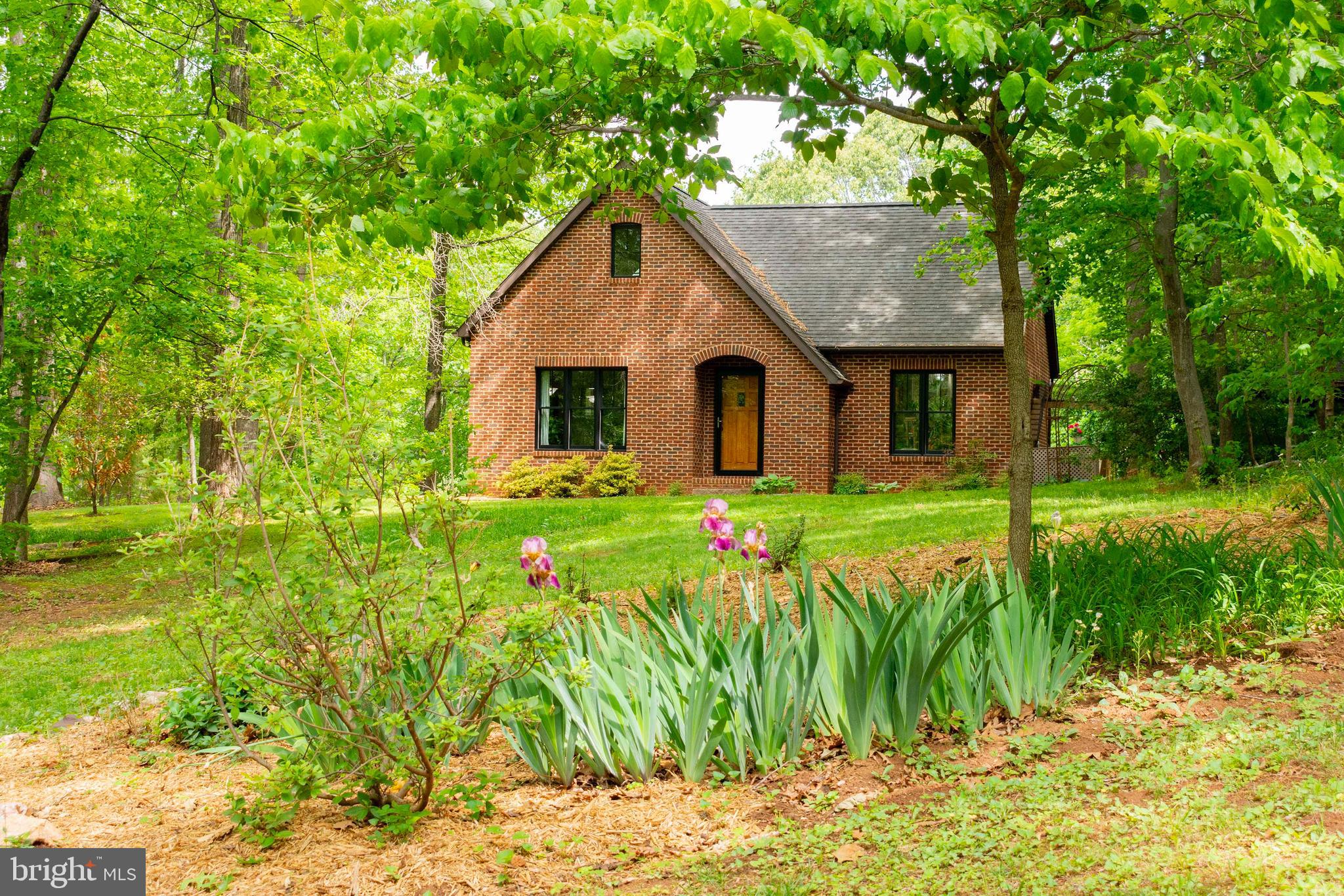 Nestled in a serene rural setting, this exquisite Cape Cod residence offers a harmonious blend of luxury and comfort, perfect for those seeking an exclusive lifestyle. Built in 1999, the home showcases timeless brick construction and a thoughtfully designed layout that invites warmth and relaxation. Step inside to discover a spacious interior adorned with wonderful tile floors that flows seamlessly throughout. The combination dining and living area is perfect for entertaining, featuring a cozy gas fireplace that serves as a stunning focal point, creating an inviting atmosphere for gatherings or quiet evenings at home. Large casement and double-pane windows bathe the space in natural light while offering picturesque views of the surrounding landscape. The gourmet kitchen is a chef's dream, equipped with high-end stainless steel appliances, including a built-in microwave, range, and dishwasher. The sleek design is complemented by ample counter space and a convenient layout, making meal preparation a delight. Adjacent to the kitchen, the screened porch and expansive deck provide an idyllic setting for al fresco dining or simply enjoying the tranquil sounds of nature. This residence boasts a generous master suite, complete with an en-suite bathroom featuring both a full and half bath for added convenience. The home also includes a versatile basement with a walkout level, perfect for a workshop or additional storage, ensuring that every inch of this property is utilized to its fullest potential. Outside, the property spans an impressive 6 acres, offering a private oasis that backs to lush trees and a gentle stream. The extensive hardscape and beautifully landscaped grounds create a picturesque backdrop for outdoor activities or peaceful reflection. Enjoy the serenity of rural living while being just a short drive from local amenities. Parking is a breeze with an attached garage, off-street spaces, and additional parking lot options, ensuring ample room for guests. The garage features inside access and additional storage, enhancing the functionality of this remarkable home. With scenic vistas of mountains and woods, this property is a true retreat, providing a perfect balance of luxury and nature. Experience the tranquility and elegance of this exceptional residence, where every detail has been thoughtfully curated to create a warm and inviting atmosphere. Embrace the lifestyle you deserve in this stunning home, where comfort meets sophistication in a breathtaking setting. FIRE FLY  is the internet provider at the property.  NEW Anderson windows 2024; new heat pump 2020; new water heater 2018, new pressure tank 2025...well maintained home!  HEALTH DEPT HAS A THREE BEDROOM PERK CERTIFICATE ON FILE Wooded oasis for the retiree, commuter or remote worker (reliable high speed internet service by Firefly.)  Optimally located minutes from the Towns of Culpeper and Madison, less than an hour from Charlottesville and Fredericksburg and less than an hour and a half from Dulles Airport and other Northern Virginia/D.C.destinations this custom home features an upgraded kitchen. Everything from dishwasher to built-in oven and microwave within arm’s reach. Bright glass front wall cabinets. Base cabinets with deep quiet close drawers for full access to cookware and those occasionally used small appliances. Casual seating at the quartz countertop flows to the dining and living areas. The glass front cast iron Jotul gas stove provides heat and ambience to the living area on those cold winter evenings. The main floor master boasts a generously sized bathroom with soaking tub. The washer and dryer are conveniently situated between the full and half bath. Custom stairs and locally forged wrought iron railing lead to a cozy loft. The loft and the generously sized downstairs bonus room function as both additional bedrooms, guest rooms and/or home offices. There are extensive storage areas in the garage, large mechanical room, downstairs clothes closet