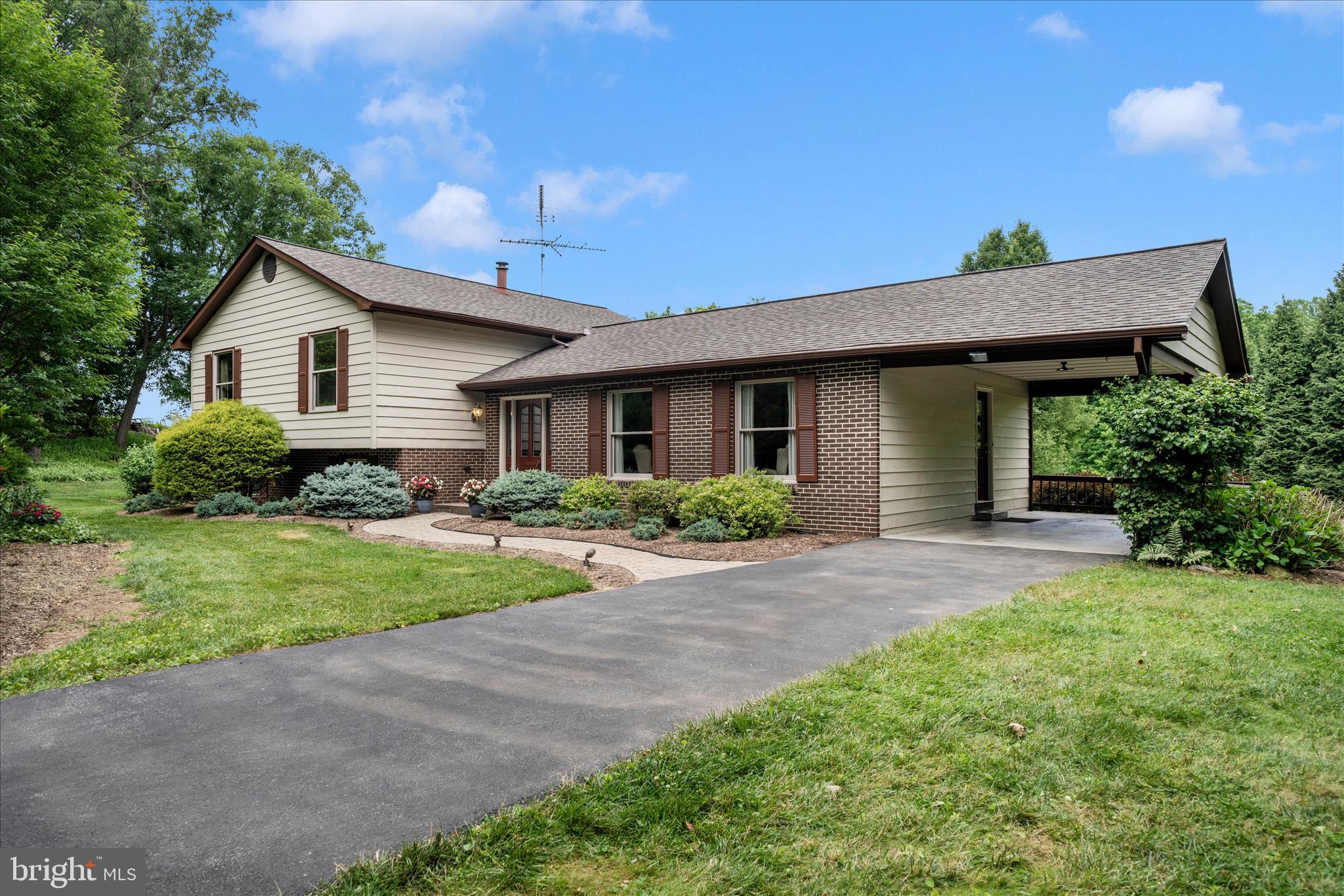 Lovingly maintained by the same owners for 38 years, this private split-level home sits on 1.69 beautifully landscaped acres backing to open land. Designed and cared for by a master gardener, the grounds offer exceptional privacy, mature plantings, and a garden island with water and electric service.
The main level features a spacious living room, a dining room with two sliding glass doors leading to a large deck overlooking the backyard, and a kitchen with convenient access to the carport. Hardwood floors add warmth and character throughout the main living areas.

Upstairs, the primary suite includes a private bath, while additional bedrooms and a full hall bath provide comfortable space for family and guests. The lower level offers a large family room with a wood-burning stove, a half bath, workshop/storage space, and walkout access to the backyard.

Additional highlights include a 12' x 14' shed with electric and windows, an additional shed, ample parking, and a location just minutes from downtown Urbana, shopping, dining, the library, and I-270.