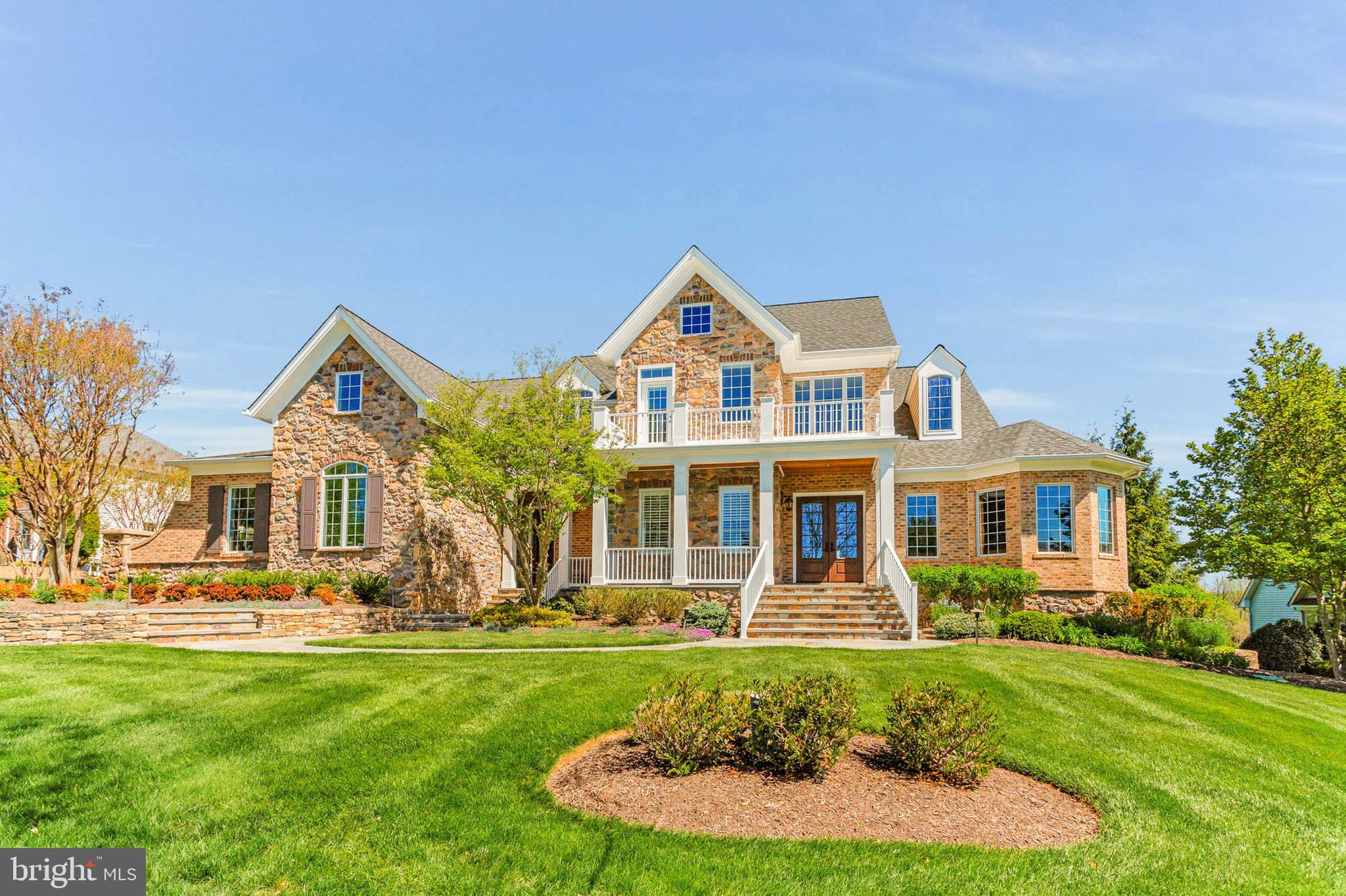 Welcome to this magnificent stone and brick residence located in the highly sought-after Fox Meadow community in West Friendship. A grand, curved bluestone patio and a custom glass front door usher you into 8,500 plus square feet of luxurious finished living space. The stunning two-story foyer features marble tile flooring with a custom emblem, a gracefully curved staircase, and exquisite molding throughout every room.
Main-level living is defined by architectural elegance at every turn, including triple crown moldings, chair rails, wainscotting, eight-foot doorways, oversized windows, custom window treatments and Sonos surround sound throughout home and backyard. Host elegant dinner parties in the dining room, which boasts hardwood flooring and ornate moldings, or unwind in the expansive study equipped with a built-in desk, workstation, and ample cabinetry. The living room, adorned with hardwood flooring, features a gas fireplace set within a floor-to-ceiling stone hearth and a stylish coffered ceiling.
The gourmet kitchen is a chef's dream, showcasing custom cabinetry enhanced by elegant up-lighting. This kitchen includes a Viking range hood, Wolf cooktop and double ovens, granite countertops, a beverage fridge, refrigerated drawers, an ice maker, three sinks, a Miele coffee maker, and a tiered breakfast bar.  The kitchen is complete with a butler's pantry equipped with two wine fridges. Enjoy your mornings in the family room, which offers panoramic views of the backyard, or cozy up with a cup of coffee next to the gas fireplace with a stone surround. The final, most desirable area to relax is the incredible glass-enclosed sunroom, temperature controlled, with a wood burning fireplace—perfect for reading, hosting dinner parties, or enjoying a quiet moment.
The main level also features two half baths, a mudroom area, a laundry room with leathered granite countertops, multiple closets with custom shelving, and access to a back staircase. The master suite is designed for privacy, featuring a tray ceiling with up-lighting, access to the deck, and a sitting area with a dual sided gas fireplace. Two expansive walk-in closets with custom shelving and a luxurious private bath complete this exquisite suite, which includes natural stone flooring, dual shower fixtures, dual vanities, and a jetted heated tub with a waterfall. The soaring ceilings continue into the upper level, which accommodates three generous bedrooms with walk-in closets, a spacious in-law suite, four additional full baths and a large laundry room.
The lower level offers a spacious recreation room that spans the length of the home, complete with a fully equipped bar featuring a copper sink, dishwasher and refrigerator. The oversized gym is exceptional, while additional spaces include a storage room with ample shelving, a utility room with two water heaters, a water filtration system, two radon mitigation systems, and a humidifier.  The heart of the lower level is the home theater room with a projector, screen and surround sound.  The sixth bedroom with a walk-in closet and a private full bath featuring an oversized shower with built-in bench seating. On the other side of the basement, you will find the seventh full bath and a third laundry room—an ideal area to accommodate all your pool guests.
Outside, the meticulously landscaped grounds are an entertainer's dream. The composite deck overlooks travertine tile and bluestone surrounding a heated in-ground pool and jetted hot tub with a waterfall. The poolside area is the perfect retreat, featuring two covered dining areas. The meticulously maintained three-car garage offers ample storage space, is temperature-controlled, potential room for 5 cars (with car lifts) and side entrance for easy access. The professional landscaping and hardscaping rival the exquisite details found within the home.