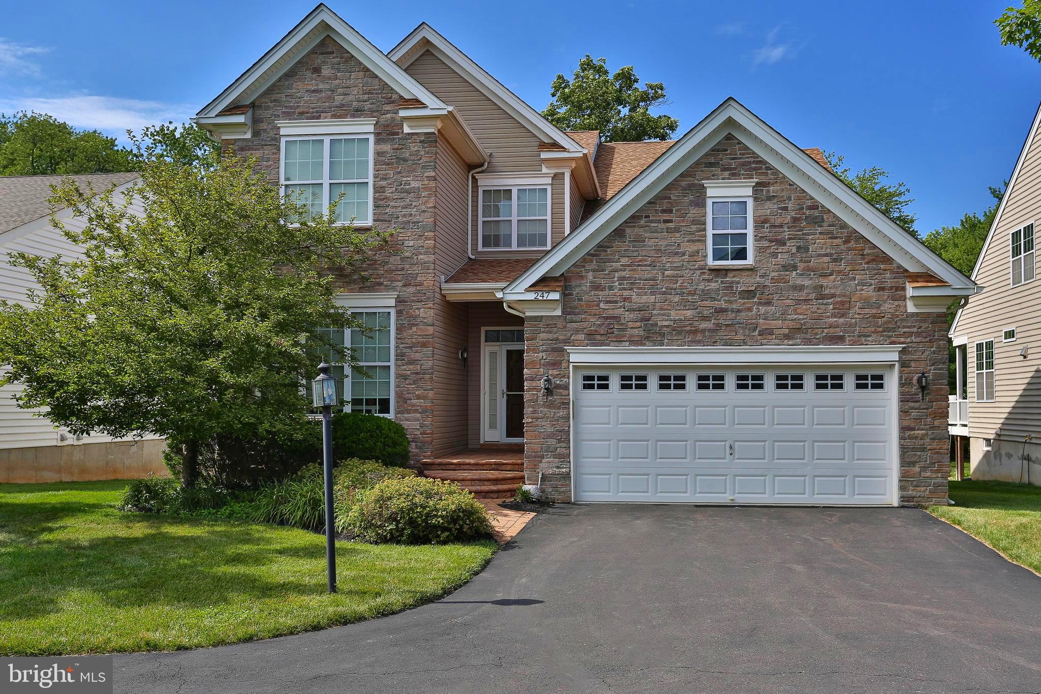 Welcome to 247 Kennedy Way, where luxury, comfort, and low-maintenance living come together in the highly sought-after Regency at Yardley, an exclusive 55+ community. Built in 2015, this exceptional 3-bedroom, 4-bath home showcases elegant design, premium upgrades, and spacious living across three finished levels.

From the moment you arrive, the custom stone front exterior creates stunning curb appeal. Inside, you'll be greeted by beautiful hardwood floors that flow throughout the home, elegant wainscoting throughout the first floor, recessed lighting, soaring vaulted ceilings, striking wrought iron railings along the staircase, and an abundance of natural light pouring through oversized windows.

At the heart of the home is a chef's dream kitchen, complete with high-end stainless steel appliances, a five-burner gas cooktop, dual ovens, granite countertops, abundant custom cabinetry, a full pantry, and a bright breakfast nook surrounded by windows. Just off the kitchen, the elegant dining room showcases an upgraded molding package, creating the perfect setting for holidays and special occasions.

The dramatic family room features a vaulted ceiling, a wall of windows, and a cozy gas fireplace, while the open second-floor balcony overlooks the main living area, adding to the home's grand feel. Step through the sliding glass doors onto the covered Trex deck, where you'll enjoy peaceful, tree-lined views and exceptional privacy.

The spacious first-floor primary suite offers the convenience of main-level living and features a relaxing sitting area by the window, a luxurious spa-inspired en-suite bath with dual vanities, a seamless glass shower with built-in seating and custom tile, plus an oversized walk-in closet designed to provide exceptional storage and organization. A second first-floor bedroom offers flexibility for guests or a home office and is conveniently located next to a full bath. Completing the main level is a laundry/mudroom with direct access to the oversized garage.

Upstairs, the loft landing creates the perfect space for a den, library, or home office. The upper level also features a private guest suite complete with a spacious bedroom, full bath, and its own sitting area, making it ideal for overnight guests or extended family.  Extensive closet space throughout the upper level and additional rooms provides abundant storage, while two additional finished rooms with built-in shelving offer the perfect place for seasonal items, hobbies, or organization.

The finished basement expands the home's living space even further, spanning the entire footprint of the home and featuring recessed lighting, a bar area, and an additional bathroom—perfect for entertaining, recreation, or hosting family and friends.

Life at Regency at Yardley offers more than just a beautiful home. Residents enjoy resort-style amenities including an elegant clubhouse with a grand gathering room, catering kitchen, billiards room, fitness center, and both indoor and outdoor swimming pools. Experience the perfect combination of luxury, comfort, and carefree living in one of Yardley's most desirable active adult communities.
