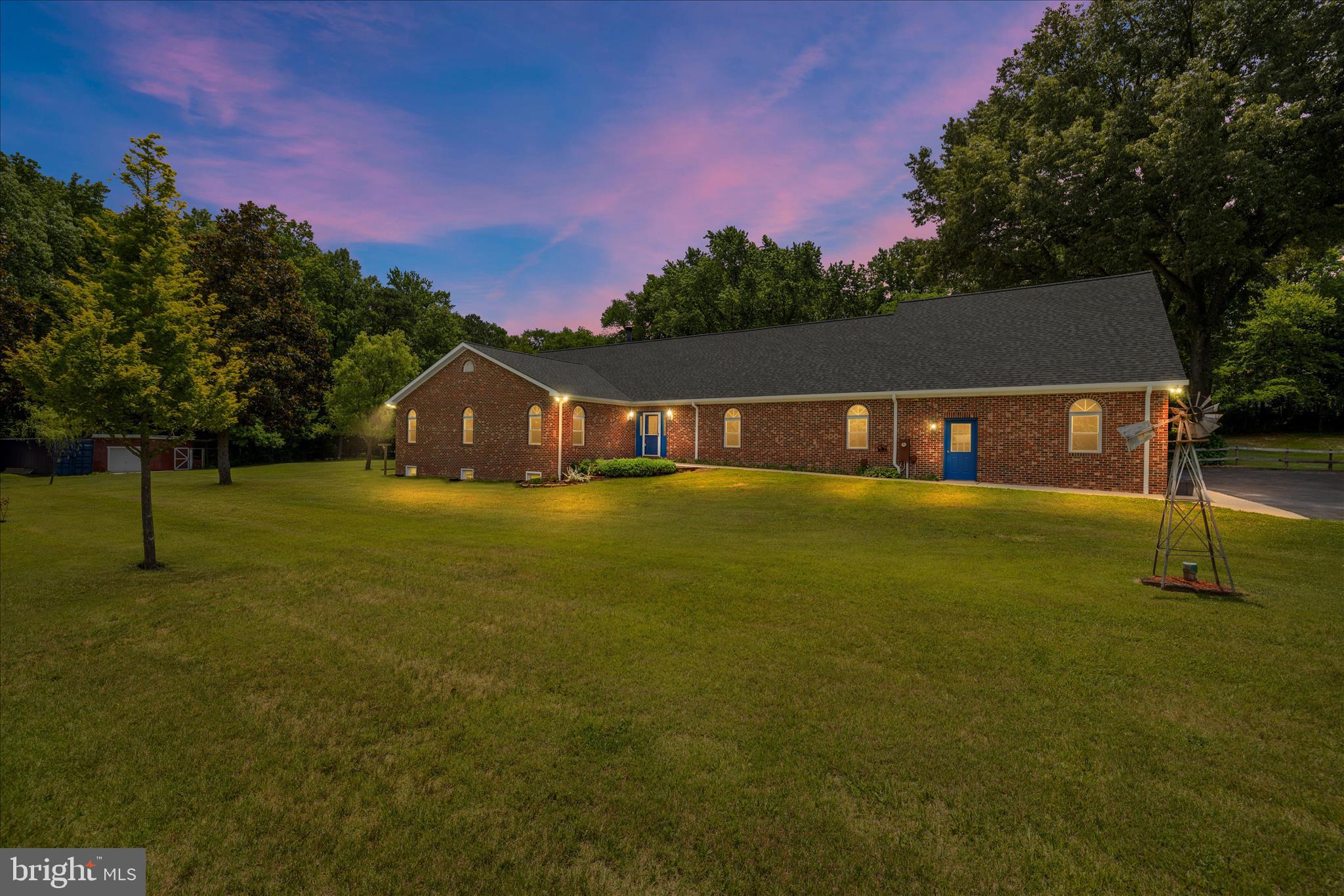 This truly one-of-a-kind and meticulously maintained rambler is privately situated on an expansive 3.2-acre lot with no HOA, offering the perfect blend of privacy, functionality, and versatility. The property is well-equipped with an attached three-car garage, an additional detached garage featuring a horse stall and chicken coop, as well as two 8x40 shipping containers ideal for additional storage, workshop space, or hobby use. Outdoor living is another standout feature, highlighted by a massive screened-in porch overlooking a tranquil koi pond with a waterfall feature, creating a peaceful retreat-like setting. The fully fenced backyard features a large, level lawn, a dedicated play area, and a beautifully established butterfly garden complemented by mature blueberry bushes, thornless blackberry bushes, and strawberry plants, creating an ideal setting for entertaining, recreation, and everyday enjoyment. Designed with accessibility in mind, the home includes a garage ramp providing convenient main-level access, along with wide hallways and 36-inch doorways for handicap-friendly functionality. The recently remodeled kitchen showcases white cabinetry, black quartz countertops, and stainless steel appliances, flowing seamlessly into the dining area and the expansive 29x33 great room. Anchored by hardwood flooring, four skylights, and a wood-burning stove. The main level features four generously sized bedrooms, including a spacious primary suite complete with a walk-in closet and private en-suite bath. The walkout lower level significantly expands the home’s living space with three additional bedrooms, two full bathrooms, a large recreation room, office or playroom area, yoga room, fitness room with weight rack that conveys, storage room, and a second full kitchen equipped with a sink, refrigerator, oven, and dishwasher, ideal for multigenerational living or extended guest accommodations. Adding even more versatility, the property also includes a bonus loft/in-law suite featuring another full kitchen, recreation area, and private bedroom. BRAND NEW ROOF just installed!
