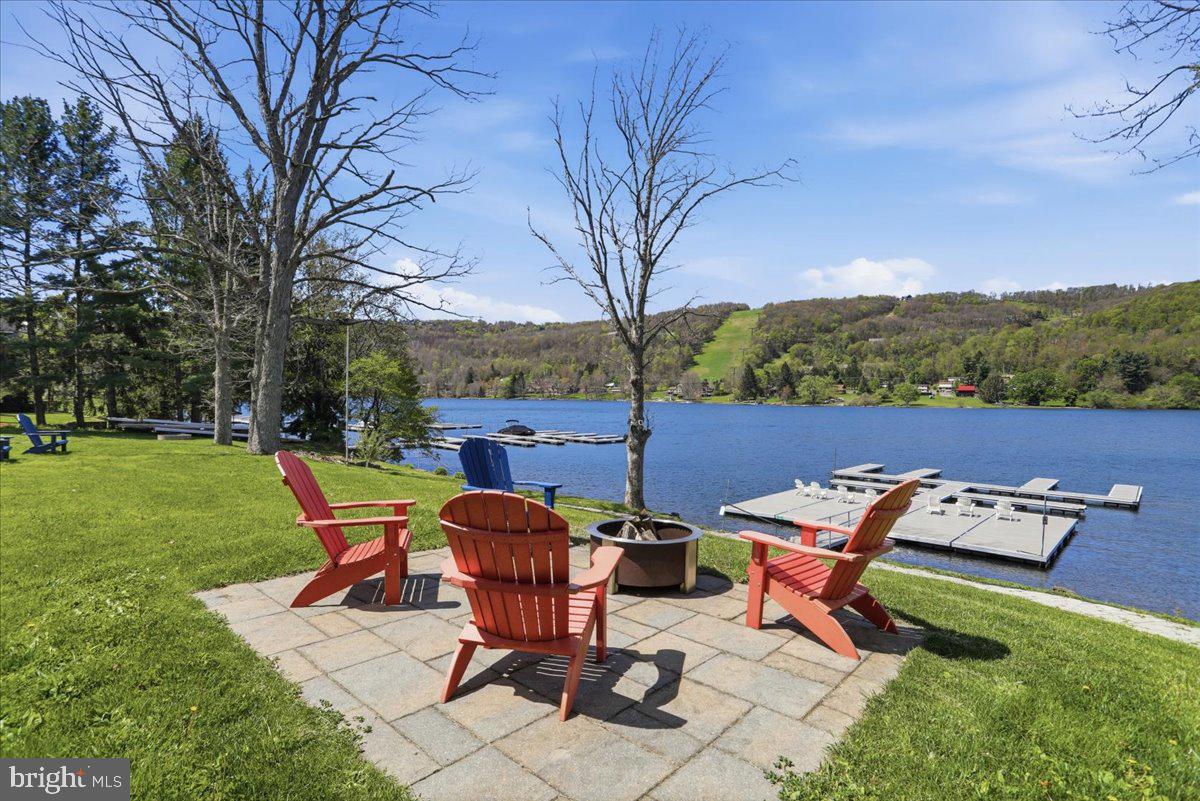 STEPS to the LAKE! BOAT SLIPS! LAKE ACCESS & VIEWS! 4TH OF JULY FIREWORKS VIEWS! SKI SLOPE VIEWS! Cabin #4 at The Lodges of Sunset Village is a detached efficiency unit just STEPS to the LAKE with a king bed, a fully equipped kitchen, a soaking tub, a full bath, and it's fully furnished and turnkey. This unit has a porch, hot tub and patio, too! It's situated on a premier lot just steps from the lake!

10.70% GROSS REVENUE YIELD with a PROVEN  RENTAL HISTORY GENERATING AN AVERAGE OF $42,792 IN ANNUAL GROSS RENTAL INCOME over the last FIVE YEARS  with an AVERAGE of 129 DAYS RENTED annually for an ADR of $332.

Rich in mountain character and charm, this log cabin features uniquely carved wooden doors, beautiful beamed ceilings, warm wood walls, and inviting spaces that create an authentic lake-and-mountain retreat feel. Additional features include lake and ski slope views, expansive decks, upgraded finishes, open-concept living, and a stacked-stone gas fireplace. Enjoy incredible views of Deep Creek Lake and Wisp, along with front-row seats to seasonal beauty and memorable moments, including the annual July 4th fireworks.

This property is an exciting opportunity for buyers seeking both personal enjoyment and investment potential. Community amenities include lake access with 10 shared dock slips and an impressive 1,320-square-foot waterfront dock area, perfect for fishing, swimming, launching kayaks, relaxing by the water, and enjoying summer fun at the lake. Residents and guests also enjoy a lakeside gazebo, playground, fire pit, gathering areas, pet-friendly accommodations, abundant parking, and on-site professional management. 

The monthly fee provides exceptional convenience, including water, gas, electricity, cable, snow removal, trash service, management, road and lawn care, and more... for a low-maintenance ownership experience. 

Call today for details and your private showing!