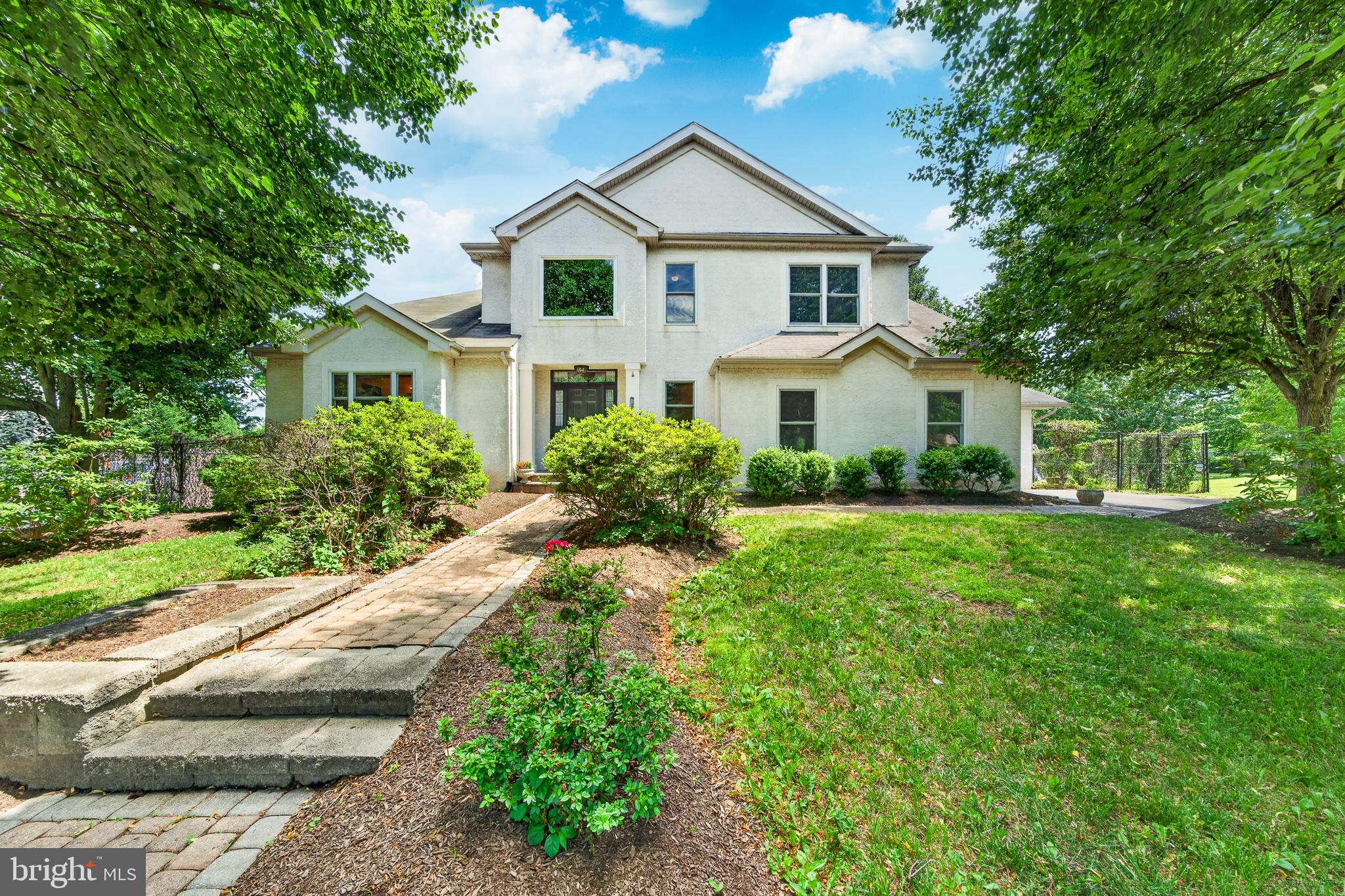 Well‑loved and meticulously maintained home. Enter through a dramatic two‑story foyer with hardwood flooring and a turned staircase leading to a spacious, open layout. The first floor features a convenient primary bedroom with tray ceiling, walk‑in closet, and a full bath with soaking tub, plus a beautiful sunroom‑style addition directly off the primary bedroom with a wood‑burning stove, perfect for an indoor garden, reading nook, or relaxing escape. A stunning two‑story formal living room with fireplace and automatic custom blinds by Hunter Douglas flows into the elegant formal dining room with French doors to a screened‑in deck/patio, and is complemented by a second cozy addition off the kitchen with its own wood‑burning stove and a third addition, an adjacent mudroom. A powder room, laundry room, and oversized two‑car side‑entry garage complete the main level. Upstairs you’ll find two generous bedrooms with fresh paint and new carpet, along with a full hall bath. The finished basement provides additional living and storage space. Major updates include newer Renewal by Andersen windows throughout the main house with transferable warranty, Jeld‑Wen windows in the additions, newer garage doors, a top‑of‑the‑line Carrier modulating HVAC system installed in 2015, and a newer roof on the main house (2019), with roofs on the additions installed when each was built (roughly 2009, 2011 and 2013). Outside, enjoy a fenced yard on approximately one‑half acre with professionally landscaped grounds featuring a 12x16 shed, vegetable garden, fruit trees, kiwi vines, and an on‑site well used for gardening and plants only, along with custom walkways that complete this exceptional home.