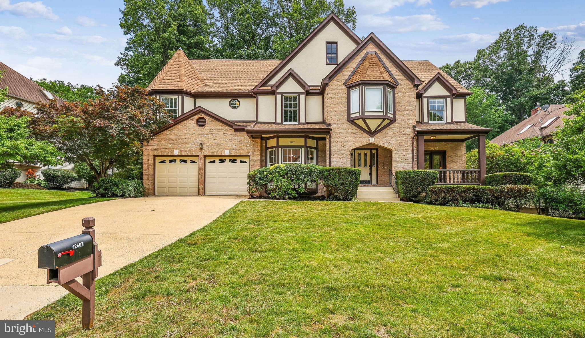 A rare Grand Barrington Tudor in the sought-after Hampton Chase section of Hampton Forest. This brick-and-stucco home offers 5,409 sq ft of living space with a welcoming front porch and sits on a quiet street with a large deck and fenced yard. Recent upgrades include brand-new, high-quality hardwood floors throughout the main and upper levels, fresh modern interior paint, and stylish new lighting with elegant chandeliers. The gourmet eat-in kitchen features quartz counters, a large island, gas cooktop, wall ovens, and newly upgraded stainless steel appliances. The open-concept main level flows beautifully creating an airy, inviting space. A private office has been fully renovated and modernized for today’s work-from-home needs. The two-story family room with brick fireplace opens to the deck—perfect for entertaining. Upstairs, the spacious primary suite includes a sitting area, large walk-in closet, cedar closet, and spa-like bath with double sinks, soaking tub, and separate shower. Three additional bedrooms share updated baths. The finished lower level offers a fifth bedroom with egress, full bath, wet bar, and flexible space for a theater, gym, or recreation area. Smart home features include a Nest thermostat and SimpliSafe alarm system. Excellent commuter location with easy access to major routes, plus top-rated Fairfax County schools.