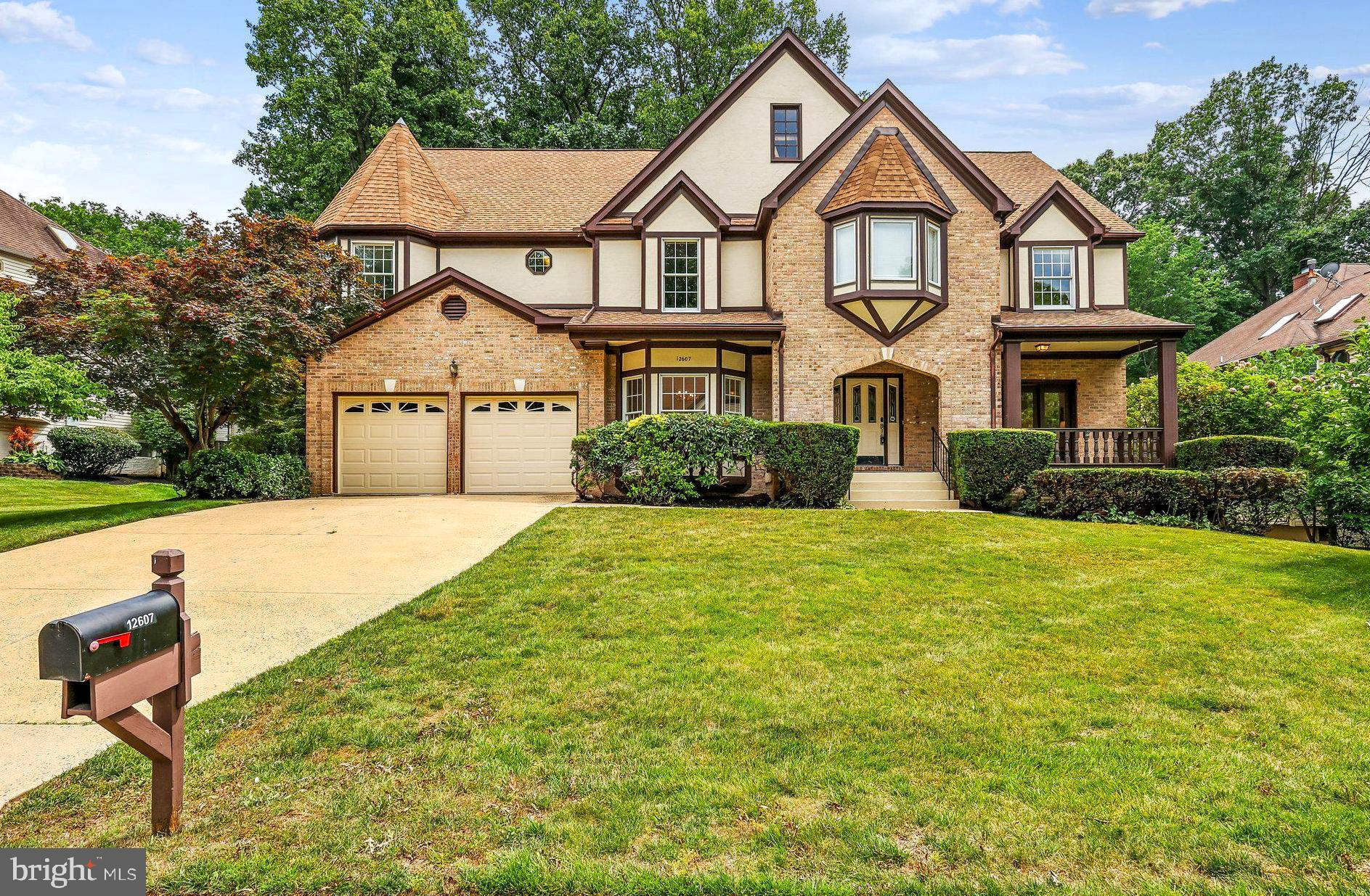 A rare Grand Barrington Tudor in the sought-after Hampton Chase section of Hampton Forest. This brick-and-stucco home offers 5,409 sq ft of living space with a welcoming front porch and sits on a quiet street with a large deck and fenced yard. Recent upgrades include brand-new, high-quality hardwood floors throughout the main and upper levels, fresh modern interior paint, and stylish new lighting with elegant chandeliers. The gourmet eat-in kitchen features quartz counters, a large island, gas cooktop, wall ovens, and newly upgraded stainless steel appliances. The open-concept main level flows beautifully creating an airy, inviting space. A private office has been fully renovated and modernized for today’s work-from-home needs. The two-story family room with brick fireplace opens to the deck—perfect for entertaining. Upstairs, the spacious primary suite includes a sitting area, large walk-in closet, cedar closet, and spa-like bath with double sinks, soaking tub, and separate shower. Three additional bedrooms share updated baths. The finished lower level offers a fifth bedroom with egress, full bath, wet bar, and flexible space for a theater, gym, or recreation area. Smart home features include a Nest thermostat and SimpliSafe alarm system. Excellent commuter location with easy access to major routes, plus top-rated Fairfax County schools.