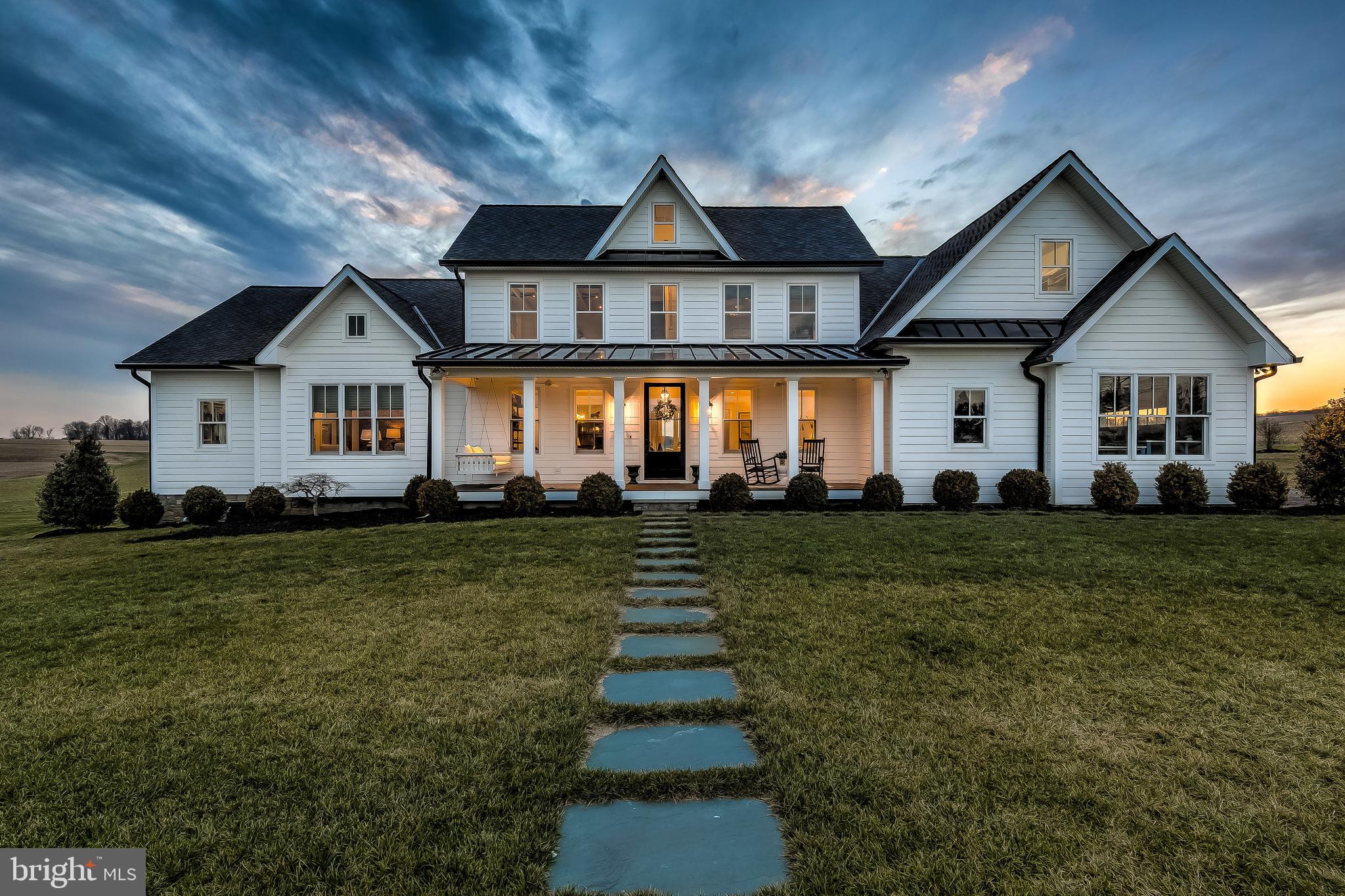 Completely revitalized 1800s farmhouse expanded and reimagined to create a dream home spectacular enough to be given the Maryland Building Association of Excellence award for 2020. Completed in 2019 and situated on 89 acres, the home features 5 bedrooms, 5.5 bathrooms, an attached garage, guest apartment, top of the line pool, ground loop geothermal HVAC system, whole house speaker and alarm system and 5,700+ sqft of impeccably designed living space that expertly combines old farmhouse charm with high end modern amenities. Enjoy the exquisitely chosen décor with layered surfaces and luxe materials –shiplap walls and ceilings, wide plank hardwood floors, antiqued brick, rustic barnwood ceiling beams and mantels, marble mosaic bathroom flooring, and high-end custom light fixtures to name a few- there is no shortage of design inspiration. Combining an array of large open indoor and outdoor spaces with cozy nooks, the layout of the home is functional but also warm and inviting and provides excellent spaces for either relaxing or entertaining. Guests will enjoy entering the home through the formal front door with a southern inspired front porch while the attached garage leads to an oversized mud room with custom built in cabinets, ample storage for coats and shoes, and a dog room with its own canine grooming and wash station. The heart of the home is a massive great room with lofty 14- foot beamed ceilings, wide planked hardwood floors, shiplap walls, and a towering white brick wood burning fireplace with reclaimed barnwood mantel and shelving. The chef’s kitchen is exquisite with soapstone counters, commercial grade appliances, range hood, oversized island and a fully incorporated hidden panty equipped with additional refrigerator, dishwasher and sink. Walls of Pella windows and glass doors offer sweeping views and lead you into an incredible western facing outdoor living space with hardwood floors, outdoor stone fireplace, plantation ceiling fans and is equipped with a fully retractable electric Phantom screen system. Gaze further out and find the brand new pool with pebble tec finish, ledge lounger, automatic pool cover and infinity views of nothing but fields and farmland. Back inside, there is so much more to explore- the master bedroom features an antique washed brick accent wall, large en-suite bathroom with heated floors, dual walk in closets with custom built ins, an elegant stand alone porcelain tub and large marble and glass standing shower. Re-enter what was the original 1800s farmhouse to find 2 of the most charming bedroom suites ever created- they both feature original exposed ceiling beams and flooring, shiplap walls, large windows overlooking the countryside and perfect modern farmhouse style en-suite bathrooms. A cozy yet functional playroom and an office are situated on attic level. The 4th bedroom on the main level offers lots of versatility as an additional child’s room, guest room or office. Additionally, there is a 1 bedroom, 1 bathroom guest apartment with living room, kitchenette, private laundry room and is roughed in for the addition of an elevator. Use the 89 acres of flat scenic farmland for growing crops, raising livestock or expand your imagination and create the most amazing equestrian estate in the county. The location is wonderful- close enough to major commuting routes- I83 and I95 so you can be downtown in 30 minutes or get to Hunt Valley in 15. There is truly no other home like this and is ideal for the homeowner who wants a tremendous amount of land and privacy but does not want to sacrifice luxury, lifestyle or convenience.