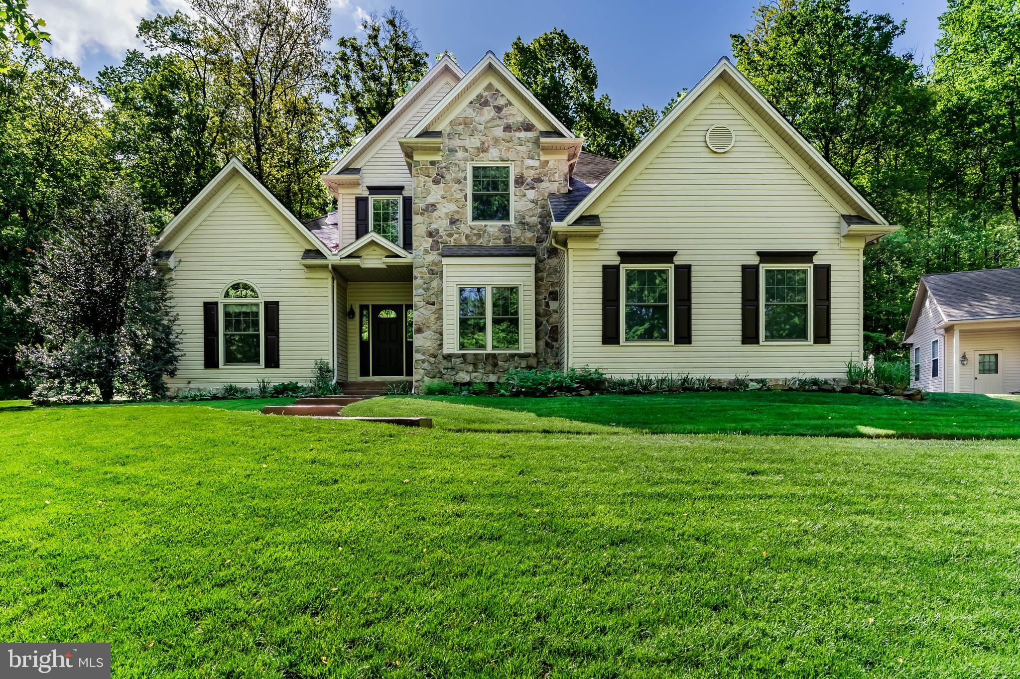Welcome home to your private wooded paradise! This Jim Miller custom built, one-owner home is situated on 8.74 acres and radiates pride of ownership from every angle. Nestled in an entirely wooded setting with seasonal views of Ski Roundtop, this exceptional 5 bedroom, 3.5 bath home offers a perfect blend of craftmanship and comfort. The main level impresses with nine foot ceilings, with a primary suite featuring elegant tray ceilings and a cozy gas fireplace. The heart of the home - a gorgeous kitchen with granite counters, an eating bar and custom lace wood mahogany cabinetry - flows seamlessly into the 18’ cathedral ceiling family room, anchored by a striking stone floor to ceiling wood burning fireplace. You will also find the laundry room on the main level.  Upstairs you will find 3 generously sized bedrooms with a full bath and walk-in attic for additional storage. The lower level delivers even more living space with a massive game room, 5th bedroom, flexible office/workout room and another full bath. Energy efficient geothermal heating and cooling along with a tankless water heater keeps you comfortable year round, complemented by a back-up generator. Entire home also has new Window Nation windows with transferrable warranty, installed in 2024. Outside, the entertainment possibilities are endless. A beautifully designed patio by Hively Landscapes features built-in gas grill, fire pit, fish pond with waterfall and lighting, and stamped concrete walkways. A detached 3 car garage with carport, woodshop and greenhouse rounds out the property. Escape to nature with your own half mile walking trail alothe perimeter along with a play area with swing and rubber mulch in the back yard. Located in the much sought after Northeastern school district.  Schedule your private showing today!