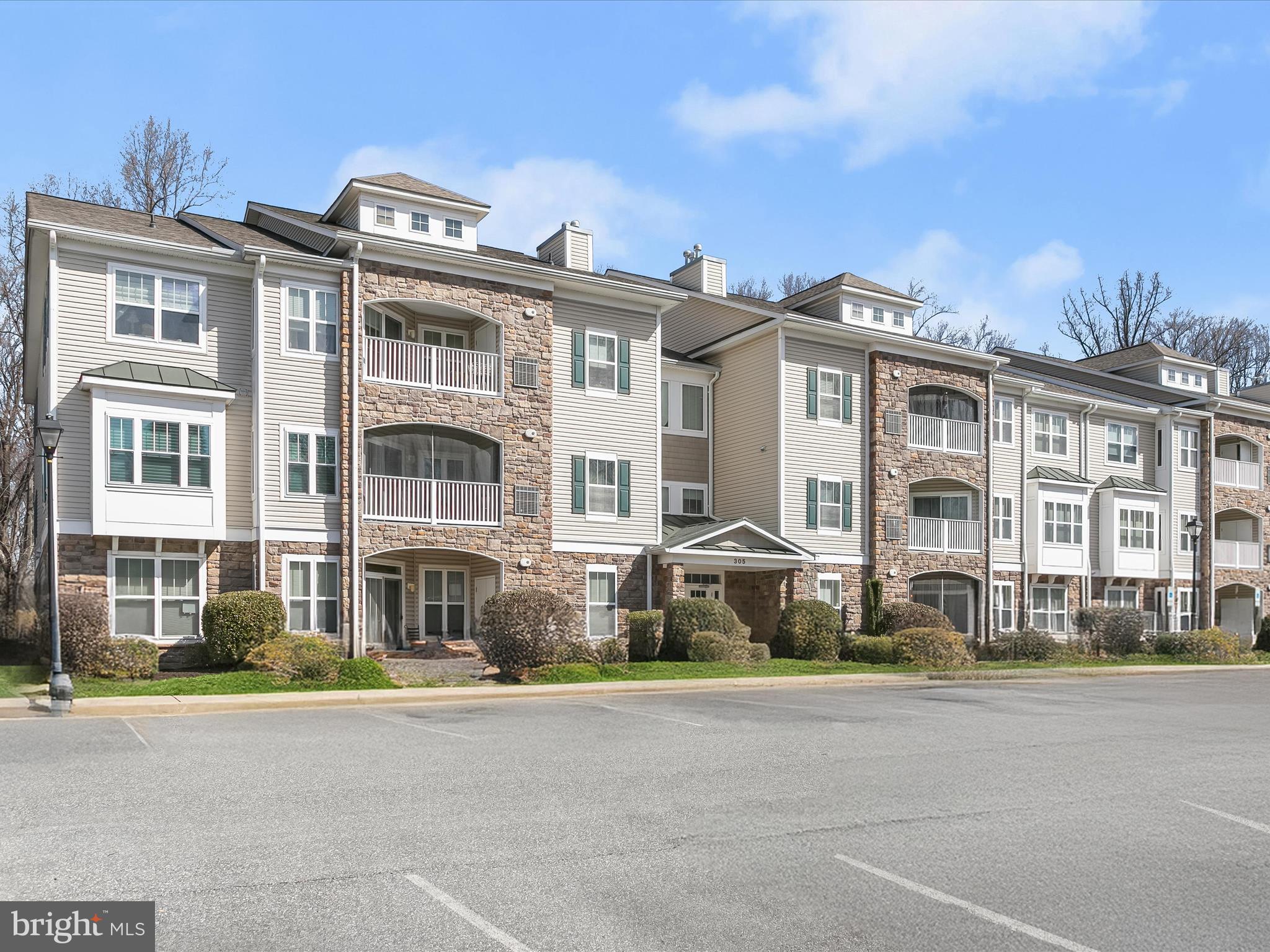 Nestled in the 55+ community of Wyndham Commons, this two-level penthouse condo offers two bedrooms, two bathrooms, and a versatile loft. Conveniently located in Owings Mills, it provides easy access to everything you need with a wide variety of shopping, dining, entertainment, and amenities close by. Positioned on the top floor, this corner unit is filled with natural light. An open-concept design highlights the soaring 18-foot vaulted ceiling, creating an airy and spacious feel. The living room’s cozy gas fireplace adds warmth, while the dining area opens to a private balcony with tranquil wooded views. The kitchen has ample storage, a breakfast bar for casual meals, a pantry, and a laundry room with a full-size washer and dryer.Retreat to the primary bedroom that features a walk-in closet and an ensuite bathroom with a walk-in shower, soaking tub, dual sink vanity, and linen closet. A second bedroom and full bathroom with a tub-shower are located on the opposite side of the unit for added privacy. Upstairs, the loft provides a flexible space that is ideal for an office, lounge, or potential third bedroom. Recent updates include a new HVAC system and hardwood flooring. Building elevators, a secure lobby and ample parking enhance accessibility and peace of mind.
