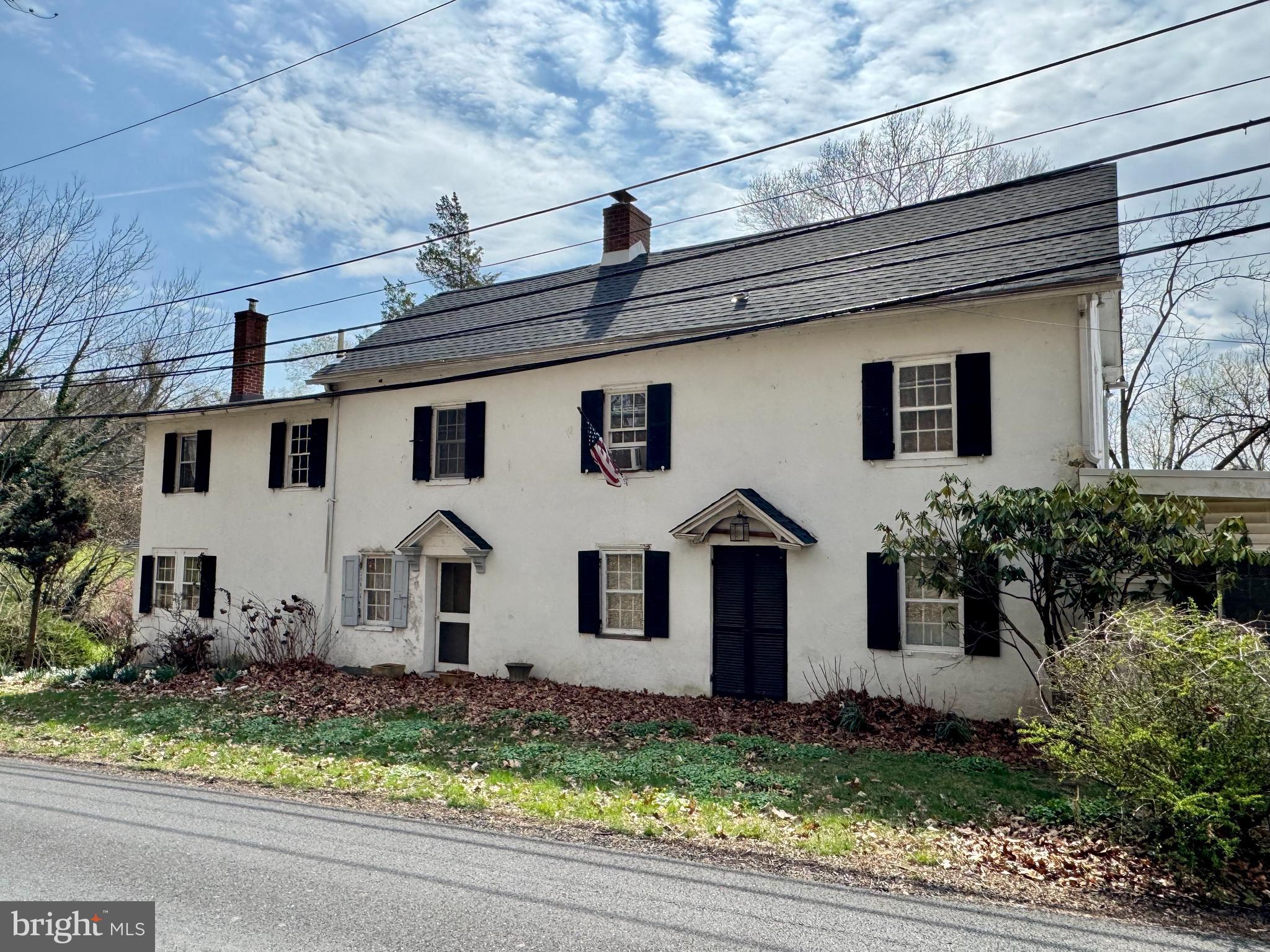 Truly one-of-a-kind, this character-filled large stone farmhouse dates back to the 1800s and sits on a rare double lot in a peaceful, scenic location. Brimming with old-world charm, the home offers a blend of unique historic details and spacious living. The first floor welcomes you with a formal living room, a striking kitchen featuring cathedral ceilings and exposed beams, a generous family room with a stunning fieldstone fireplace, a formal dining room perfect for entertaining, and a bedroom with a private bath. Hardwood floors run throughout the home, adding warmth and timeless appeal. Upstairs, the second floor features a spacious main bedroom with vaulted ceilings, along with three additional well-sized bedrooms. The third floor is a true bonus, offering two more bedrooms and a cozy sitting room between them — an ideal retreat or creative space. Located on a quiet road with a beautifully scenic yard, the property offers a rare sense of privacy. While this gem needs some work, it presents an incredible opportunity for restoration. Sold strictly as-is; all certifications, inspections, and permits are the buyer's responsibility. A unique opportunity to own a slice of history with endless potential.