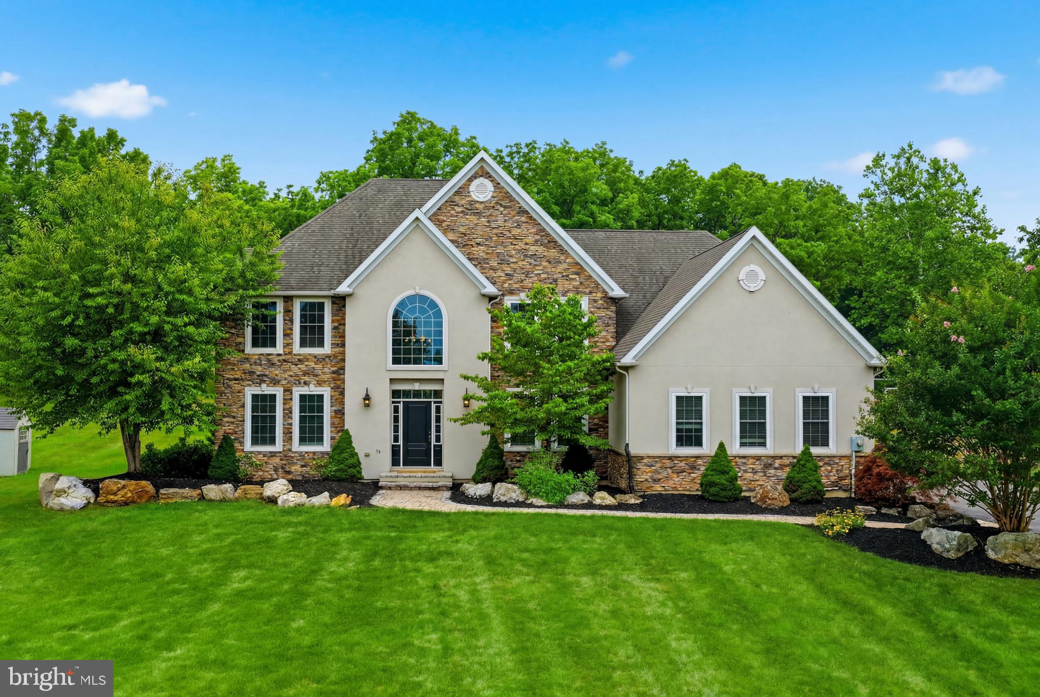 Welcome to this exceptional 6-bedroom, 4.5-bath Colonial, beautifully situated on 1.24 picturesque acres and thoughtfully upgraded throughout. *LOW UTILITIES DUE TO NATURAL GAS AND WELL INSULATED!* From the moment you enter the impressive two-story central hall foyer with dual coat closets and a sweeping curved staircase accented by elegant black wrought iron railings, you'll appreciate the home's timeless craftsmanship and sophisticated design. Gleaming hardwood floors flow throughout the main living areas, while French doors open to a private den, study, or home office featuring recessed lighting. The formal dining room is perfect for entertaining with recessed lighting and a stunning chandelier. At the heart of the home is the beautifully upgraded gourmet kitchen, complete with quartz countertops, stainless steel appliances, a double wall oven, built-in gas cooktop with vent hood, tiled backsplash, recessed lighting, deep farmhouse sink, and a spacious center island with pendant lighting and breakfast seating. An adjoining dining area overlooks the backyard, while the dramatic two-story family room showcases soaring vaulted ceilings, recessed lighting, a ceiling fan, and an impressive floor-to-ceiling stone fireplace. Two generously sized guest bedrooms connected by a Jack and Jill bath, along with a convenient powder room and laundry room, complete the first floor. Upstairs, hardwood floors and ceiling fans create comfortable retreats in each spacious bedroom. The luxurious primary suite offers a tray ceiling with recessed lighting, an elegant chandelier, and a private sitting area. The spa-inspired en-suite bath features hardwood flooring, a vaulted ceiling with decorative beams, marble-topped dual vanities, a tiled garden tub, an oversized tiled walk-in shower with a rain showerhead, and a private water closet. Two additional bedrooms share a Jack and Jill bath, while another full hallway bath provides added convenience for family and guests. Outside, the home's striking stucco and stone veneer facade, three-car side-entry garage, and extra-long paved driveway create exceptional curb appeal. The backyard is a true private oasis, featuring a peaceful Koi pond, spacious deck, inviting fire pit, and charming brick walkway—offering the perfect setting for relaxing evenings, outdoor entertaining, and enjoying the beauty of nature.