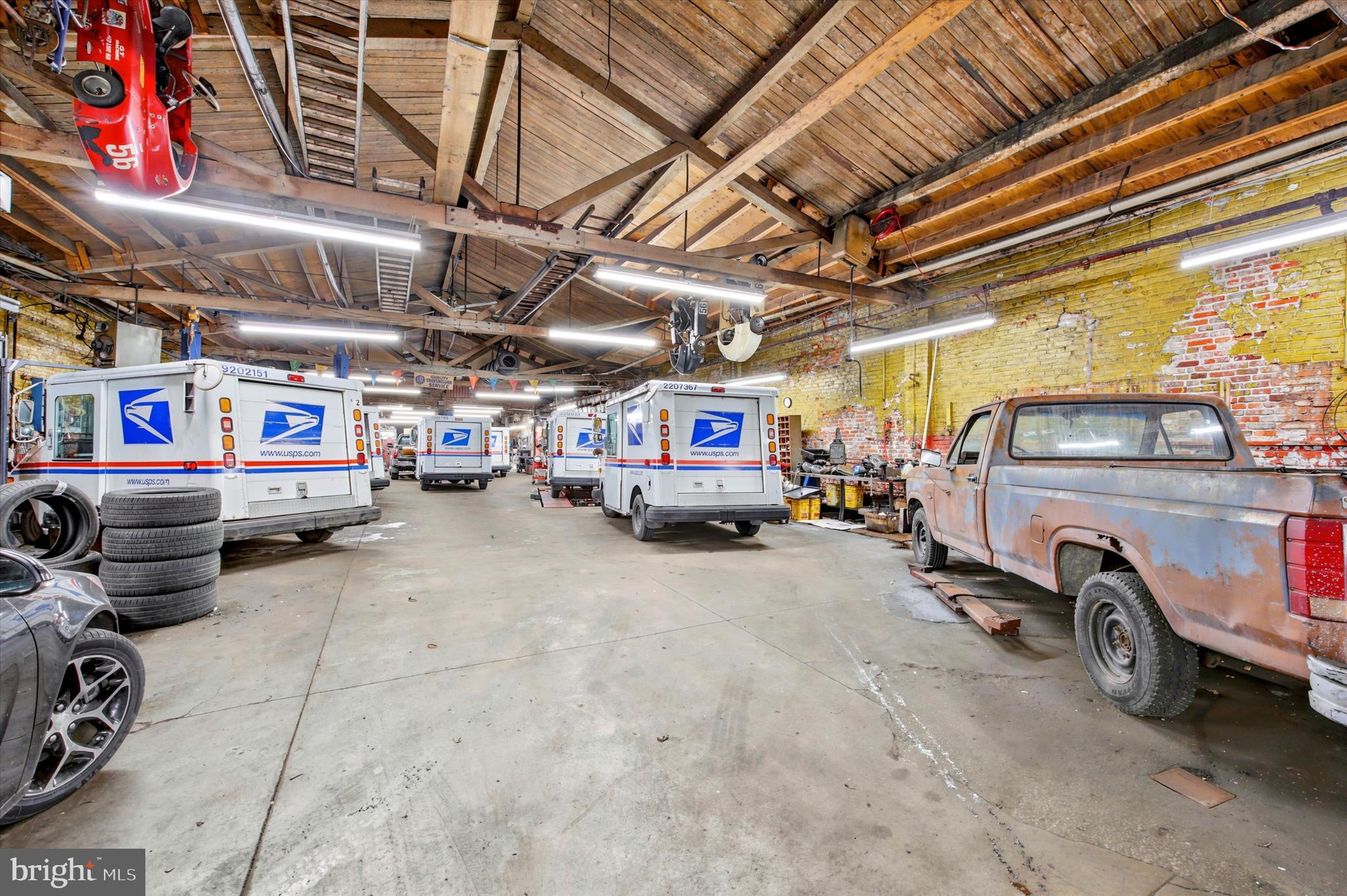 Rockland Capital, LLC is pleased to exclusively present the opportunity to acquire 4515-4525 Lancaster Avenue, a well-located industrial/commercial assembly in the Wynnefield section of West Philadelphia. The offering consists of an 11,600± square foot masonry and wood-frame building, currently operated as a long-standing auto repair and inspection facility, along with two additional adjacent parcels of vacant land. In total, the assemblage comprises approximately 17,000± square feet of land area.
The improved building is configured as an open-bay automotive service garage with 14ft high ceilings, 1ft x 11ft front entry garage door, rear garage door, exposed timber and roof framing, multiple service bays, a mezzanine storage area, and a fenced side yard. The property has been operated as a family-owned automotive repair, collision, and state inspection facility for decades, and offers an investor or owner-user the opportunity to continue automotive use, redevelop, or repurpose the site under the flexible CMX-2 zoning designation. Business and all equipment are negotiable.
The adjacent vacant land parcel provides excess yard/storage area or future development potential, subject to zoning and municipal approvals. This is a rare opportunity to acquire a sizable contiguous holding directly on Lancaster Avenue, a major commercial corridor connecting West Philadelphia to the Main Line, with excellent visibility, signalized access, and proximity to dense residential neighborhoods, public transit, and major roadways.