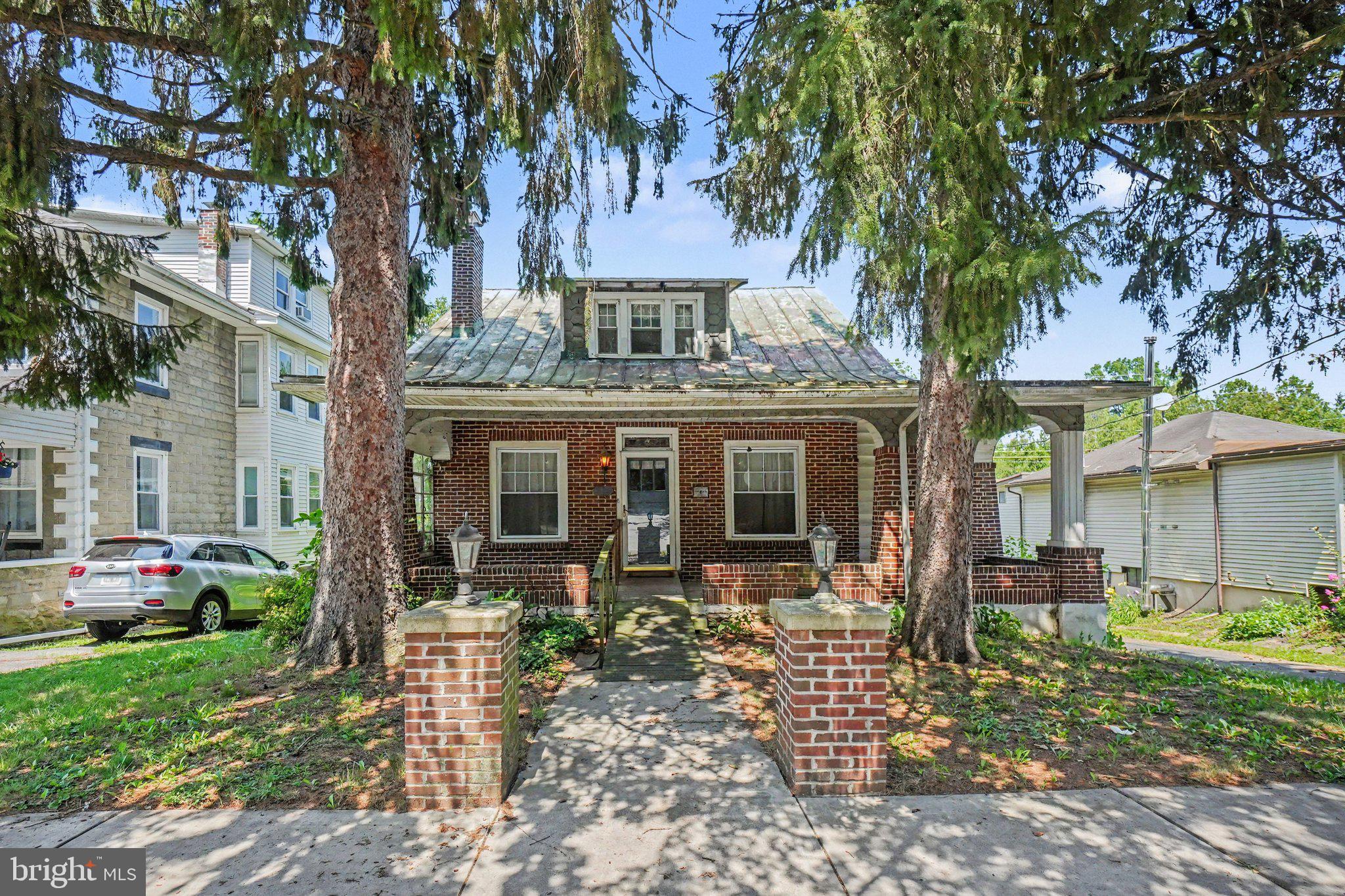 Welcome to this classic brick Cape Cod, lovingly owned since 1980 and ready for its next chapter! Built in 1915, this home is full of character, timeless charm, and endless potential for someone looking to restore and personalize a well-built home.

Situated on a beautiful, spacious, and serene 0.46-acre lot backing directly to Umbenhauer Park, you'll enjoy the rare benefit of no homes behind you—just peaceful green space with a pavilion, picnic tables, playground, mature shade trees, and open lawn to enjoy. The setting truly needs to be seen in person to be appreciated.

A covered front porch stretches across the entire front of the home, creating a welcoming place to relax, while the brick pillars with lighting and front sidewalk add to its curb appeal. Inside, you'll find original wood trim, a beautiful staircase, a spacious living room with a fireplace, a formal dining room, an eat-in kitchen, and a large sunroom featuring a wood stove. Just off the kitchen, a deck overlooks the beautiful backyard, providing the perfect spot to enjoy your morning coffee, unwind in the evening, or take in the peaceful park-like setting. Main level also has a first-floor bedroom with an attached full bath with a walk-in shower which offers the flexibility of one-floor living or can easily be used as a home office, playroom, hobby room, craft room, or guest suite to suit your needs.

Upstairs are three additional bedrooms, all with hardwood flooring, ceiling fans, and closets, along with a full bathroom that even includes its own large closet. For a home of this era, you'll be pleasantly surprised by the abundance of closets and storage throughout.

Additional features include replacement windows, central air conditioning, public water and sewer, oil heat, electric hot water, and an attached oversized garage with an adjoining workshop—perfect for hobbies, projects, or extra storage.

This home does require updating and is being sold AS-IS. Some personal property will remain with the home. If you've been searching for a property with great bones, classic architectural details, an exceptional lot, and the opportunity to create something truly special, this is one you won't want to miss. Conveniently located with easy access to Routes 183, 222, 422, and I-78.