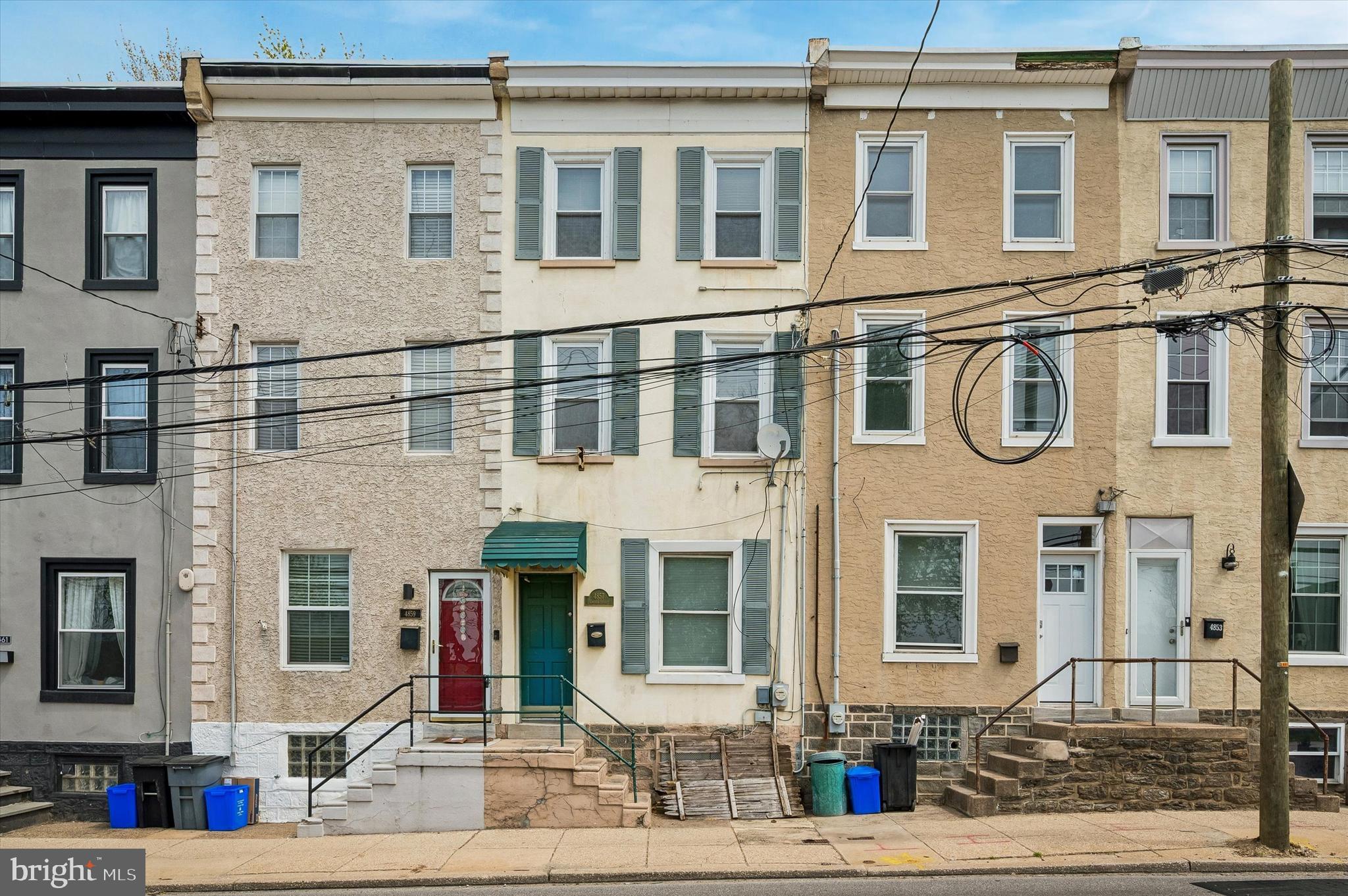 Welcome to 4857 Umbria Street, a fully renovated 4 bedroom, 2 bathroom Manayunk townhome offering true turnkey living with hardwood floors throughout and an exceptional oversized private rear yard, with a PPA parking lot located directly across the street. This home has just undergone a complete cosmetic overhaul including newly sanded and stained hardwood flooring across all levels and fresh paint throughout. The result is a bright, cohesive interior that feels clean, elevated, and ready for immediate occupancy. The main level features an expansive open living and dining space with soaring ceilings, original architectural details, and strong natural light. The kitchen is thoughtfully updated with white cabinetry, stainless steel appliances, and modern finishes, with direct access to the rear yard. The outdoor space is a rare standout for the neighborhood. A deep, private, recently landscaped yard offering meaningful square footage and true usability for entertaining, dining, or everyday living. The upper levels provide four well proportioned bedrooms and two updated bathrooms, including a Jack and Jill layout with exposed brick and a skylight. Each level maintains the same clean finish and hardwood continuity throughout. A full basement offers substantial storage and laundry space, adding to the overall functionality of the home. Positioned just steps from regional rail and a short walk to Main Street, with convenient parking options directly across the street, this is a polished, move in ready home with scale, outdoor space, and location that is difficult to replicate at this price point.