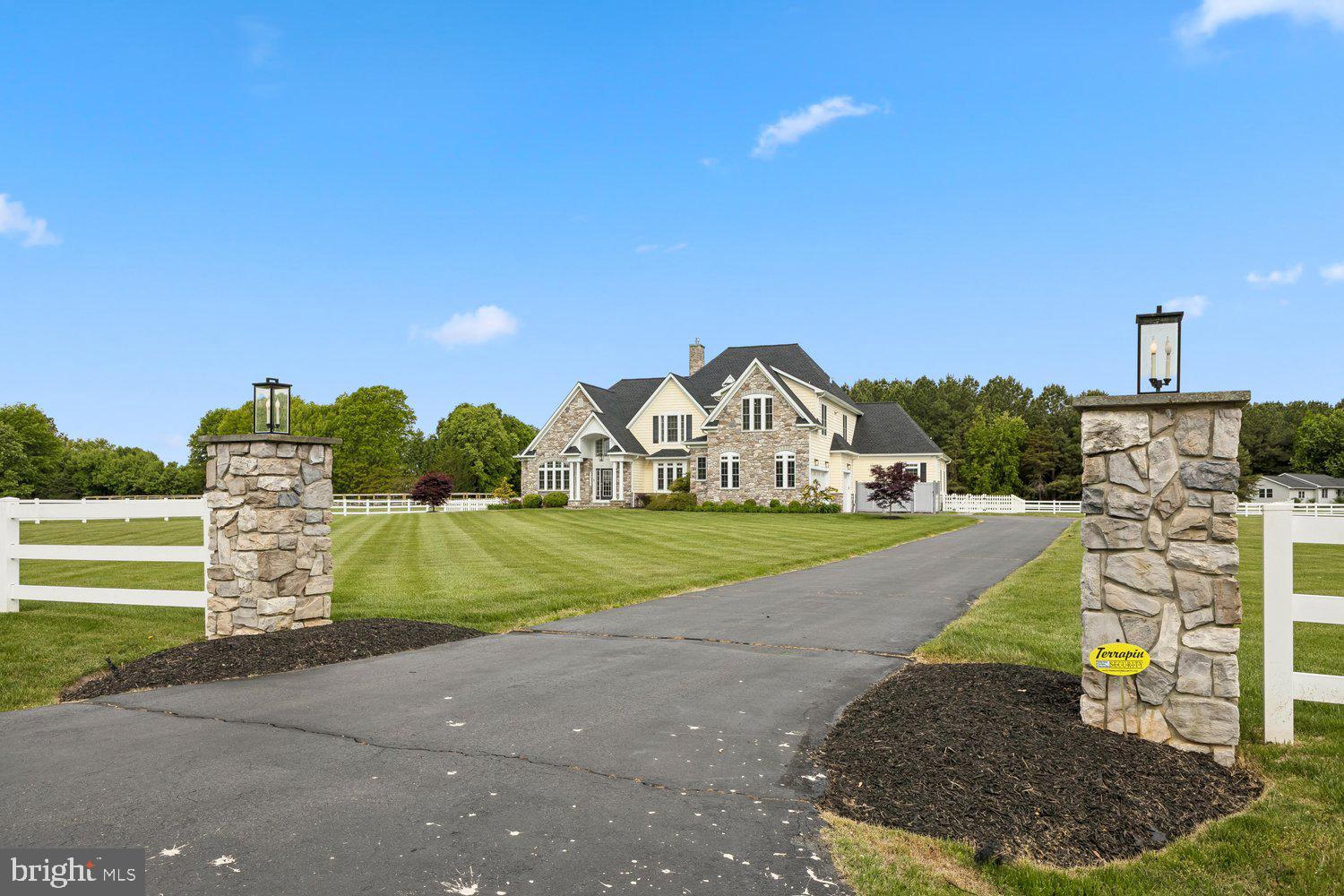 Experience a true “wow” moment the instant you arrive at this meticulously maintained estate in the exclusive Bennett Point community, set on a private street with views of the renowned Wye River.

Step into the grand foyer and be greeted by soaring ceilings, elegant columns, lighted niches, graceful arches, and a stunning curved staircase. The home opens into a formal dining room perfect for entertaining, flowing seamlessly into a dramatic two-story family room with a wall of windows overlooking the patio, saltwater Gunite pool, fenced backyard, and barn.

A floor-to-ceiling stone gas fireplace anchors the space—ideal for cozy winter nights or gathering for the big game. The open-concept layout continues into a chef’s dream kitchen, featuring granite countertops, abundant Merillat Masterpiece solid cherry cabinetry, and premium appliances including a Sub-Zero refrigerator/freezer, commercial-grade Viking cooktop with hood and pot filler, double wall ovens, built-in microwave, beverage cooler, dishwasher, and ice maker. A spacious island, built-in desk, appliance cabinet, hidden cutting board, and corner pantry make this kitchen as functional as it is beautiful.

The main level offers two luxurious owner’s suites. The primary suite includes a wet bar, private sitting area, dual walk-in closets, and a spa-inspired bath with heated soaking tub, dual-head shower, travertine floors, and marble countertops. The second suite features a gas fireplace, built-in desk, and an accessible ensuite bath with roll-in shower and elegant finishes—ideal for multi-generational living or guests. A main-level laundry room adds everyday convenience.

Throughout the home, you’ll find rich teak flooring, tray ceilings, and abundant recessed lighting. Upstairs, three spacious bedrooms each feature private ensuite baths, along with a large game room. A generous unfinished third level offers endless possibilities for expansion, including an au pair suite or additional bedrooms.

Outdoor living is equally impressive. Enjoy the fenced saltwater pool with water feature, a screened porch with Easy-Breeze windows for year-round use, and a beautifully maintained yard with underground irrigation, vegetable garden, and whole-house generator. The conditioned crawl space adds efficiency and peace of mind.

Equestrian enthusiasts will appreciate the adjacent horse training facility with covered arena. The property includes a 3-stall barn with heat sensor, two pastures, dry lot, heated water, electric, and vinyl fencing—perfect for year-round care and riding.

This exceptional property offers luxury, functionality, and lifestyle—all in one remarkable setting.