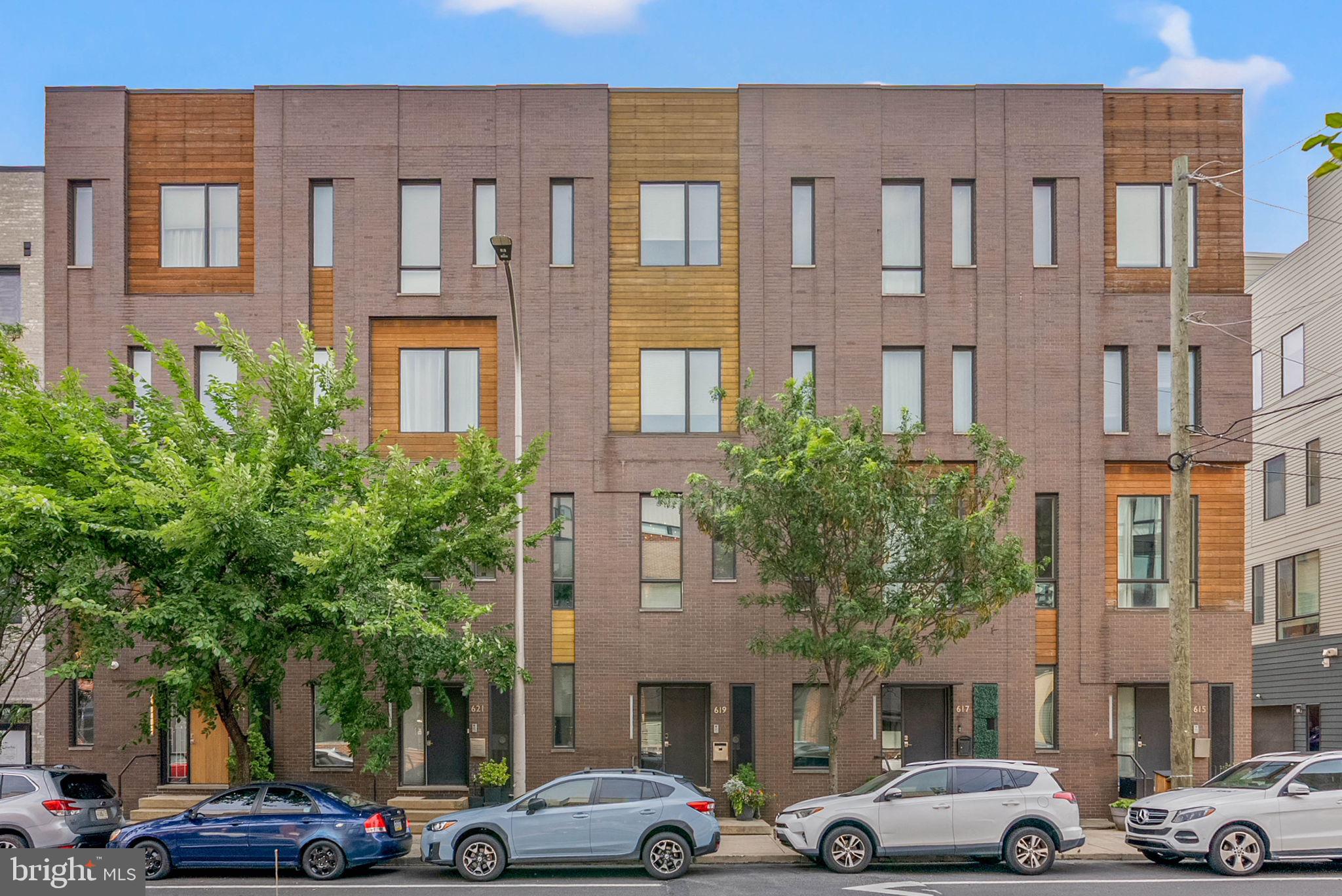Welcome to 619 N 5th Street at the gorgeous Fairmount West community in Northern Liberties. This professionally designed residence offers exceptional living and entertaining spaces across five finished levels, private garage parking and an expansive roof deck designed for year-round enjoyment. From the moment you enter, the home's attention to detail is evident, with soaring 10 foot ceilings throughout, abundant natural light, designer finishes and seamless access through both the front entrance and oversized private garage.

The main living level was designed with both everyday living and entertaining in mind. Ten-foot ceilings and oversized windows create a bright, airy atmosphere, while the chef's kitchen is outfitted with premium Bosch appliances including double convection ovens, a gas cooktop, vent hood, dishwasher, and a Samsung French-door refrigerator. A gas fireplace anchors the living space, while the dining area is highlighted by a statement chandelier and flows effortlessly to a large private deck complete with a hard lined natural gas Weber grill.

The THIRD FLOOR primary suite occupies its own private retreat, featuring two custom walk-in closets, a spacious spa-inspired bath with double vanity, private water closet, custom storage, and a walk-in shower with rain shower head, bench seating, and frameless glass enclosure all adorned with Porcelanosa Tiles. A portion of this floor was designed as a dedicated laundry room and closet area. The side by side laundry is neatly designed behind custom milllwork.

The upper level features two generously sized guest bedrooms, a beautifully appointed full bath, and a unique entertaining bar complete with custom cabinetry, sink, refrigerator, dishwasher and dedicated storage, creating the perfect service area for gatherings on the roof deck above. Spanning the full length of the home, the rooftop terrace offers multiple zones for dining, lounging, and entertaining, enhanced by commercial-grade lighting, natural gas connections for grilling and fire pit features, and sweeping center city views.

The finished lower level further elevates the home with a dedicated home theater, flexible gathering space, fitness area, and extensive storage. Whether hosting movie nights, creating a private wellness studio, or simply enjoying additional living space, this level provides remarkable versatility. Unlike other homes, the basement spans the entire foot print of the home, even under the garage, creating a massive space for living and storage.

Additional highlights include an oversized private garage with premium epoxy flooring, custom Elfa storage systems, electric service suitable for charging equipment and vehicles, multiple outdoor water connections, and a well-managed homeowners association that maintains common landscaping, snow removal, and guest parking areas.

Offering a rare combination of scale, functionality, luxury upgrades, and exceptional indoor-outdoor living in one of Philadelphia's most vibrant neighborhoods, 619 N 5th Street at Fairmount West presents an opportunity to enjoy Northern Liberties living at its finest.