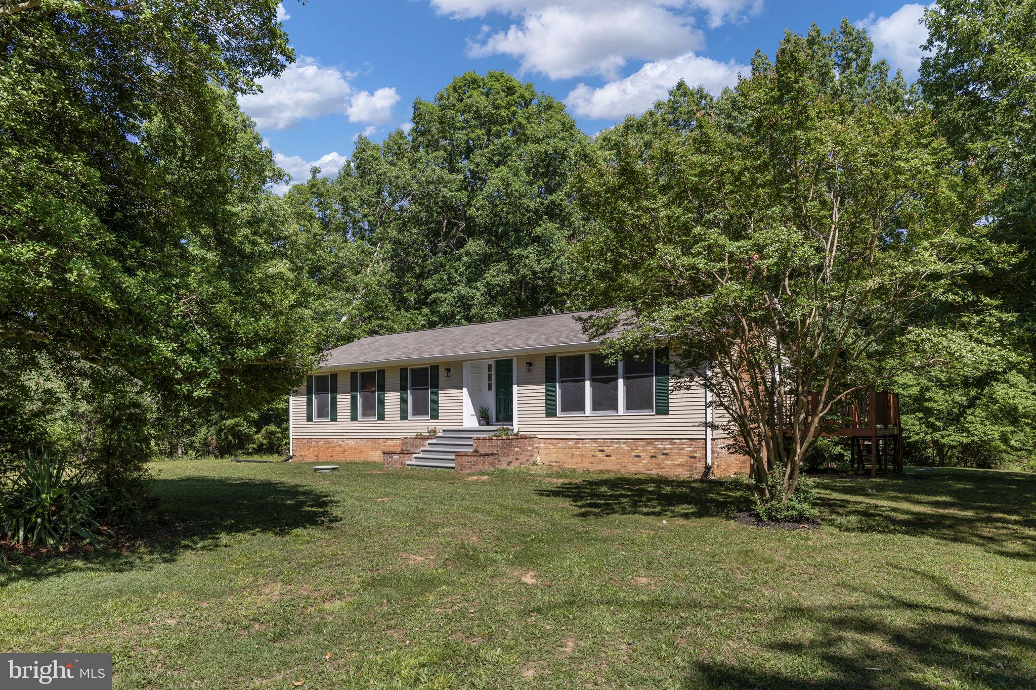 Set on a beautiful, level lot surrounded by mature trees and natural beauty, 15214 Spotswood Furnace Road offers the rare combination of privacy, flexibility, and extensive updates, all without the restrictions of an HOA. This home is on two lots so your total acreage is .92, right under an acre. Thoughtfully improved over the years, this five-bedroom home provides exceptional space for gathering, entertaining, multi-generational living, or simply enjoying a more relaxed lifestyle while remaining less than 15 minutes from everyday conveniences. One of the home's most impressive features is its remarkable flexibility. The spacious lower level has been transformed into an expansive living area that easily adapts to a variety of needs. Whether used as a recreation room, media space, play area, guest quarters, or additional family room, the basement offers tremendous versatility. Two additional bedrooms were added in 2025, creating even more possibilities for growing families, guests, home offices, or multi-generational living. The heart of the home is the beautifully renovated kitchen. Completely reimagined in 2025, the space was fully gutted and rebuilt with new cabinetry, butcher block countertops, updated flooring, newly run electrical, modern fixtures, and a new dishwasher and range hood. Friends and family often remark on how open and inviting the kitchen feels, especially compared to its original layout. The updated design creates a seamless flow that makes everyday living and entertaining effortless. Throughout the home, extensive improvements continue. The main hallway bathroom underwent a complete renovation in 2024, the primary closet has been redesigned for improved organization, all bedrooms and flooring have been updated, and the entire interior has been freshly painted. New ceiling fans have been installed throughout the home, while upgraded lighting, including fixtures with halo and nightlight options, adds both style and functionality.
Outside, the property truly shines. The level yard provides endless opportunities for recreation, gardening, entertaining, or simply enjoying the outdoors. Mature dogwoods, crepe myrtles, tulips, and seasonal wild blackberries create an ever-changing landscape throughout the year, while abundant wildlife adds to the property's peaceful atmosphere. The covered front porch, recently refreshed rear deck, and above-ground pool create multiple outdoor gathering spaces where memories are waiting to be made. The pool is also available to convey with the home. The detached garage is another standout feature, offering space for up to four vehicles when configured appropriately, along with an additional side workshop area ideal for hobbies, projects, storage, or a future workshop. A gravel driveway and generous outdoor space further enhance the property's functionality. Major system updates provide peace of mind for the next owner, including a roof replacement in 2018, water heater replacement in 2019, HVAC replacement in 2023, updated basement electrical, exterior siding repairs and sealing, fresh exterior paint, re-hung gutters, and a complete deck restoration completed in 2024. The location offers the best of both worlds, an idyllic country setting with exceptional convenience. Historic landmarks, highly regarded schools, VRE access, Downtown Fredericksburg, shopping, dining, and even Shenandoah National Park are all within easy reach. The sellers have especially loved the ability to relax outdoors, enjoy remarkable stargazing, and experience the sense of retreat this property provides while still remaining close to everything they need. Spacious, extensively updated, and filled with endless possibilities, 15214 Spotswood Furnace Road is a property where privacy, comfort, and potential come together to create a truly special place to call home.