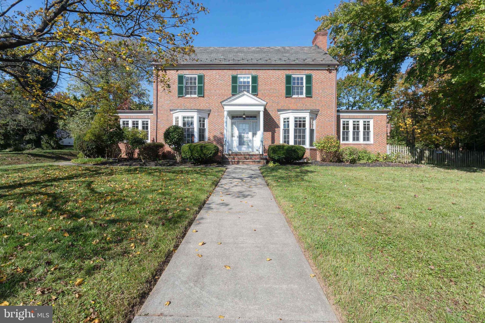 Amazing value in Homeland! Elegant classic brick center hall colonial features large rooms with beautiful moldings and ample natural light. A dining room with decorative fireplace is adjacent  to kitchen (an intermediary wall could be removed for large, modern kitchen/dining combo). Charming wood paneled office/library off dining room offers  perfect  work from home space. Huge living room with decorative (potential wood-burning) fireplace is adjacent to large tiled sunroom with French doors to large bluestone patio and flat fenced yard. Upstairs find a large bedroom suite with bathroom as well as and three additional bedrooms and a hall bath.  Third floor is an open bonus space that could be used as bedroom, playroom, or work/study space. Full basement features bar, half bath, laundry and ample storage. Generous closets, hardwood floors and many Pella double-paned windows throughout. Bathrooms and kitchen need some TLC, and the price reflects this, but this home has great bones and HUGE potential located close to schools and shopping and abutting two lanes that lead into charming North Homeland. Large parking pad and two car garage. Central Air. Mature plantings abound in well-landscaped yard and gardens.