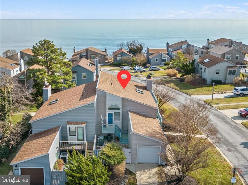 Have you been looking for a townhome close to the water? Want one that you do not have to upgrade yourself?  This is a great unit with a limited but beautiful water view! Redone with luxury appointments from Pottery Barn, gorgeous tile floors in bathrooms, redone kitchen with lovely back splash and two fireplaces! The wall from the kitchen from family room has been removed to achieve wide open spaces and a modern feel.  Granite and high end cabinetry give you a luxurious feel with newer stainless appliances.  Primary bedroom can be upstairs or downstairs with adjoining walk in closets with built-ins.  There is a deck off the living room with views of the bay , electric awning for when it gets hot and the perfect  place to watch the sunrise over the Bay! Custom blinds on all the windows, make it ready for you to move into right now! The lower level family room has a walk out patio that also has views of the Bay and easy entry directly into the unit from the back yard.  You will also have a one car garage that has two separate entrances from each side of the home.  Private stone patio is off the primary suite  and  is the perfect place for a small garden, hot tub or quiet outdoor retreat.   Corner lot offers you lots of windows and light into the home.  You do have a neighbor, but with the set back, you can see them from the decks and patios.  The community offers a place to launch a canoe into the Bay and a small private beach.  There are sidewalks and benches along the waters edge to enjoy upfront and personal views of the water.  This is a great get away retreat or vacation at home  located next to the Chesapeake Resort, Marinas, restaurants, North Beach Boardwalk, farmers markets and so much more!  Are you ready to spend the spring and summer by the water?  Don't wait!