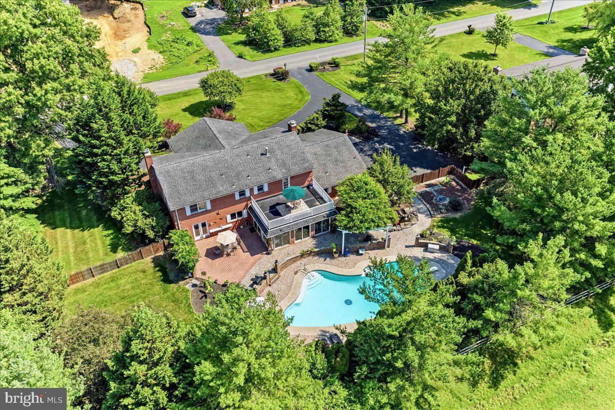 We're excited to announce that one of Delaware's exceptional luxury estate homes is returning to the market! Proudly designated as a RE/MAX Miracle Home, a portion of the seller's proceeds will benefit Children's Hospital of Philadelphia (CHOP) through Children's Miracle Network Hospitals®. Buyers are also invited to make an optional contribution at closing in support of local children's healthcare.
A rare opportunity to own a truly custom estate residence built by renowned Delaware builder R. C. Peoples for a member of his immediate family. Perfectly positioned beside the landmark Peoples family estate, this stately all-brick Georgian Colonial-inspired home combines timeless architecture, exceptional craftsmanship, and resort-style outdoor living. Commissioned for the builder's immediate family, the residence reflects a level of quality and craftsmanship rarely found in today's construction.
While preserving its original character and architectural integrity, the home benefited from a substantial renovation in 2009, highlighted by a comprehensive redesign of the gourmet kitchen and updates to several additional living spaces.
Approached by an expansive horseshoe driveway, the home makes an unforgettable first impression with its commanding two-story columned entrance, custom paver entry, and meticulously landscaped grounds. Inside, a dramatic two-story foyer welcomes guests with a sweeping quarter-turn staircase, elegant Italian marble flooring, rich ¾-inch Red Oak hardwood floors, and extensive custom millwork throughout.
At the heart of the home, the renovated gourmet kitchen offers custom cabinetry, granite countertops and backsplash with waterfall detailing, a three-tier island, under-cabinet lighting, built-in Bose speakers, and premium appliances including a Sub-Zero refrigerator, Viking wine chiller, JennAir ovens and cooktop, Bosch dishwasher, GE Advantium speed cooker, and Dacor warming drawer. The adjoining dining room features built-in china cabinets, a glass-paneled privacy door, and French doors leading to a secluded patio.
Designed for both entertaining and everyday comfort, the home offers a formal living room with a wood-burning fireplace and marble surround, a spacious family room with a Buck wood stove, raised brick hearth, decorative box-beam ceiling, and a stunning conservatory overlooking the rear grounds. Surrounded by panoramic views of the pool, gardens, patios, and mature landscaping, this light-filled retreat seamlessly connects the interior living spaces with the outdoors.
The luxurious primary suite features a walk-in dressing area, spa-inspired bath, gas fireplace, custom lighting, and a private rooftop terrace overlooking the pool and gardens. Secondary bedrooms are generously sized, including an oversized bedroom created by combining the original third and fourth bedrooms, which can easily be restored to a traditional four-bedroom configuration.
The resort-inspired backyard is anchored by a custom in-ground pool constructed by Swift Pools in 1999 and enhanced by extensive paver patios, retaining walls with accent lighting, a dedicated grilling station, a pergola shaded by mature flowering vines, and a multi-level waterfall and pond feature. Extensive hardscaping, mature landscaping, and multiple entertaining areas create a private oasis within the fully fenced rear yard. The finished lower level offers a pub-style wet bar, entertainment and gaming areas, custom library cabinetry, powder room, fitness or flex space, abundant storage, and expansion potential beneath the front entrance. Additional highlights include a Carrier hybrid HVAC system, dedicated laundry room, oversized turned two-car garage with epoxy flooring and attic storage, convenient garage-to-basement staircase access, and extensive owner parking. Luxury living with a purpose—an extraordinary Delaware estate that not only offers timeless elegance and resort-style amenities, but also supports the REMAX Miracle Home program.