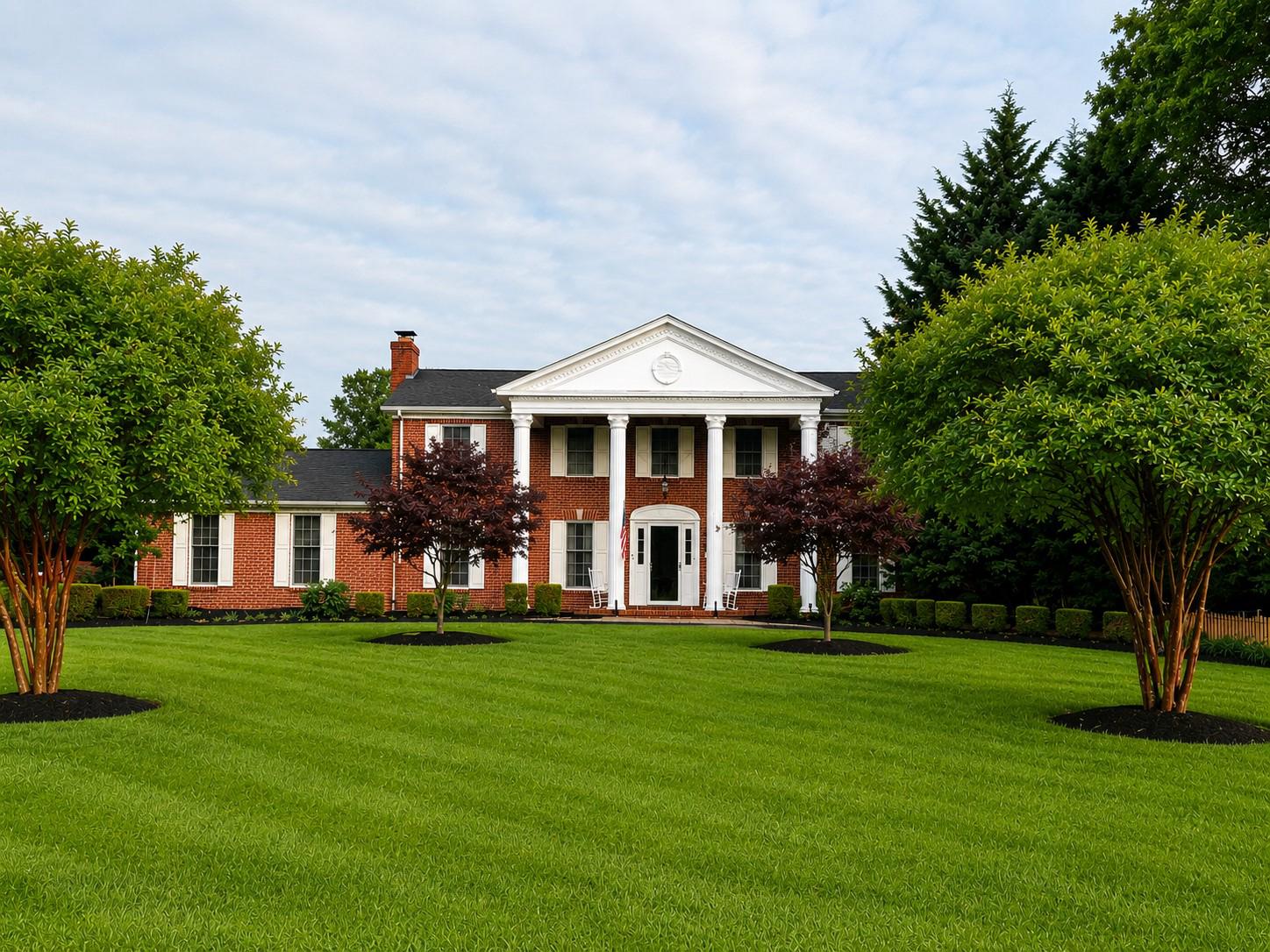 A rare opportunity to own a truly custom estate residence built by renowned Delaware builder R. C. Peoples for a member of his immediate family. Perfectly positioned beside the landmark Peoples family estate, this stately all-brick Georgian Colonial-inspired home combines timeless architecture, exceptional craftsmanship, and resort-style outdoor living. Commissioned for a member of the builder's immediate family, the residence reflects a level of quality and pride of craftsmanship rarely found in today's construction. While preserving its original character and architectural integrity, the home benefited from a substantial renovation in 2009, highlighted by a comprehensive redesign of the gourmet kitchen and updates to several additional living spaces. Approached by an expansive horseshoe driveway, the home makes an unforgettable first impression with its commanding two-story columned entrance, custom paver entry, and meticulously landscaped grounds. Inside, a dramatic two-story foyer welcomes guests with a sweeping quarter-turn staircase, elegant Italian marble flooring, rich ¾-inch Red Oak hardwood floors, and extensive custom millwork throughout. At the heart of the home, the renovated gourmet kitchen offers custom cabinetry, granite countertops, and backsplash with waterfall detailing, a three-tier island, under-cabinet lighting, built-in Bose speakers, and premium appliances including a Sub-Zero refrigerator, Viking wine chiller, JennAir ovens and cooktop, Bosch dishwasher, GE Advantium speed cooker, and Dacor warming drawer. The adjoining dining room features built-in china cabinets, a glass-paneled privacy door, and French doors leading to a secluded patio. Designed for both entertaining and everyday comfort, the home offers a formal living room with a wood-burning fireplace and marble surround, a spacious family room with a Buck wood stove, raised brick hearth, decorative box-beam ceiling, and a stunning conservatory overlooking the rear grounds. Surrounded by panoramic views of the pool, gardens, patios, and mature landscaping, this light-filled retreat provides a seamless connection to the outdoor living spaces. The luxurious primary suite features a walk-in dressing area, spa-inspired bath, gas fireplace, custom lighting, and a private rooftop terrace that offers a unique vantage point overlooking the pool and gardens below. Secondary bedrooms are generously sized, including an oversized bedroom created by combining the original third and fourth bedrooms, which can easily be restored to a traditional four-bedroom configuration. The resort-inspired backyard is anchored by a custom Swift Pools in-ground pool constructed in 1999 and enhanced by extensive paver patios, retaining walls with accent lighting, a dedicated grilling station, a pergola shaded by mature flowering vines, and a multi-level waterfall and pond feature. Extensive hardscaping, mature landscaping, and multiple entertaining areas create a private oasis within the fully fenced rear yard. The finished lower level offers a pub-style wet bar, entertainment and gaming areas, custom library cabinetry, powder room, fitness or flex space, abundant storage, and expansion potential beneath the front entrance. Additional highlights include a Carrier hybrid HVAC system, a dedicated laundry room, an oversized turned two-car garage with epoxy flooring and attic storage, convenient garage-to-basement staircase access, and extensive owner parking. This home is proudly designated as a RE/MAX Miracle Home. Through the RE/MAX Children's Miracle Network Hospitals® program, the seller will contribute a portion of the sale proceeds to support children and families served by the Children's Hospital of Philadelphia (CHOP), allowing the purchase of this exceptional property to make a meaningful impact beyond the closing table.
Combining architectural distinction, superior craftsmanship, and extraordinary indoor-outdoor living, this is a once-in-a-generation estate offering.