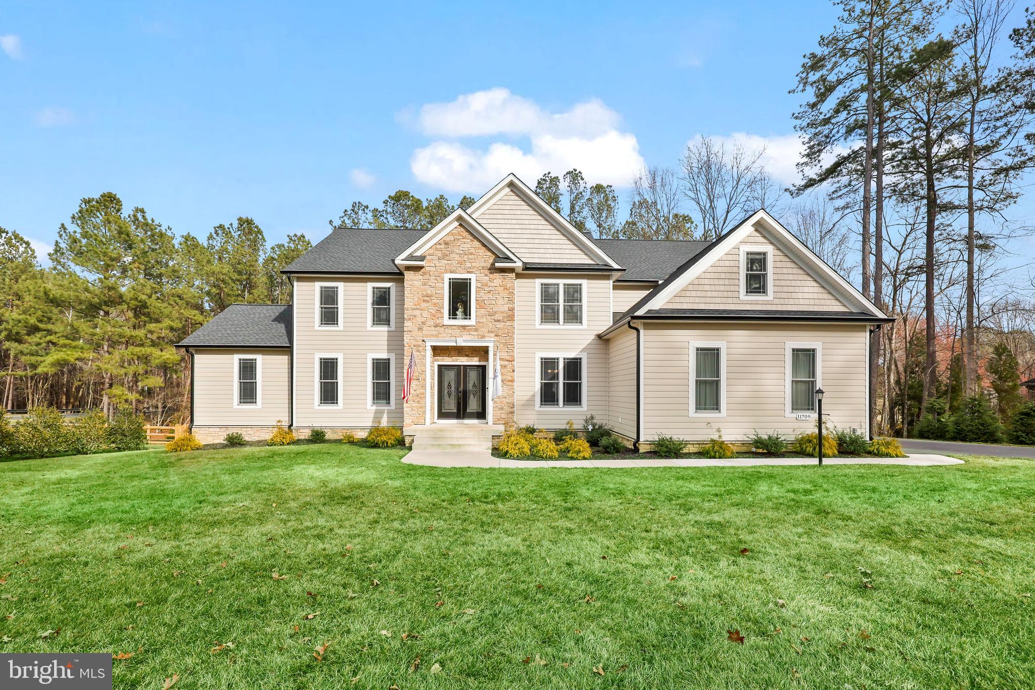 Welcome home to this two year old, custom-built home by JOHN ROBB Custom Homes in the desirable Fawn Lake Community. Luxury meets comfort in this 4200+ finished square feet home plus an additional 2200+ unfinished square feet in the basement. Stunning architecture and no details were overlooked in the craftsmanship of this home. Boasting elegant trim work and rounded corners throughout this inviting and extraordinary home. Situated perfectly on 1.44 acres, you are surrounded by mature landscaping with winter views of the lake and golf course.  You are first greeted by the two story foyer, elegant LVP flooring, and tons of natural light. Entertain and relax in the front sitting room and dining room where there is plenty of room for family and friends. The two story family room draws you in with it's coffered ceiling with modern light fixture, floor to ceiling stone fireplace, and magnificent views of the tree lined backyard. The chef-inspired kitchen features quartz countertops, upgraded cabinetry with soft close drawers and lighting underneath the cabinets, dual wall ovens, six burner gas cooktop with griddle and a wall mounted pot filler above it, side by side column refrigerator and freezer, farmhouse sink, built-in wine fridge, an island that seats four comfortably, walk-in pantry with pocket doors, and kitchen table space with continued views of the backyard and access to the deck for grilling and entertaining. One of the homeowner's favorite areas is the new enclosed sunroom with a mini-split and two flush mount ceiling fans that allow you to enjoy this room year round. Walkout on the 30 foot long deck from here to continue the peacefulness of the area. There are two bedrooms on the main level that are connected by a full bathroom. This makes for a great guest suite or for anyone who doesn't want to use the stairs. A laundry room with a dog shower area  and half bathroom complete the main level. Make your way to the upper level where there are four generous-sized bedrooms including the magnificent primary bedroom suite. This is your personal retreat with a spacious sitting area, an envious size walk-in closet and another closet perfect for shoes! This primary bathroom is your spa-like experience. The frameless, walk-in shower has dual shower heads, the garden tub sits perfectly with a picture window allowing in the natural light. One of the other bedrooms has its own ensuite bathroom and views of the backyard. The other two bedrooms are connected by a Jack and Jill bathroom. Looking for more room to expand? The unfinished basement is ready for you to finish the way you like - an egress window for a future bedroom, roughed-in for a future full bathroom, wet bar or kitchenette, and another laundry hookup. Currently, it makes for a convenient gym. Walkout on the patio for more areas to relax. This opens up to the fenced-in backyard that has two double gates on either side of the house and a single gate at the rear, which provides access to the creek and the remaining portion of the property on the other side of the creek. The backyard has tons of room for backyard activities including a future pool. The property goes past the rear fence and includes a resource protection area. Three car garage with huge driveway.  NEW improvements include the enclosed sunroom, whole house generator, solar panels, and rear fencing. There are even outlets in the soffits so you can hang your holiday lights! Irrigation system keeps your yard looking beautiful! The builder's structural warranty is transferable to the new owner. Fawn Lake is rich in it's amenities including the lake and marina, Arnold Palmers' designed golf course, clubhouse with pool, fitness center, and so much more. Welcome to Fawn Lake living!