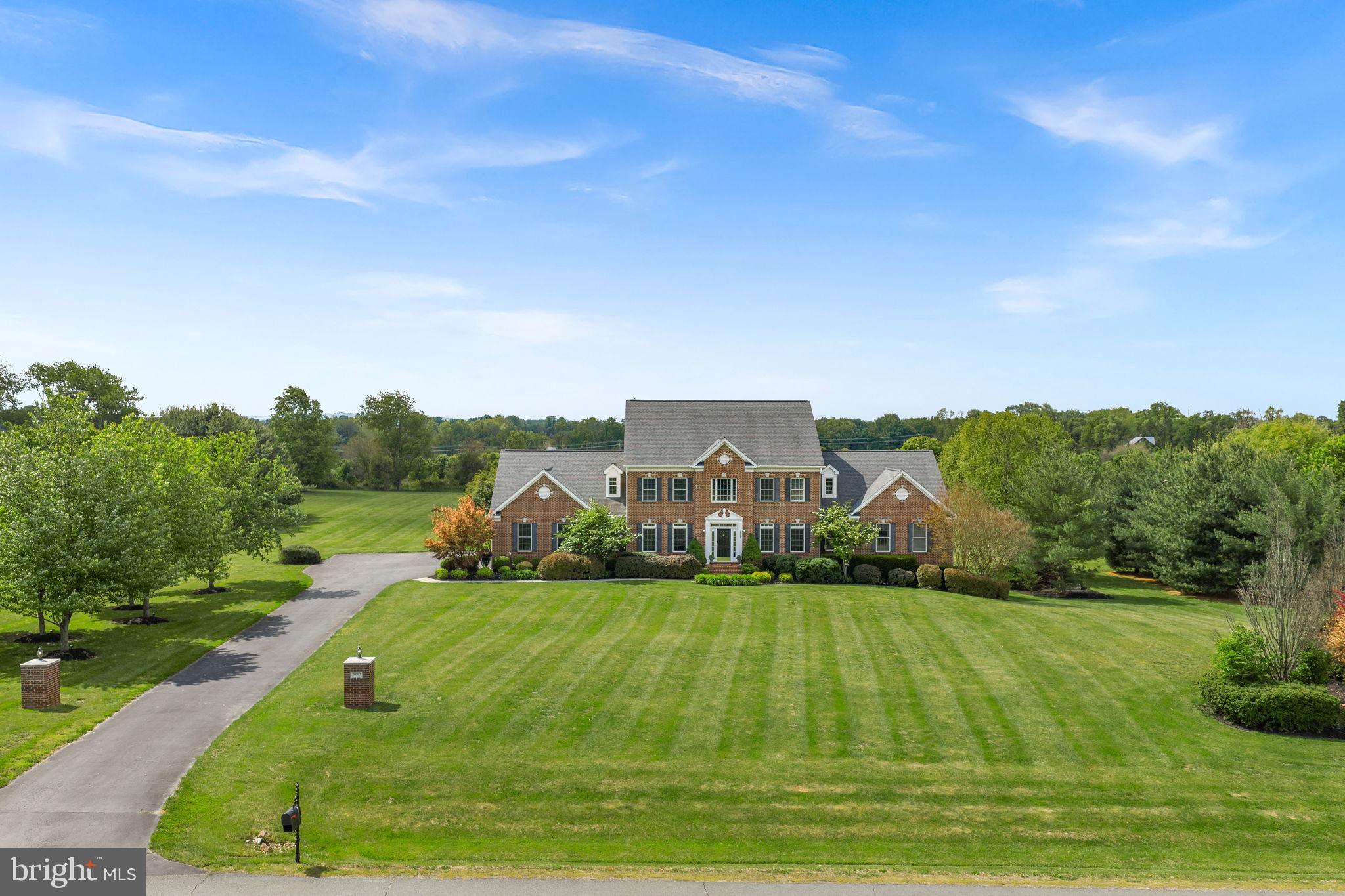 *OPEN SAT 6/13 & SUN 6/14, 1-3PM* Experience the perfect balance of refined country living and modern convenience at this exceptional estate nestled on three private acres in the heart of Western Loudoun County. Surrounded by sweeping views of open fields and rolling countryside, this stunning residence offers a lifestyle that feels worlds away while remaining just minutes from everything you need. 

Thoughtfully designed for both elegant entertaining and comfortable everyday living, the home features a luxurious main-level primary suite, offering a private retreat with serene views and easy accessibility. A dedicated home office provides the ideal work-from-home space, supported by high-speed FIOS or Xfinity internet.

The heart of the home is anchored by a spectacular two-story family room featuring a cozy fireplace and soaring ceilings that create an impressive sense of space and light. Seamlessly connected to the family room is the expansive gourmet kitchen, thoughtfully designed for gathering and entertaining. A generous center island provides ample prep space and seating, while the spacious eat-in dining area offers the perfect place for casual meals, morning coffee, or hosting family and friends. Just off the kitchen, a large mudroom is both beautiful and functional, with a washer, dryer and featuring abundant upper and lower cabinetry, and storage to keep everyday life organized.

Natural light fills the home's inviting living spaces, including a beautiful enclosed sun porch where walls of windows frame picturesque views of the surrounding countryside and changing seasons.

Upstairs, four generously sized bedrooms and two full baths provide abundant space for family and guests. A second washer and dryer on the upper level adds exceptional convenience, making daily living effortless for busy households and overnight visitors alike.

The walk-out lower level is designed for entertaining, complete with a stylish wet bar featuring a refrigerator and dishwasher, creating the perfect setting for game days, celebrations, or relaxed evenings with friends. Two versatile bonus rooms offer endless possibilities for a home gym, media room, hobby space, guest accommodations, or additional office space. An expansive unfinished storage area provides abundant room for seasonal décor, recreational equipment, and long-term storage needs. 

From the lower level, step outside to a private patio that leads to the crown jewel of the property—a spectacular pool surrounded by lush landscaping and breathtaking countryside views. Additional enclosed storage is located under the porch with easy access for mowing and yard tools as well as pool equipment. Whether hosting summer gatherings, enjoying sunset swims, or unwinding beneath the stars, this outdoor oasis offers resort-style living right at home.

This home offers peace of mind with recent improvements, including a roof replacement and upgraded downspouts (2018), new carpet on the entire upper level and office (2026), an epoxy resurfaced patio (2025), cooktop (2026), refrigerator (2024) and newer heat pump, main level washer, dryer and dishwasher.

Backing to open fields, enjoy breathtaking sunsets, peaceful pastoral views, and the rare privacy that comes from owning acreage in one of Loudoun County's most sought-after locations. Enjoy exceptional convenience with Route 7 just minutes away, downtown Purcellville's charming shops, restaurants, breweries, and wineries within easy reach, grocery stores and daily conveniences less than five minutes from home, access to Leesburg within 15 minutes and Dulles International Airport approximately 30 minutes away.

Rarely does a property offer this combination of luxury, privacy, acreage, breathtaking views, exceptional indoor and outdoor living spaces, and commuter-friendly convenience. This is more than a home—it's a lifestyle defined by space, sophistication, and the timeless beauty of Western Loudoun County.