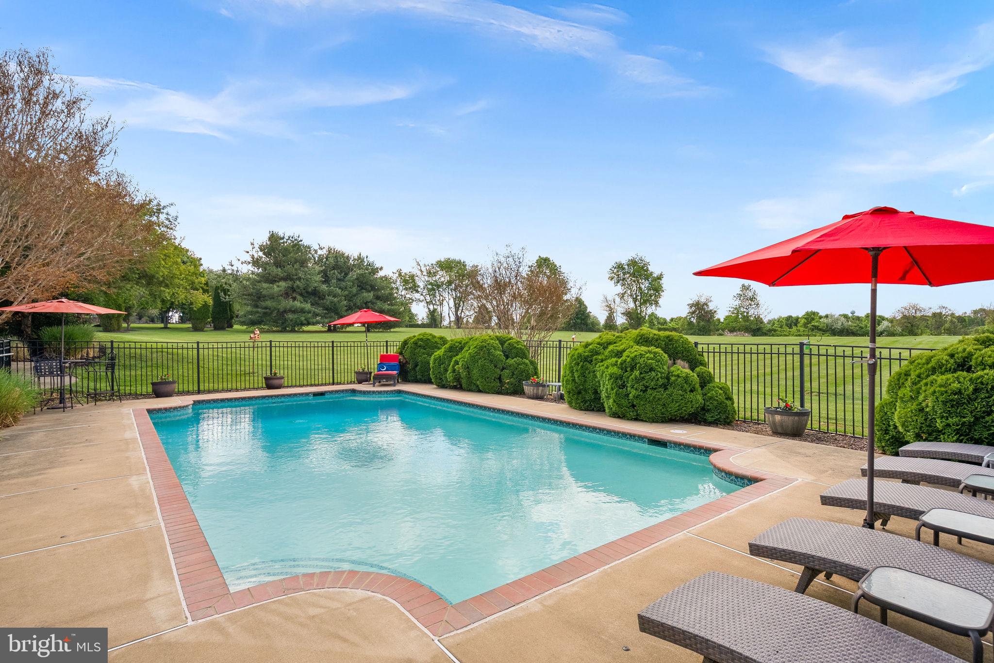 *OPEN SAT 6/13 & SUN 6/14, 1-3PM* Experience the perfect balance of refined country living and modern convenience at this exceptional estate nestled on three private acres in the heart of Western Loudoun County. Surrounded by sweeping views of open fields and rolling countryside, this stunning residence offers a lifestyle that feels worlds away while remaining just minutes from everything you need. 

Thoughtfully designed for both elegant entertaining and comfortable everyday living, the home features a luxurious main-level primary suite, offering a private retreat with serene views and easy accessibility. A dedicated home office provides the ideal work-from-home space, supported by high-speed FIOS or Xfinity internet.

The heart of the home is anchored by a spectacular two-story family room featuring a cozy fireplace and soaring ceilings that create an impressive sense of space and light. Seamlessly connected to the family room is the expansive gourmet kitchen, thoughtfully designed for gathering and entertaining. A generous center island provides ample prep space and seating, while the spacious eat-in dining area offers the perfect place for casual meals, morning coffee, or hosting family and friends. Just off the kitchen, a large mudroom is both beautiful and functional, with a washer, dryer and featuring abundant upper and lower cabinetry, and storage to keep everyday life organized.

Natural light fills the home's inviting living spaces, including a beautiful enclosed sun porch where walls of windows frame picturesque views of the surrounding countryside and changing seasons.

Upstairs, four generously sized bedrooms and two full baths provide abundant space for family and guests. A second washer and dryer on the upper level adds exceptional convenience, making daily living effortless for busy households and overnight visitors alike.

The walk-out lower level is designed for entertaining, complete with a stylish wet bar featuring a refrigerator and dishwasher, creating the perfect setting for game days, celebrations, or relaxed evenings with friends. Two versatile bonus rooms offer endless possibilities for a home gym, media room, hobby space, guest accommodations, or additional office space. An expansive unfinished storage area provides abundant room for seasonal décor, recreational equipment, and long-term storage needs. 

From the lower level, step outside to a private patio that leads to the crown jewel of the property—a spectacular pool surrounded by lush landscaping and breathtaking countryside views. Additional enclosed storage is located under the porch with easy access for mowing and yard tools as well as pool equipment. Whether hosting summer gatherings, enjoying sunset swims, or unwinding beneath the stars, this outdoor oasis offers resort-style living right at home.

This home offers peace of mind with recent improvements, including a roof replacement and upgraded downspouts (2018), new carpet on the entire upper level and office (2026), an epoxy resurfaced patio (2025), cooktop (2026), refrigerator (2024) and newer heat pump, main level washer, dryer and dishwasher.

Backing to open fields, enjoy breathtaking sunsets, peaceful pastoral views, and the rare privacy that comes from owning acreage in one of Loudoun County's most sought-after locations. Enjoy exceptional convenience with Route 7 just minutes away, downtown Purcellville's charming shops, restaurants, breweries, and wineries within easy reach, grocery stores and daily conveniences less than five minutes from home, access to Leesburg within 15 minutes and Dulles International Airport approximately 30 minutes away.

Rarely does a property offer this combination of luxury, privacy, acreage, breathtaking views, exceptional indoor and outdoor living spaces, and commuter-friendly convenience. This is more than a home—it's a lifestyle defined by space, sophistication, and the timeless beauty of Western Loudoun County.