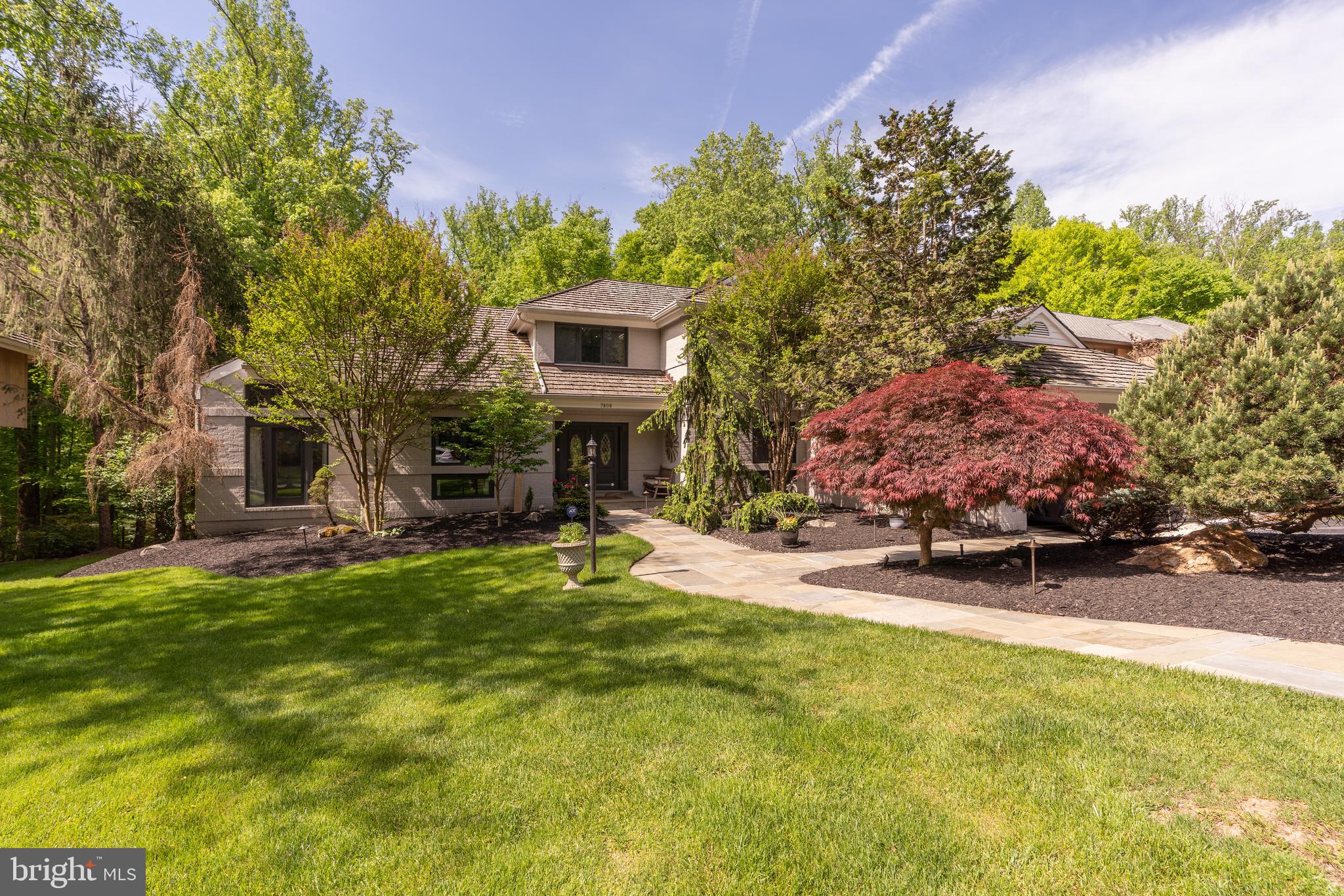 Nestled within the scenic beauty of Fawcett Farms Manor, this contemporary gem boasts over 5200 square feet of luxurious living space on three levels. Built in 1985 on a generous 16,679 square foot lot, this home is a harmonious blend of modern comfort and natural tranquility.
Upon entering, you're greeted by an expansive and light-filled interior with a stunning view of the woods beyond the property. The renovated kitchen is a chef's dream, featuring stone countertops, top-of-the-line appliances, and ample storage space. It seamlessly flows into the dining area, perfect for hosting gatherings and creating lasting memories.  Ease of living with the laundry/mudroom right off of the kitchen and into the garage with the Tesla charger.
The living spaces are designed with both relaxation and entertainment in mind. The living room with the dramatic fireplace and doors to the deck, is the perfect spot to entertain family and friends. A spacious family room with panoramic views of the wooded backyard offers custom surround sound and built-in bookshelves, making it an ideal spot to enjoy movie night or curl up with a book. Floor-to-ceiling windows throughout the home bring the outdoors in, creating a seamless connection to nature.
The main level primary suite is a retreat unto itself, offering a private sanctuary complete with a spacious bath and two walk-in closets.  The second main level bedroom is also ensuite with sylvan views of the backyard.  The upper level offers a third bedroom, renovated bathroom and light-filled home office or guest room.
The lower level provides two additional bedrooms, full bathroom and the perfect layout for entertaining.  Enjoy watching the big game, hosting friends at the custom built-in bar or spend time on the patio with the hot tub or in the cabana area.
The backyard is a true oasis, featuring a heated saltwater pool surrounded by lush landscaping. Whether lounging poolside on sunny days or hosting summer barbecues, this outdoor space is designed for both relaxation and entertainment.