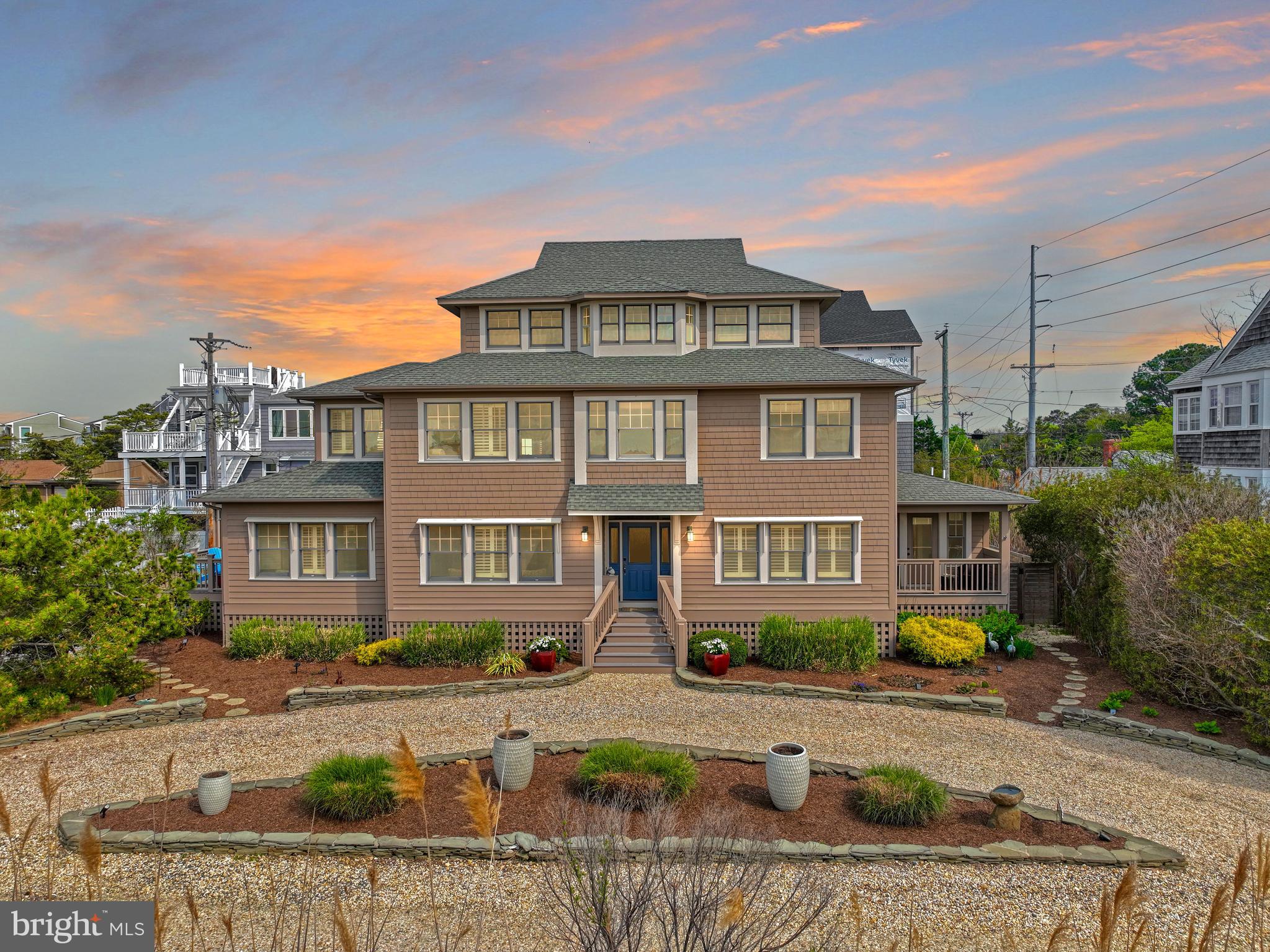 Welcome to this stunning 4,000 sq ft custom home, masterfully crafted by renowned builder Phillip Bradley and artfully designed by acclaimed architect John Mateyko. Perfectly positioned between the Atlantic Ocean and Rehoboth Bay, this extraordinary residence sits on an oversized, low-maintenance lot, offering sweeping views of the marsh and bay, with DEEDED BAY ACCESS, and just 1.5 blocks to the Ocean!
Refined yet relaxed, the home blends timeless coastal charm with sophisticated modern living. The chef’s gourmet kitchen is a culinary masterpiece, featuring rich marble countertops, Ann Sacks sophisticated blue glass tile backsplash, top-of-the-line KitchenAid stainless steel appliances, including two ovens, 2 refrigerators,  a food warming drawer, three dishwashers, and a spacious walk-in marble pantry that doubles as a fortified safe room.
Enjoy relaxed dining on the screened porch or sip wine on the expansive deck while taking in breathtaking sunsets. The interior offers generous space for both entertainment and privacy, with a whole-house integrated music system, four beautifully appointed bedrooms, including an owner’s suite featuring a gas fireplace and sitting area, with stunning panoramic views of the water and coastal migratory birds. Host guests or relax in style across the inviting family room with gas fireplace, dining room, private den/media room, and enclosed porch with motorized retractable vinyl screens and a mahogany beadboard ceiling.
Work from home in absolute tranquility from the third-floor office wing, which features three private office spaces and a conference room area with 10’ ceilings, all capturing spectacular bay vistas. After sun-soaked days on the water, refresh in your private outdoor shower or unwind in the custom sauna.
Luxury finishes and structural integrity are found throughout, including Brazilian Koa hardwood floors, marble surfaces, high-quality wood plantation blinds throughout the house, a steam shower, a heated bathroom floor, a built-in makeup station with salon hairstyling drawer, and an elevator servicing all three levels. Designed for peace of mind, the home is clad in cedar siding, fitted with Andersen impact-resistant glazed windows and doors, and engineered to withstand winds up to 120 MPH. The safe room is built to endure Category 4 hurricanes. And the home is elevated 2 ft. above the 100-year flood elevation.
This is more than a home—it is a rare opportunity to own an iconic coastal sanctuary where luxury meets resilience, and every detail has been meticulously crafted.