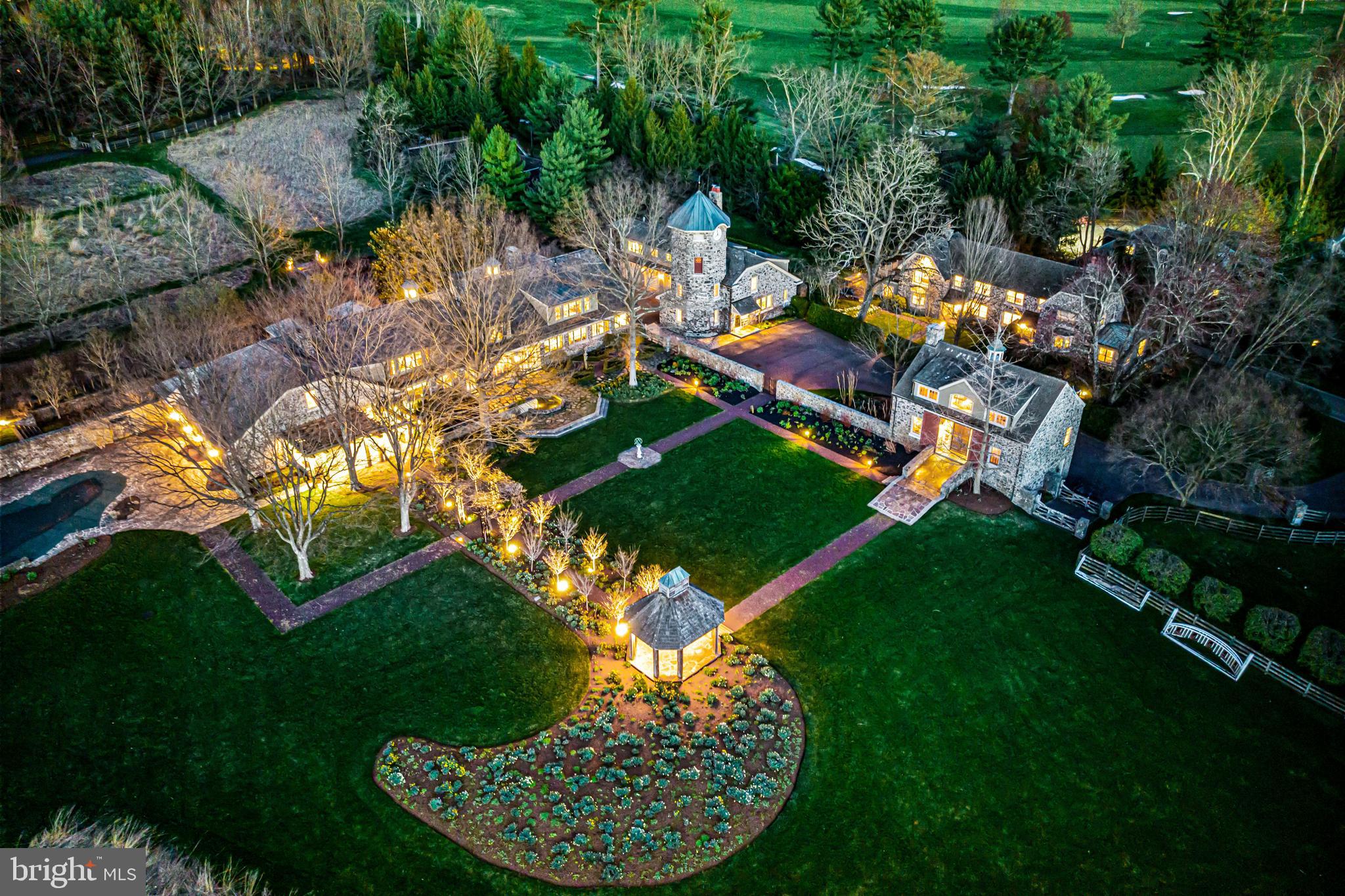 Offering complete privacy, timeless sophistication and endless views, this 17-acre estate, just 30 minutes from Philadelphia and 90 minutes from New York City, was once a prized piece of Ardrossan, the most extraordinary estate on Philadelphia's esteemed Main Line. Now known as Albermarle, this collection of masterfully and recently restored and expanded English-style stone buildings was painstakingly reimagined and created by Pinemar Construction over a 3-year period, 2003-2006, and is set behind a gated entry across from Overbrook Country Club in Villanova. An additional extensive list of recent improvements was also completed this past year. The sun-filled main residence, charming guest houses entertainment barn, pool and tennis court, effortlessly serve as fabulous living and gathering spaces while the original clock tower building efficiently functions as a well-outfitted, high-tech business headquarters with multiple offices, kitchen, 2 bathrooms and board rooms. Every piece of the estate has been fine-tuned for today s lifestyles and is complemented by Chuck Gale s picturesque hardscaping and landscaping with vista views of conservancy land and private hiking trails. Importantly, this hidden world, located in a prime ZIP code, is just minutes from renowned public and private educational institutions, world class golf , equestrian and endless recreational facilities, fabulous dining, shopping and much more.   Inside the main house, which was originally constructed to serve as a 40-horse barn for the 1920's Col. Robert Montgomery Estate,  the expansive open floor plan showcases a breathtaking foyer with stone fireplace and glimpses of the properties views, generously proportioned living room with glorious vistas and stone fireplace, stunning dining room with beautiful built-ins and a wall of windows,  great room with vaulted ceiling, hand crafted beam detail, wet bar and access to a custom wine room, an incredible custom-designed eat-in chef s kitchen with professional appliances, large working island and breakfast room with fireplace, richly paneled office with cozy fireplace, an expansive first floor guest suite with flexible adjacent bonus room, sun-filled laundry room and 2 custom tiled powder rooms. Plentiful windows and French doors embrace the exceptional setting and allow for indoor-outdoor flow to the wrap around flagstone terraces, gardens, pool area, tennis court and secondary buildings.  Additional bedrooms are located on the second floor and include an incredible primary suite with entrance foyer, his and hers walk-in dressing rooms and a sumptuous marble bathroom, two additional en- suite bedrooms and an wonderful second floor office, offering a total of 4-6 bedrooms within the main residence. The charming stone guest house, set up as a twin and fully updated with two separate and complete living spaces, provides four additional bedrooms. The clock tower offices, also fully renovated and restored, including the timepiece mechanics in the tower, now house a reception area, two executive offices, three additional offices, board room with video/large screen equipment, Cat-5 wiring, kitchen, two full baths and four oversized garage bays. For entertaining, the newly rebuilt, all-season stone bank barn has it all: game/media areas, wet bar, fitness space on the upper level and two bathrooms. This building also offers three additional parking bays for a total of seven on the property. Plan on warm-weather entertaining by the pool, where its lounge area and fireplace are seamlessly integrated into the impeccably designed hardscaping, with breathtaking views. For the buyer seeking a complete, turnkey residence, catering to the ultimate setting for generational family life, business and entertaining, within walking distance to golf and country club facilities, along with a legacy property that offers an exclusive heritage, look no further than the Main Line's Albermarle.