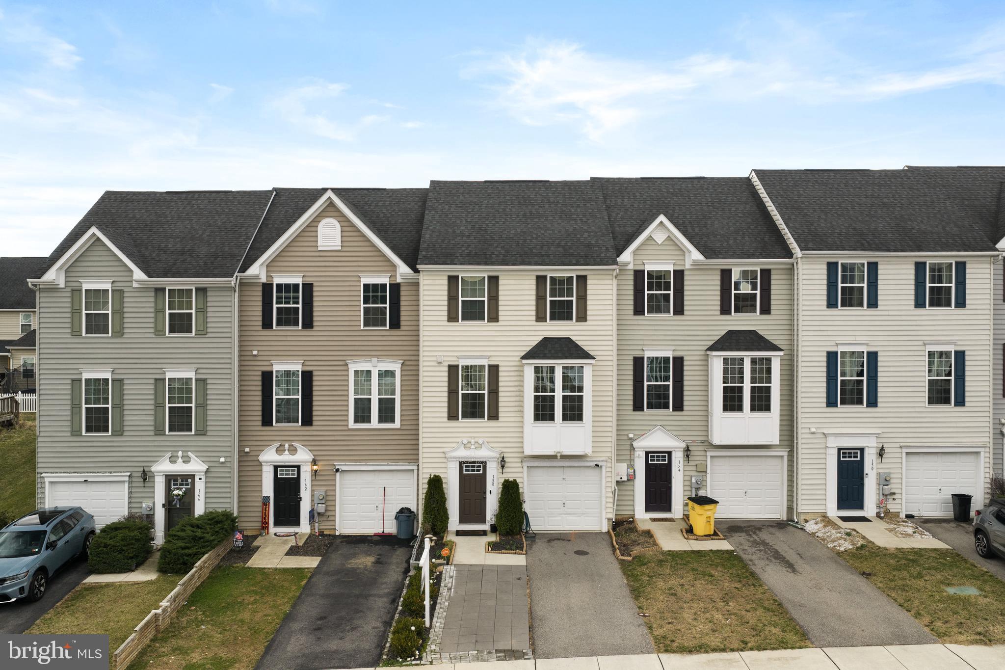 Looking for space without the price tag of a single-family home? This rare 4-bedroom townhome at 158 Norwood Drive in beautiful Falling Waters, WV offers the room and flexibility many buyers are searching for. Built in 2016, this home features 4 bedrooms, 3 full bathrooms, and 1 half bath, with the added convenience of a bathroom on every level of the home. The entry level welcomes you with access to the spacious garage and a large fourth bedroom complete with an egress window, walk-in closet, and en suite bathroom with a shower. This space also offers flexibility and could easily serve as a second family room, recreation room, or guest suite. The main level features an open-concept kitchen with real hardwood floors, a large center island and peninsula, stainless steel appliances, a spacious pantry, and a dining area with a sliding glass door that leads to the fully fenced backyard. Just off the kitchen is a comfortable family room equipped with surround sound, creating a great space for everyday living or entertaining guests. Upstairs, the primary suite includes a walk-in closet and an en suite bathroom with dual vanities and a walk-in shower. Two additional bedrooms, another full bathroom, and a conveniently located laundry area complete the upper level. Step outside to enjoy the fully fenced backyard with a patio, perfect for pets to roam, kids to play, or relaxing evenings with friends and family. Conveniently located near I-81, shopping, restaurants, medical offices, and schools, this home offers a great balance of convenience and peaceful living. Schedule your showing today and come see everything this home has to offer.