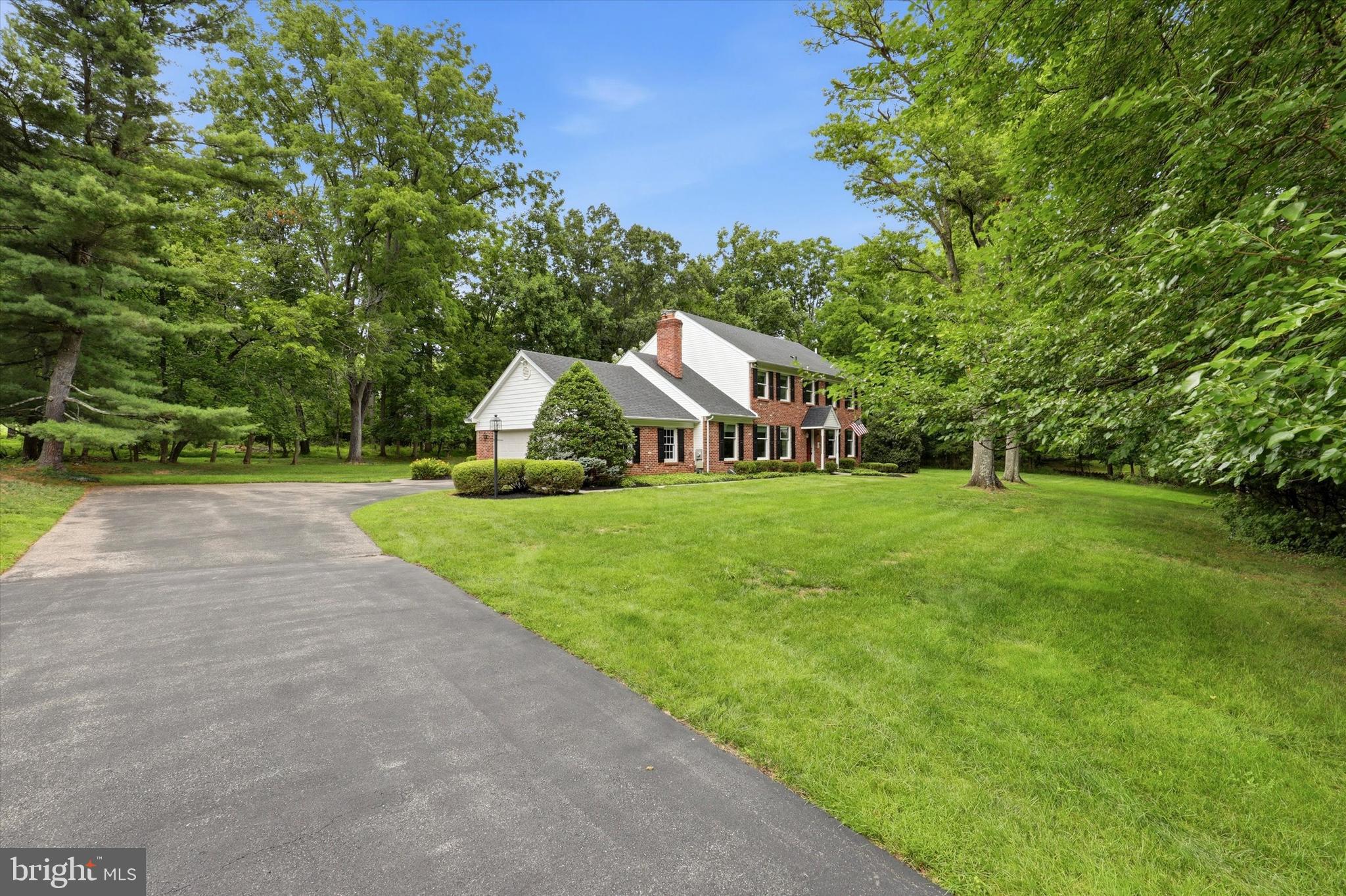 Discover this timeless Sweeney-built, 4-bedroom, 2.5-bath brick Colonial, gracefully situated on an expansive 1.8-acre lot in one of Lewis Lane's most coveted settings, known for its distinctive custom homes. Tucked away on a private two-home lane, this exceptional property offers a rare combination of privacy, space, and an unbeatable location. Inside, a classic center hall floor plan showcases rich hardwood floors, elegant crown molding, spacious formal living and dining rooms, and a bright eat-in kitchen. The inviting family room provides the perfect gathering space, while a convenient first-floor laundry/mudroom and powder room add everyday functionality. Upstairs, the generous primary suite features a large walk-in closet and a private bath, offering an excellent opportunity to create a luxurious retreat tailored to your style. Three additional spacious bedrooms, each with ample closet space, share a well-appointed hall bath. The fully waterproofed basement provides outstanding potential for future finished living space, whether you envision a recreation room, home gym, office, or media room. Step outside to a beautiful flagstone patio overlooking the peaceful, tree-lined backyard—an ideal setting for relaxing or entertaining while enjoying the property's exceptional privacy. Adding even greater value, the home's major mechanical systems have already been updated, including the roof, siding, windows, heating and air conditioning systems, and hot water heater. With these significant improvements already complete, you can focus on the exciting opportunity to personalize the interior and make this home your own. Located in the highly sought-after Wissahickon School District and just minutes from the shops, restaurants, and train station in downtown Ambler, this is a rare opportunity to own a solidly built home with outstanding bones, a premier location, and endless potential.