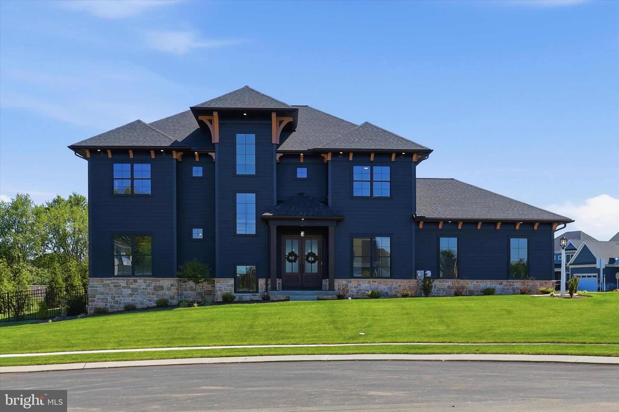 Exceptional luxury living in the heart of East Petersburg. Fall in love from the curb with this stunning modern masterpiece, where dramatic black LP Smart siding, rich stained wood accents, black-clad windows, and timeless architectural design create an unforgettable first impression. This like-new residence offers over 4,625 square feet of meticulously designed living space with a level of craftsmanship, design, and detail rarely found in today’s market — and even more rarely found in a completely move-in ready home. Ideally situated in one of Lancaster County’s most convenient and desirable locations, this extraordinary property blends timeless architecture with sophisticated modern finishes and advanced smart-home technology. Skip the 9+ month wait of building new construction while still enjoying the character, quality, and high-end finishes typically reserved for custom-built homes. An incredible value considering the extensive upgrades, premium materials, and luxurious features throughout. The dramatic exterior is complemented by a welcoming front porch and beautifully designed 3-car side-load garage. Every element of the home was carefully curated to create lasting elegance and exceptional curb appeal. Inside, soaring spaces filled with natural light create an atmosphere of warmth and refinement. The grand foyer opens to an expansive open-concept layout featuring impressive 10-foot ceilings throughout the main floor and second floor — a rare and luxurious feature that enhances the home’s spacious feel throughout every level. Designed for both elevated entertaining and everyday luxury living, the centerpiece of the home is a magazine-worthy chef’s kitchen featuring an impressive 10-foot quartz island, upgraded professional-grade appliances, custom cabinetry, herringbone glass tile backsplash, walk-in pantry, designer finishes throughout, and a stunning wet bar complete with a wine fridge and custom wine storage. The kitchen flows seamlessly into the dining area, sunroom, and dramatic great room anchored by a sleek 42-inch linear fireplace. Luxury and technology coexist effortlessly throughout the home. Integrated smart-home enhancements include surround sound, recessed TV wall systems, Wi-Fi ceiling access points, smart first-floor lighting, and automatic remote-operated window shades throughout the residence. A private first-floor study behind French doors provides an elegant workspace or quiet retreat. Hardwood flooring extends throughout both the first and second floors, reinforcing the home’s upscale and cohesive design aesthetic. The luxurious owner’s suite serves as a true retreat, highlighted by a tray ceiling, expansive walk-in closet, and spa-inspired bath featuring a massive custom tiled shower and premium finishes. Three additional generously sized bedrooms and two additional full bathrooms provide exceptional comfort and flexibility.
The fully finished daylight lower level dramatically expands the living space with luxury vinyl plank flooring, a spacious family room, full bathroom, abundant natural light, and extensive storage space — all accessed by a stunning open staircase from the main living area. Outdoor living is equally impressive. The private fenced backyard was thoughtfully designed for entertaining and relaxation, featuring a covered patio, custom outdoor kitchen, and elegant black metal fencing that perfectly complements the home’s architecture and finishes. A truly one-of-a-kind Lancaster County residence offering luxury, sophistication, and exceptional attention to detail at every turn. CALL TODAY TO SCHEDULE YOUR PRIVATE TOUR!