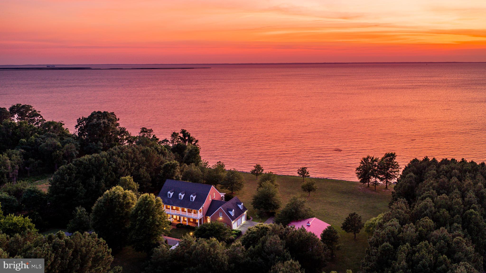 8781 Tilghman Island Road presents a rare opportunity to own a custom-designed, Daffin-built Chesapeake Bay estate set on 21±acres between historic St. Michaels and Tilghman Island. Constructed with a timeless brick exterior and encompassing approximately 6,500± square feet, this five-bedroom, five-and-a-half-bath residence was thoughtfully designed to embrace its extraordinary waterfront setting, where expansive Chesapeake Bay views and unforgettable western sunsets become part of everyday life. The home's classic architecture is highlighted by stacked waterfront porches, a spacious front balcony, and walls of windows that capture panoramic views from nearly every principal room. Two gas fireplaces add warmth to the generous living spaces, while abundant storage and a thoughtful floor plan provide comfort and functionality for both everyday living and entertaining. The main level is anchored by a spacious waterfront primary suite featuring a walk-in closet, oversized water closet, an en-suite bath with a tile walk-in shower and a separate tub, and a private enclosed porch overlooking the Bay. Upstairs, three generously sized en-suite bedrooms offer exceptional accommodations. Two bedrooms open to the front balcony, while the waterfront suite enjoys direct access to the upper waterfront porch. The third floor offers an additional en-suite bedroom along with a versatile bonus room ideal as a home office, craft room, playroom, fitness space, or additional storage. Outside, approximately 662± feet of riprapped Chesapeake Bay shoreline frames the property, while mature trees create a beautiful natural setting. Approximately four acres lie outside of the agricultural assessment, with the remaining acreage benefiting from agricultural tax status. Positioned along the Eastern Bay Water Trail, the property offers experienced kayakers direct access to one of the region's premier paddling routes and the opportunity to explore the Chesapeake Bay from your own shoreline. A detached garage offers exceptional flexibility and could serve as a future pool house, workshop, studio, or, where permitted, guest accommodations.
The home is equipped with five-zone heat pumps with central air conditioning, along with separate ductless HVAC systems serving both waterfront porches and the detached garage, providing year-round comfort throughout the property. Combining quality craftsmanship, a premier Chesapeake Bay location, and over 21± acres of land, this exceptional waterfront estate offers an increasingly rare opportunity to enjoy privacy, space, and some of the Eastern Shore's most spectacular sunset views.