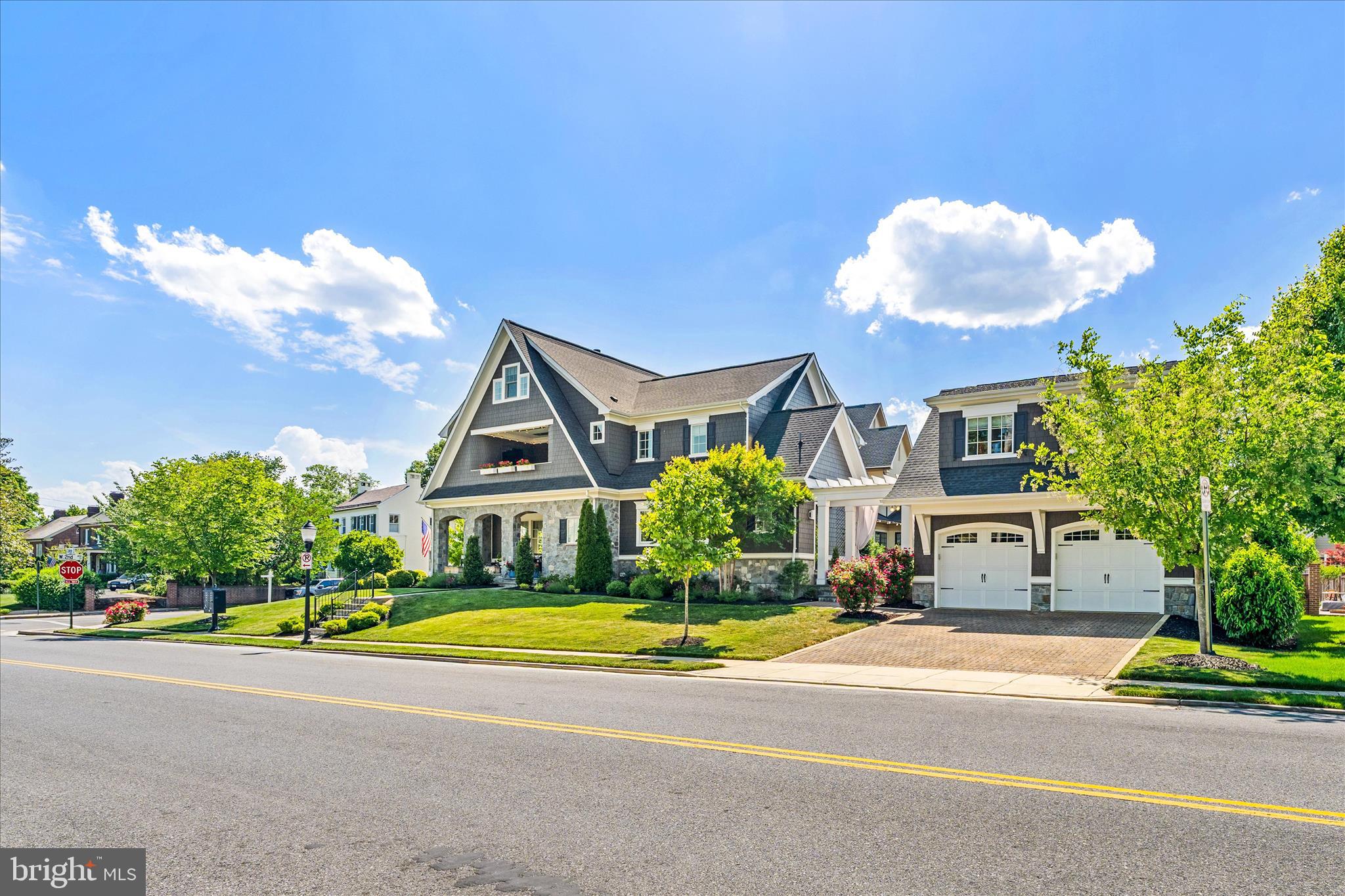 Positioned prominently within the prestigious Baker Park Estates, this extraordinary custom-built residence offers a rare opportunity to own one of Downtown Frederick’s most architecturally significant homes. Perfectly situated directly across from Baker Park on a beautifully landscaped corner lot, this remarkable property blends timeless craftsmanship with elevated modern luxury. Uniquely designed by renowned Jonathan Rivera Architecture and professionally curated by White Space Design Group, every detail of this exceptional residence was intentionally selected to honor the character and charm of Frederick’s historic architecture while seamlessly incorporating sophisticated modern finishes. As the only home featuring two front elevations and a private driveway accessed directly from the front of the property, the home offers a truly distinguished presence from every angle.  Inside, the home unfolds with warmth, sophistication, and impeccable craftsmanship. The main level features soaring 10-foot ceilings, elegant crown molding, custom millwork, solid wood doors, and stunning 5-inch white oak hardwood flooring. Oversized Andersen windows flood the home with natural light while framing picturesque views of Baker Park.The gourmet chef’s kitchen is a true showpiece. Anchored by an expansive quartz waterfall island, the space is outfitted with premium Thermador stainless steel appliances including a six-burner range with griddle, dual ovens, drawer microwave, professional hood, and an abundance of custom cabinetry. A hidden Murphy-door pantry, butler’s pantry, spacious mudroom, complete with a dog washing station and dedicated elegant home office add exceptional functionality and convenience.The great room offers a welcoming refined atmosphere centered around a wood-burning fireplace with gas conversion capability, while seamless access to multiple covered outdoor living spaces creates the perfect setting for entertaining year-round. The expansive entrance hall is pure drama and elegance with round landing table space and the chandelier dreams are made of featuring hundreds of perfectly cut crystals! The second level continues the home’s luxurious design with four spacious bedrooms, three full bathrooms, an oversized laundry room, and a thoughtfully designed wet bar complete with refrigerator and pantry. The owner’s suite serves as a private retreat featuring two walk-in closets and a spa-inspired bath with heated floors, dual vanities, soaking tub, Roman shower with bench seating. The heated covered balcony overlooking Baker Park, offering an extraordinary place to enjoy peaceful sunrise views all year round.The finished third-floor loft provides flexible space ideal for a second office, media room, playroom, or guest retreat.The fully finished lower level was designed with wellness and recreation in mind, featuring a state-of-the-art heated yoga studio with imported Japanese sliding glass doors, expansive changing room with double vanities and dual showers, a second kitchen, spacious recreation room, full bathroom, walkout access, and additional storage space.The detached two-car garage includes an electric vehicle charging outlet and is accompanied by a beautifully appointed private guest house complete with a kitchen, bedroom, bathroom, washer and dryer, and private outdoor patio beneath a charming pergola — ideal for guests, multigenerational living, an au pair suite, or private office. Outside, professionally designed landscaping by Stadler Nursery surrounds the property with lush greenery, while integrated stormwater management systems, permeable pavers, pergolas, and multiple  gathering areas complete this truly one-of-a-kind offering. Located just moments from Frederick’s award-winning restaurants, boutiques and, entertainment, while directly adjacent to Baker Park’s trails, tennis courts, dog park, bandshell events, and open green space — this residence delivers an unmatched luxury lifestlye.