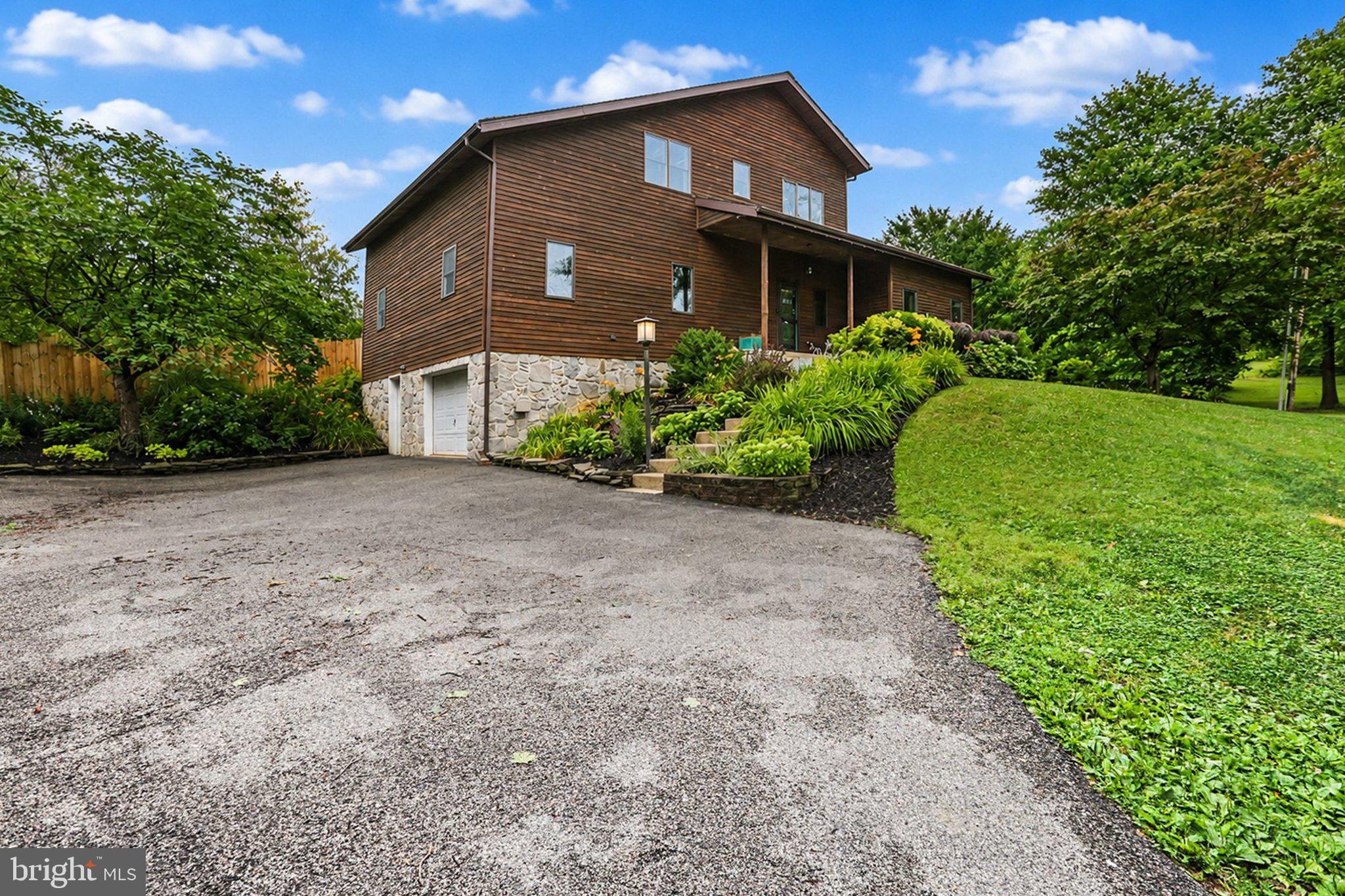 Tucked away in a picturesque 2-acre country setting, this one-of-a-kind two story perfectly balances contemporary comfort with rustic charm. Located just a short walk from State Game Lands and less than a mile from major commuter route US15, this property offers the peaceful lifestyle you've been searching for without sacrificing space or functionality. Step inside to discover a thoughtfully designed floor plan featuring oversized rooms, soaring ceilings, and an abundance of natural light. The expansive living room flows seamlessly into the inviting dining area, complete with a cozy fireplace, custom built-in cabinetry, and ample space to host family gatherings around a large dining table. The recently remodeled kitchen is both beautiful and practical, showcasing bright quartz countertops, generous workspace, and a spacious pantry closet. A substantial two-story addition enhances the home's versatility, creating an additional living area along with a convenient first-floor laundry room and powder room. The main level also features three comfortable bedrooms and a full bathroom, offering the ease of first-floor living. Upstairs, you'll find a welcoming family room, a private primary suite complete with a walk-in closet, and a fifth bedroom, offering space for family, guests, or even a home office. Outside, the property is every bit as impressive. Cool off during the summer in the in-ground saltwater pool or take advantage of the exceptional outbuilding featuring 220-amp electric service, plumbing, a wood stove for heat, two garage bays, and plenty of workshop and storage space—ideal for hobbyists, contractors, or anyone needing extra room for projects and equipment. An additional 2.41 acre lot is also currently available for sale if you are interested in expanding the property! Full of endless possibilities and a setting that embraces the beauty of rural living, this exceptional Dillsburg property offers a rare opportunity to own a truly special place to call home.