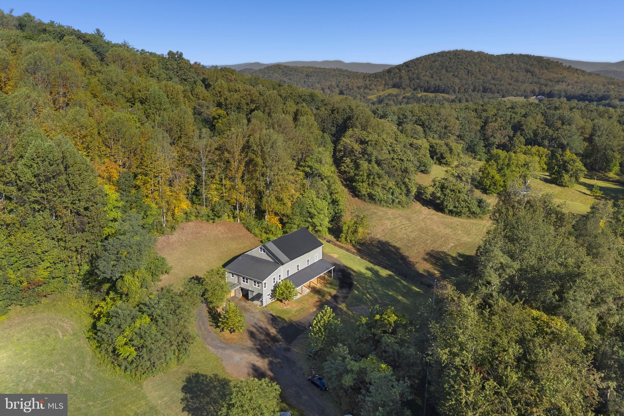 Do you dream of room to roam in the rolling foothills of Rappahannock County? Fox Hill is a dream come true in the heart of Virginia's Piedmont. Verdant pastures undulate and meet lush forest on the flanks of Mason Mountain. Take in the ever-present views of Piedmont hills, Blue Ridge Mountains and your own private, hidden oasis. This sprawling property is 75 acres in two tax map parcels. 🐎 Fox Hill prominently features a stunning 1800s timber frame bank barn, which was rebuilt on site in 2018. Built on a new, poured concrete foundation, the lower floor is a well-appointed horse stable with 8 stalls, wash stall, feed room, and a sunny tack room with a full bath and kitchenette. 🐎 The upper floor has a very comfortable 1-bedroom apartment at its southern end. It is thoughtfully designed with high ceilings and oversized windows to let in the light. There is a bath with heated slate floors, a generous walk-in closet, and details like antique barn wood trim. The structure has Hardiplank siding and a standing-seam metal roof, providing low maintenance and longevity. 🐎 In addition to the apartment, the upper floor of the barn has a breathtaking, 3-story unfinished space. With a striking modern glass wall and door at the entrance, and authentic pegged timber frame construction, possibilities abound. This could be a stunning expansion of the living space, an impressive event venue, or maybe a tasting room for a farm winery or brewery. A septic system for 5 bedrooms is already in place and allows for either building a separate home uphill of the barn, or converting the barn space. 🐎 Fox Hill has 5 separately fenced pastures, a large run-in shed for horses, automatic waterers, and cattle sorting and loading infrastructure. Additionally, there is a machine shop/shed with electricity and a woodstove-heated workspace. The property is in the heart of the Thornton Hill Hounds foxhunting territory and is a short drive to several other hunts. Historic Warrenton and Upperville horse show grounds are each around an hour's drive, as are many other training and show facilities. 🐎 Rappahannock and surrounding counties offer endless recreational possibilities. Nearby Shenandoah National Park is home to scenic Skyline Drive with its overlooks as well as many miles of trails. There are wineries and breweries, great restaurants and cafes, antique stores, farms and orchards, and much more. Looking for cultural activities? Visit one of the many art galleries, attend a play or a concert at one of the theaters, or visit the Rappahannock Historical Society’s museum. 🐎 Near Sperryville and “little” Washington, and convenient to Warrenton and Culpeper, Fox Hill is ideally situated for full-time residents or weekenders alike. Located less than two hours from Washington, DC, and just over an hour from Charlottesville, the property is within an easy driving distance for weekend getaways.