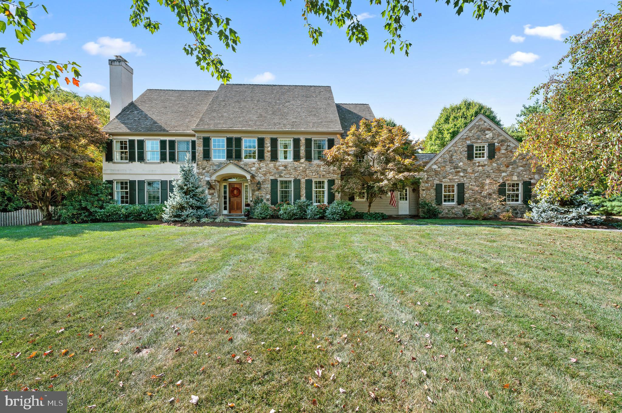 Situated at the end of a serene maple tree-lined driveway, this very special home impresses from every direction, thanks to the extensive improvements and renovations made by the current owners. Discerning buyers will appreciate the high level of craftsmanship, each space thoughtfully designed and professionally executed to create a lifestyle of functional elegance. The style of the two-story foyer is kicked up a notch with floor-to-ceiling wainscoting and a fabulous wood grain light fixture. Handsome random-width hardwood floors begin here and continue throughout the first floor for a seamless look. To the left, the spacious formal living room enjoys lots of natural light and the traditional fireplace provides an inviting space for relaxation. To the right of the foyer, the formal dining room is adorned with pretty blue and white Anthropologie wallpaper accentuated by a contemporary crystal light fixture creating a sophisticated setting for entertaining. The heart of the home is a stunningly executed family room and kitchen area. The sunken family room combines comfort and style, featuring detailed millwork with the coffered ceilings, built-in bookshelves with wood-grain countertops, recessed lighting, and a dramatic and warm stone fireplace. French doors take you to a roof-covered flagstone patio with skylights, ceiling fan, built-in outdoor heater, outdoor speakers, and a stone knee wall offering lots of seating for parties. All of this overlooks the enclosed pool, play area, and gardens. The pool has undergone a gorgeous renovations, is accentuated by professional landscaping, and is enclosed with estate fencing. Beyond the pool are spacious flat grounds, gardens, play spaces, and a tucked-away treehouse providing a magical place for young imaginations to run wild. Back inside, the fabulous gourmet kitchen features white shaker cabinets, Calacatta quartzite counters, and tile backsplash. Enjoy the 5-burner Bosch range, a Bosch dishwasher, Bosch double ovens, and a seamless built-in Thermador refrigerator. The expanded island serves as a striking centerpiece while the spacious breakfast room offers access to a beautiful flagstone patio. The butler’s pantry with a Sub-Zero wine bar, fridge, and glass cabinetry adds to the space’s entertaining-friendly design. To the left of the family room is a private office with glass French doors, a cozy fireplace, built-in bookshelves and workspace, and patio access. Function and style marry perfectly in the double-mudroom space with both flagstone and herringbone tile floors, custom built-in lockers, a well-appointed laundry station with custom cabinetry, folding table, and space to hang clothes. The three-car garage features an epoxy floor, organization system, ample storage, high ceilings, and an exterior door for convenience. An everyday powder room in the mudroom and a formal guest powder room between the living room and office complete the first floor. The second level offers 5 bedrooms and 4 full baths. The luxurious primary suite boasts tray ceilings, hardwood floors, dual closets, and a spa-like bathroom with exceptional finishes. A second floor addition created a stunning bedroom suite with exposed stone, vaulted beam ceilings, a fabulous full bath with spacious glass-enclosed style shower, and a custom walk-in closet tucked behind a pocket door. Completing the second level are three spacious bedrooms including one with a private bath. On the lower level of the home is a beautifully renovated finished basement with a large TV room space including built-in shelving, a separate play area, a guest room or workout space, and another stylish full bathroom. The lower level has outdoor access and a storage/utility room. This home blends timeless elegance with modern luxury and offers a one-of-a-kind living experience for the discerning buyer. Schedule your private showing today to experience the unmatched beauty and quality of this exceptional property.