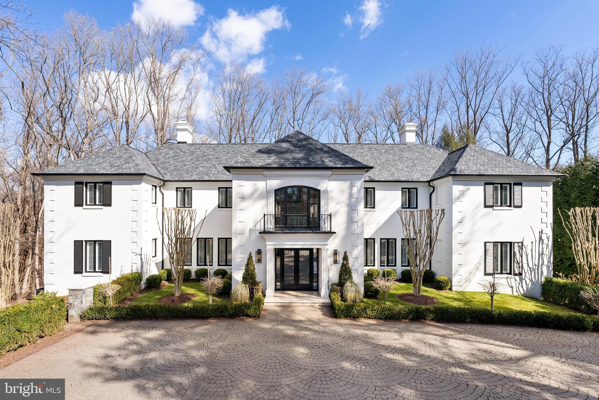Under the careful eye of KNEAD Hospitality + Design, this stately Georgian residence has been transformed into a masterpiece of modern living, where no detail has been overlooked and no expense spared in a top-to-bottom redesign and renovation. Situated on a prime, one-acre site in one of McLean’s most exclusive enclaves, Kedleston now offers a carefree living experience with an unparalleled blend of timeless elegance, contemporary sophistication, and utter privacy.

A cloistered motor court introduces the commanding façade, where articulated quoins, an architectural shingle roof, and new stucco exterior, showcase the home’s traditional pedigree. Grand 8’ custom glass doors open to a soaring two-story foyer, setting the tone for the superbly modern interiors beyond.

The airy two-story living room with handsome stone fireplace extends onto an expansive terrace, overlooking the resort-style pool and the treed privacy of the lot beyond. The dining room, skylit family room, reimagined chef’s kitchen, and lounge offer an effortless flow indoors to out for both intimate gatherings and grand entertaining. A spacious guest suite with fireplace is an unexpected bonus. This floor is completed by two powder rooms, a beautiful walk-in pantry, and the laundry room.

The expanded chef’s kitchen has been meticulously designed for both function and appeal, seamlessly integrating with the skylit family room for an inviting, light-filled atmosphere. A premium Thermador appliance suite elevates the space, featuring a side-by-side refrigerator and freezer, beverage cooler, a six-burner range with griddle and double oven, convection/microwave wall oven, and pot filler, all complemented by Kohler fixtures. Two Neoroc sinks, a custom range hood, and seamless honed Caesarstone countertops with three-sided waterfall edges add to the refined aesthetic. A full-length Caesarstone backsplash, double islands, and a dining bar enhance both functionality and style, while quarter-sawn inset white oak cabinetry offers a timeless, sophisticated touch. For added convenience, an elevator from the garage provides effortless access to the adjacent walk-in pantry.

Upstairs, the serene primary suite is a true sanctuary, anchored by a warm fireplace and designed for the ultimate in luxury and relaxation. The spa-inspired bath boasts a glass-enclosed wet room, featuring a deep-soak Jacuzzi tub with Bask heating technology, a Kohler dual shower system with a rain shower and handheld, and radiant heated floors for year-round comfort. A separate water closet, integrated TV, and floor-to-ceiling wire-brushed marble tile add to the refined ambiance. The suite also offers two boutique-caliber walk-in closets, custom designed for both style and function. Three additional bedrooms and two full baths complete this level, each offering views of the lush, verdant landscape.

The lower level seamlessly extends into an exceptional screened loggia, complete with a fireplace, spa, and multiple lounge and entertaining areas—a true indoor-outdoor retreat. Just beyond, an expansive patio surrounds the heated pool, creating a resort-like oasis. This level is designed for both luxury and functionality, featuring a dual-sized waterfall-edged wet bar built for entertaining, a temperature-controlled wine cellar, exercise studio, and an additional guest suite. A powder room adds convenience, while a private sauna and steam room elevate the wellness experience. For added versatility, a dedicated office space can easily serve as a seventh bedroom. A private entrance provides seamless access for family or staff, leading directly to the elevator and the redesigned three-car garage.

Rarely will you find a residence of this stature, elegance, and meticulous craftsmanship. Kedleston is more than a home—it is a legacy estate. Available fully furnished for the ultimate convenience of its next owner.