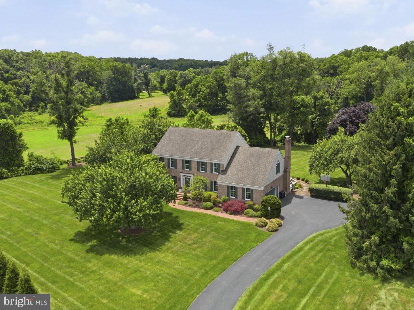 Perched on over 1.5 private acres at the end of a cul-de-sac in sought-after Manor Fields, this custom-built home offers sweeping countryside views and more than 5,200 square feet of beautifully designed living space.  Thoughtfully updated and meticulously maintained, the home showcases soaring ceilings, extensive moldings, hardwood flooring, abundant natural light, and walls of windows that frame the surrounding landscape..

Step inside the grand foyer and immediately appreciate the impressive sightlines that carry through the heart of the home to the picturesque backyard.  Designed for both everyday living and effortless entertaining, the main level features a private office with French doors, formal living and dining rooms, convenient laundry room, powder room, and a sunken family room highlighted by a gas fireplace, built-ins and expansive windows that bring the outdoors in.  Centrally located, the gourmet kitchen offers stainless steel appliances, abundant cabinetry, ample granite countertop space, a spacious dining area, and two breakfast bars.  Custom millwork, thoughtfully designed workspace areas, and elegant built-in china cabinetry elevate the space while providing both beauty and functionality.  The kitchen flows seamlessly into the expansive Florida room with wet bar and skylights, creating a natural extension of the living space.  Whether hosting large holiday gatherings or intimate evenings with friends, the transition from the kitchen, Florida room, and family room to the outdoor living areas is effortless.  The deck, gazebo, and bluestone patio provide exceptional spaces for entertaining while overlooking the scenic grounds, with plenty of room remaining for a future pool, hot tub, fire pit area, or other outdoor amenities.

Upstairs, hardwood flooring continues through the hallway leading to five spacious bedrooms and three beautifully renovated full bathrooms.  The primary suite offers a private retreat, while an additional en-suite bedroom provides an ideal space for guests or extended family.  Generous room sizes, abundant closet space, and thoughtful design create comfort and functionality throughout.

The fully finished walkout lower level offers exceptional flexibility and is filled with natural light from full-size windows overlooking the rear grounds.  Ideal for recreation, fitness, hobbies, or additional entertaining space, this level also features a half bath, large storage room, and workshop area with workbench.

Outside, professionally designed landscaping showcases mature trees, vibrant seasonal blooms, and thoughtfully designed gardens that provide year-round beauty.  An automated watering system helps maintain the lush grounds, while a beautifully integrated pond and cascading waterfall create a serene focal point within the landscape.  Surrounded by privacy and natural beauty, the outdoor spaces have been carefully planned to be enjoyed in every season.

Additional features include central vacuum system, instant hot water at the kitchen sink, abundant storage throughout, and countless upgrades that reflect the pride of ownership found throughout the home.  Ideally located just minutes from Jacksonville, Phoenix, Hunt Valley, Towson, Bel Air, premier golf courses, shopping, dining, and major commuter routes, this exceptional property offers the perfect blend of space, craftsmanship, privacy, and convenience.  This is the ONE you've been waiting for!