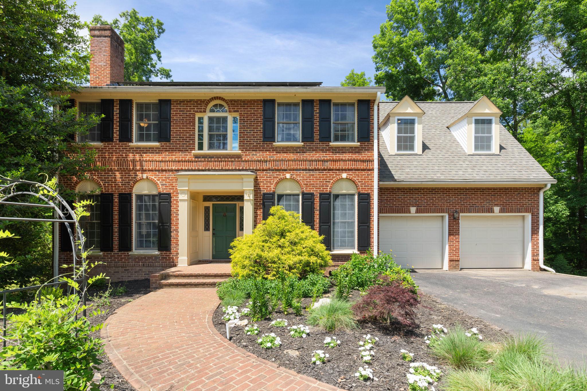 Welcome to 770 Zeuswyn Dr, a stately brick residence set on 5 acres with water views, mature trees, and exceptional indoor-outdoor living. Designed with space, privacy, and everyday comfort in mind, this home offers 5 bedrooms, 5.5 baths, multiple living areas, an attached 2-car garage, lakefront access, and a finished walk-out lower level.

The main level features hardwood floors, classic trim details, and a traditional floor plan with flexible spaces for gathering, entertaining, and quiet retreat. The front living room offers crown molding, recessed lighting, and a wood-burning fireplace with a brick surround and wood mantle. The dining room adds elegance with hardwood floors, crown molding, chair rail, chandelier, and a distinctive mural. Toward the rear of the home, a second living room provides built-in shelving, recessed lighting, and direct access to the deck. The sunroom adds another inviting space with tile flooring, recessed lighting, and a ceiling fan.

The kitchen is well-appointed with black granite counters, gray painted cabinetry, stainless steel appliances, electric cooktop, double wall oven, island, table space, pantry, tile backsplash, bay window, desk area, butler’s pantry, appliance barn, and a door leading to the composite Trex deck. The main-level half bath has been updated and features hardwood flooring, a marble vanity surface, and a white painted wood vanity.

Upstairs, the primary suite offers new hardwood flooring, recessed lighting, a walk-in closet with built-ins, and a private bath with dual sinks, soaking jetted tub, standalone tiled shower, water closet, and picture windows. A second primary suite provides hardwood flooring, skylights, built-in shelving, a walk-in closet with built-ins, and an updated private bath with stone flooring, dual sinks, and a tub/shower combo with tile surround. Two additional upper-level bedrooms each offer hardwood flooring and bath access, giving every bedroom comfortable functionality. The upper-level laundry room includes hardwood floors, washer and dryer, mop sink, extra cabinetry, and a built-in wall ironing board.

The walk-out lower level expands the home with an LVP-finished den/recreation area, built-in shelving, a 5th bedroom with two closets, full bath with standalone shower, and an unfinished workshop/storage room. Outdoor living is a major highlight, with a composite Trex deck, aluminum railings, concrete patio below, storage area, floating dock, kayak rack, and lawn tractor conveyance. With 5 acres, lakefront access, no HOA, and a Culpeper location close to everyday conveniences, this property offers a rare combination of space, privacy, and lifestyle.