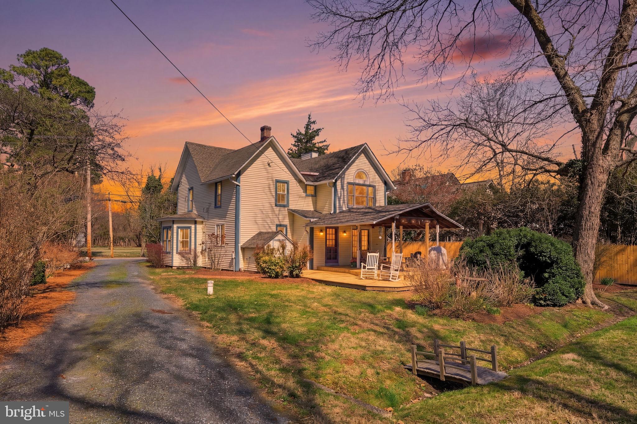 A rare offering in the heart of Royal Oak, this beautifully preserved circa‑1900 Victorian blends timeless architectural character with sophisticated modern updates. Set on a private .60‑acre lot framed by mature trees, the home offers an elegant Eastern Shore lifestyle just moments from world class dining, waterfront charm, and the region’s most beloved destinations. Inside, soaring vaulted ceilings, a sun filled bay window family room and a gracious formal living room with a wood burning fireplace create an inviting sense of warmth. The flexible floorplan includes 4 bedrooms upstairs plus a main‑level room that can serve as a 5th bedroom. The primary suite features hardwood floors and a walk‑in closet, while the additional bedrooms offer new carpet and classic architectural details like a coffered ceiling. The kitchen radiates warmth with its butter‑yellow cabinetry, complementing the home’s original wood staircase, gleaming hardwoods, and carefully preserved period charm. Outdoor living is exceptional with a new sprawling covered deck and new ceiling fan, a refreshed screened porch with new wood floors and a peaceful, backed yard ideal for entertaining or quiet retreat. Extensive upgrades include an architectural roof, new well, public sewer, geothermal heating, electric A/C, new hot water heater, reverse osmosis, vinyl siding, Andersen French Door and a large, floored attic with a full‑size window. Perfectly positioned for enjoying the best of Talbot County—walk to "The Oaks Waterfront Hotel" for fine dining or to the "t at the General Store", a celebrated farm‑to‑table restaurant. Minutes to the Bellevue Ferry for scenic trips to Oxford and the Highland Creamery, and a short drive to Historic St. Michaels and Downtown Easton. A refined blend of history, privacy, and Eastern Shore charm, this is small‑town luxury living at its finest!