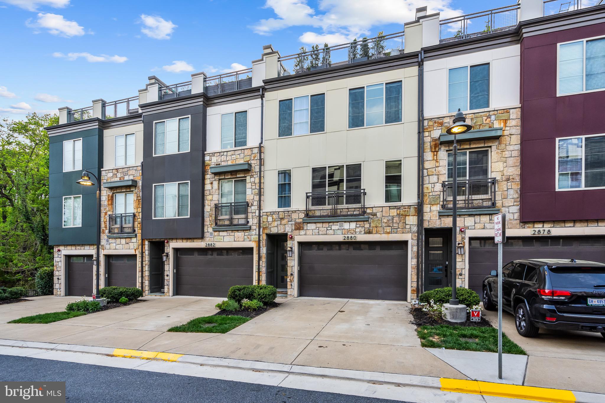 Experience upscale living in this beautifully appointed 4-bedroom, 3 full and 2 half-bath luxury townhome in the heart of Alexandria. Designed for both comfort and elegance, this spacious home offers four thoughtfully designed levels.The main level boasts an open-concept layout with gleaming wood floors, a bright dining area, and a stylish living room—perfect for entertaining. The chef’s kitchen features stainless steel appliances, quartz countertops, a large island, ample storage, a double wall oven, pendant and recessed lighting, and pantry. On the first upper level, you’ll find three generously sized bedrooms, including a luxurious primary suite complete with wood flooring, recessed lighting, and two walk-in closets. The primary bath is a true retreat with a double vanity, soaking tub, and a glass-enclosed shower. The top level includes a fourth bedroom with its own en-suite bath—ideal for guests or a private home office. Step outside to the expansive roof deck with large remote controlled awning, the perfect space to unwind or entertain under the stars. The lower level offers a versatile recreation room and an additional half bath. Enjoy the convenience of a premium Alexandria location with just a quick drive to the Pentagon, Fort Belvoir, and Old Town Alexandria. Nearby parks, dining, and shopping make this the ideal place to call home.