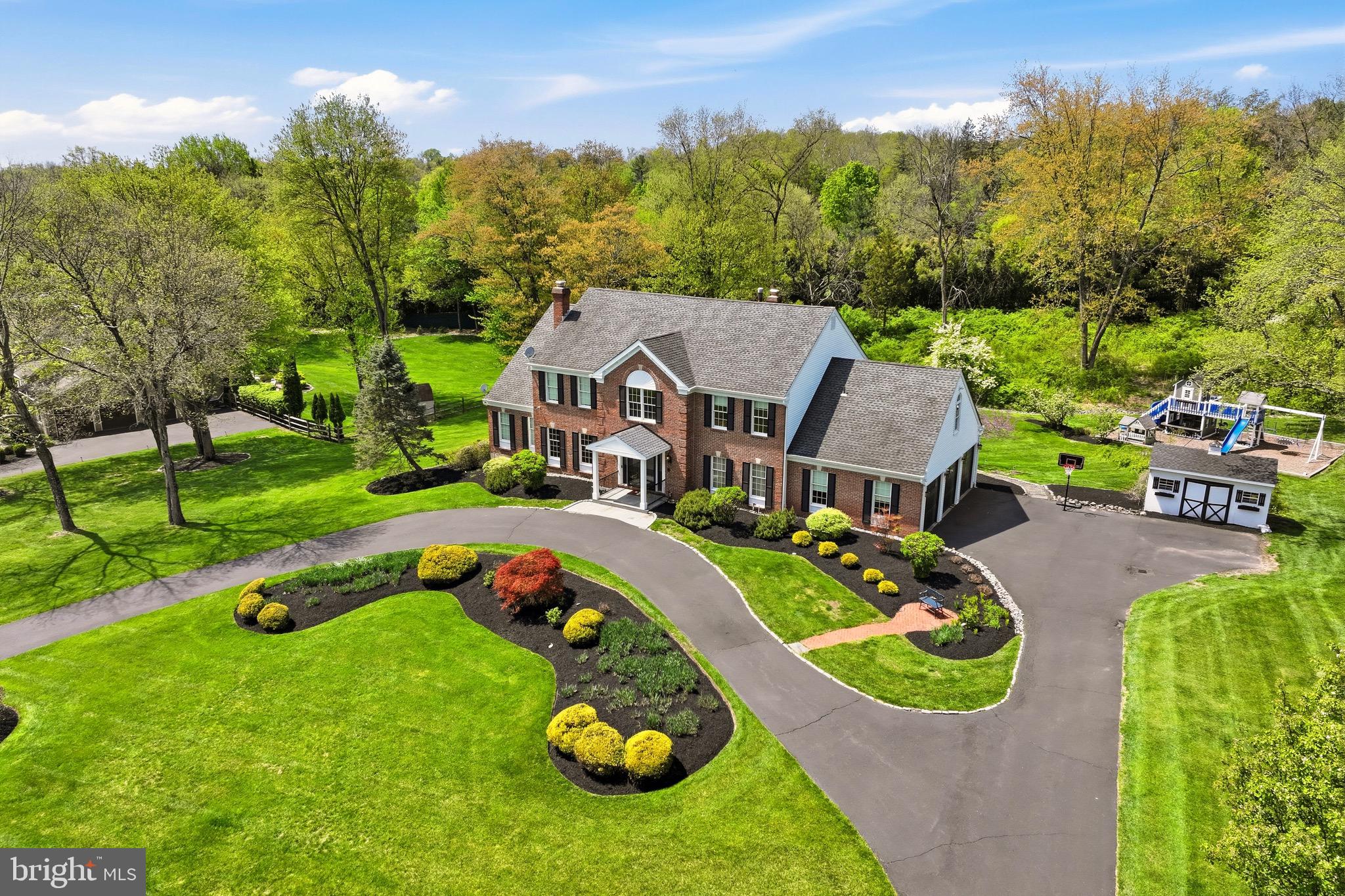 Welcome to 1211 Turnbury Lane, a stately brick colonial tucked away on a beautifully landscaped 1.37-acre lot in the highly sought-after Gwynedd Knoll community in Lower Gwynedd Township. Offering over 6,300 square feet of refined living space, this meticulously maintained home seamlessly blends classic elegance with modern functionality. A long, horseshoe driveway and manicured grounds create a grand first impression, leading to a striking two-story foyer with a dramatic bifurcated staircase, custom millwork, and abundant natural light throughout.
The main level is thoughtfully designed for both everyday living and entertaining, featuring a formal living room with a wood-burning fireplace, an elegant dining room with detailed moldings, and a private office with coffered ceilings and built-ins. At the heart of the home is the chef’s kitchen, complete with an oversized island, custom cabinetry, exotic granite countertops, and premium appliances including a 5-burner induction cooktop and double wall ovens. The kitchen flows seamlessly into the breakfast area and expansive family room with a brick fireplace, all overlooking the serene backyard.
A standout feature of the first floor is the private in-law suite, which includes a full bath with double vanity and a walk-in closet—ideal for guests, extended family, or flexible living needs. Near the 3-car garage (equipped with an upgraded outlet for car charging) is a large mudroom with a utility sink, washer/dryer, and built-ins for added storage.
Upstairs, the luxurious primary suite is a true retreat, featuring dual walk-in closets, a steam shower with dual heads, and a dedicated washer/dryer for ultimate convenience. This suite also offers direct access to a private deck and a workout/bonus space with wall-to-wall mirrors. Four additional generously sized bedrooms include a princess suite with its own bath, while the remaining bedrooms share an updated hall bath with double vanity.
The lifestyle continues in the fully finished lower level, which offers incredible versatility with dedicated areas for a playroom, media space, and recreation. Outside, the 1,200 sq ft elevated composite deck spans the entire rear of the home and is designed for grand-scale entertaining, featuring modern glass railings and a built-in grilling station with granite counters. The expansive backyard offers a private, park-like setting with a custom-built King Swings playground.
Additional highlights include: hardwood floors, custom moldings, volume ceilings, recessed lighting, a 3-zone HVAC, and a detached shed with electricity.
The home is located within the award-winning Wissahickon School District.