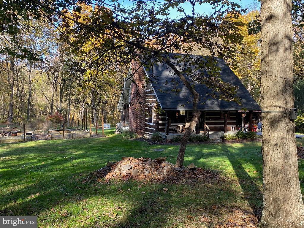 Highest and best due by 5:00 PM February 5th. Get ready for this! This home is a must-see if you're looking for a unique, secluded, rural property with features like a garden, barn, bunkhouse/studio, or all of the above. It's a rare gem on 12.46 acres surrounded by woods, yet it boasts a beautiful yard. The property includes a second dwelling currently used as an art studio—fully heated and air-conditioned, offering versatile possibilities. The main house is a modern log cabin, tastefully done, with the primary bedroom on the second level featuring a private full bath. The main level includes a living room area, dining area, kitchen with an island, a half bath, and a cozy wood stove. The lower level serves as additional living space/ bedroom with an easy-open Murphy bed, another full bath, laundry, and a utility sink. The basement has both an outside entrance and inside stairs. The property also features a barn with upper and lower levels for equipment storage or work shop, a fenced garden area with raised beds for growing vegetables, and a third detached building with parking for two cars, a large tool storage area, and a firewood storage space. This home, located in the historic area of Sharpsburg, is only minutes away from historic Boonsboro, Crystal Grottos Caverns, Antietam Battlefield, Maryland Ag Center, Potomac River, C & O Canal, and Historic Shepherdstown, WV. The Canal and Potomac River are just 1.5 miles away—an easy bike ride. Interstate 70 is a mere 13-minute drive and Interstate 81-10 minutes.  Notably, the property boasts the largest Chinkapin Oak Tree in Maryland. Abundant wildlife including deer and turkey’s surround the property, as seen in the photos.  Check out all the photos and contact your agent or me to set up your showing ASAP. You have to see this place!