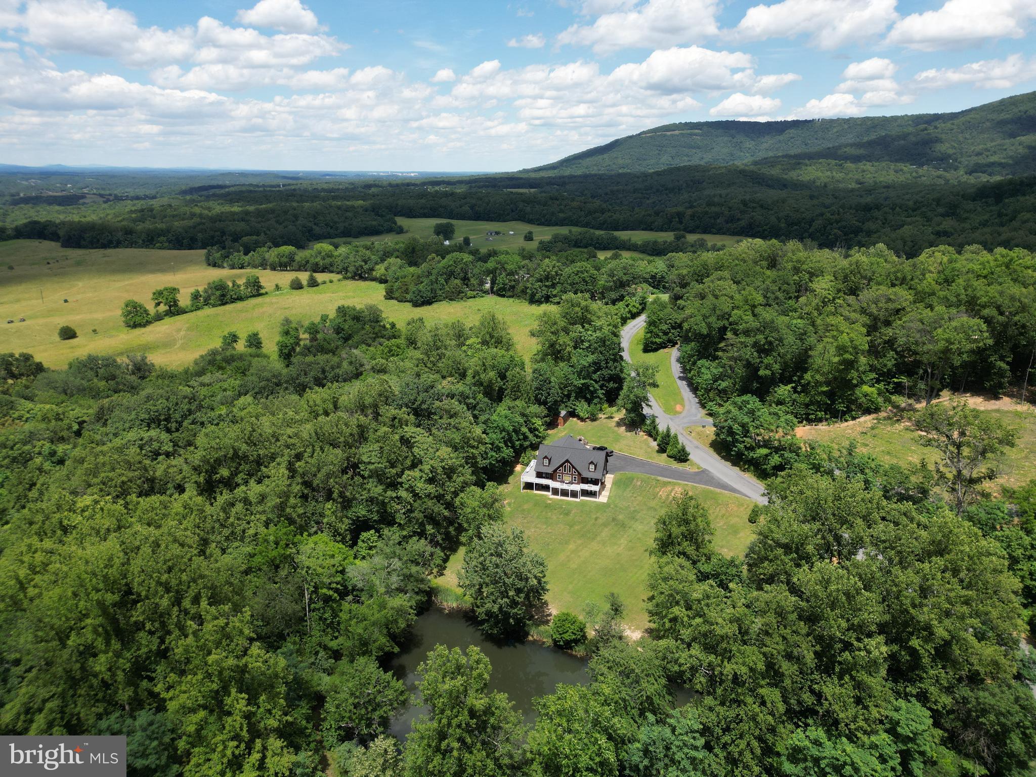 3 ACRES WITH POND, NO HOA, 4-5 BR, 3.5 BA CUSTOM CHALET,MAIN LEVEL LIVING, IN-LAW SUITE, OVERSIZED GARAGE & OVER $130,000 IN RECENT UPDATES!
Accessed by breathtaking Browntown Road and nestled in the shadow of Shenandoah National Park, this custom-built home offers views, privacy, recreation, and luxury. Located just 4 miles from Shenandoah River State Park, 10 minutes from Skyline Drive, and less than 2 miles from Shenandoah River access.  Originally built by a respected local builder as his personal residence, the current owners have invested over $130,000 in recent improvements, creating a home that shows like a model.<br><br>
Situated on 3 acres with a half-acre stocked pond (smallmouth bass and bluegill), the property features over 800 square feet of wraparound decking, nearly 1,000 square feet of concrete patio space, a professionally hardscaped 34x20 stamped concrete patio with retaining walls, built-in outdoor fireplace (w/heat box and slide-in grill), Hot Springs Envoy luxury hot tub ($21,000 addition in 2021), 30+ seller-planted trees, 7 fruit trees, privacy plantings, level parking for 10+ vehicles, archery and frisbee golf areas, sledding/waterslide hill, storage building, and abundant wildlife.<br><br>
The vaulted great room features a tongue-and-groove ceiling, floor-to-ceiling stone fireplace, and wall of windows overlooking the pond. The updated kitchen (2020) offers Super White granite countertops, tile backsplash, under-cabinet lighting, bar seating, range hood, and upgraded LG appliances (including InstaView refrigerator). The main-level owner's suite includes deck access, pond views, cedar walk-in closet with custom shelving, custom stone headboard, and a beautifully renovated bathroom completed in June 2026. Upstairs offers a loft office overlooking the great room and pond, two spacious bedrooms (both with double closets and access to floored attic storage), and a full bath.<br><br>
The finished walkout lower level includes a wet bar with granite countertops, tile backsplash and beverage refrigerator, recreation room, 16x12 media room/4th bedroom (75" TV and surround sound convey), full tiled bath, 13x12 fitness area, office/craft room with potential for a 5th bedroom, utility room, and multiple pond-view patio access points. The main level 725 sq ft garage features elongated doors, high ceilings, windows, built-in workbench and cabinetry, dual 220-volt power drops, and two additional exterior exits.<br><br>
Recent improvements include: New Roof (2025 - $26,000), Trex Deck (2025 - $27,000), Dual-Zoned HVAC Upgrades (2023 - $12,000+), Hot Tub Installation (2021 - $21,000), Kitchen Renovation (2020 - $11,000), New Main-Level LVP Flooring (2023 - $6,000),Finished Basement (2020), Paved Driveway (2019), Storage Building (2019), Electric Vehicle Charger (2025), New Carpet (2024) and $4k+ in Tree Plantings.<br><br>
Additional features include a whole-house automatic generator connected to an owned 500-gallon propane tank (serviced annually, self-tested weekly), Culligan water softener, hardwired security system, custom blinds, high-speed internet, excellent cell service, hardwood flooring beneath the main-level LVP, and meticulous maintenance records.<br><br>
A rare opportunity to own a private Shenandoah Valley retreat with exceptional upgrades, recreational amenities, and a setting that is truly second to none. Ask your agent for the extensive property information sheet available in the MLS documents section. POSSIBLE VACATION HOME RENTAL!