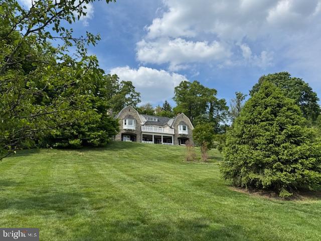 Timeless Elegance Meets Modern Luxury in This One-of-a-Kind Colonial Estate. Perched high above the scenic landscape of Rydal on over 2 acres of beautifully manicured grounds, this fully renovated stone Colonial is the perfect blend of old-world charm and contemporary sophistication. Boasting 5 spacious bedrooms, 3.5 luxurious baths, and over 5,000 square feet of meticulously designed living space, this move-in-ready masterpiece offers unmatched craftsmanship and attention to detail throughout.Step inside through the private drive and into the grand, sunlit foyer where an oversized brick fireplace and a dramatic turned staircase immediately set the tone for what’s to come. The original hardwood floors, solid wood doors, and pocket doors throughout the home echo its rich history, while custom woodwork, oversized doorways, and radiant heated floors provide warmth and elegance. The chef’s dream kitchen is the heart of the home, featuring Thermador appliances, quartz countertops, a marble backsplash, a walk-in pantry, radiant flooring, and an expansive island perfect for entertaining. Adjacent to the kitchen, the light-filled breakfast room and curved study—with a renovated powder room—offer stylish and functional spaces for everyday living. Formal living and dining rooms are equally striking, both showcasing wood-burning fireplaces, custom moldings, and built-ins. Two sets of glass doors in the dining room open to a stunning heated sunroom surrounded by windows, which flows seamlessly to an expansive covered patio with spectacular views—ideal for indoor/outdoor entertaining year-round. Upstairs, the primary suite is a serene retreat complete with his-and-hers built-in closets, crown molding, and a spa-like en suite bathroom featuring an oversized frameless walk-in shower, double quartz vanity, radiant floors, and a dramatic ceiling-mounted waterfall faucet over a soaking tub. Additional bedrooms and renovated full baths line the hallway, and the upper-level laundry room adds convenience. The finished third floor offers versatility as an additional bedroom, home gym, or private office. Outside, a three-car detached garage sits within a charming courtyard, while the new Lennox forced-air heating and cooling system, CertainTeed 50-year roof, security system, and other state-of-the-art mechanical upgrades ensure peace of mind and comfort for years to come. Located just minutes from transportation, shopping, restaurants, top-rated schools, and local parks, this home is a rare find that must be seen to be appreciated. Experience refined living where history meets modern luxury