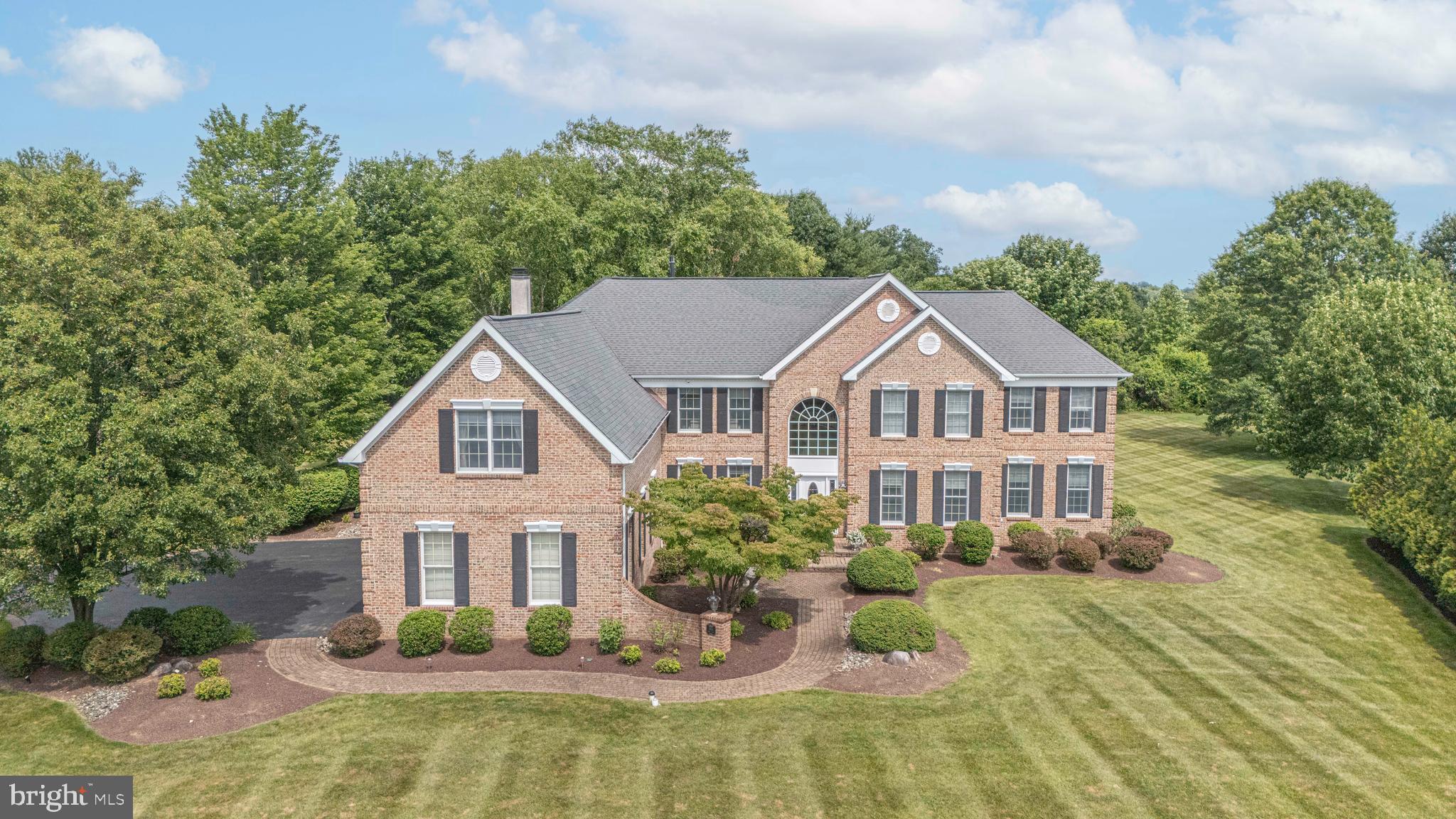 Welcome to 1901 Park Drive, one of the premier lots in Dolington Estates, backing directly to 64 protected acres of township-owned Memorial Park. This Toll Brothers Savoy offers nearly 7350  square feet of finished living space, five ensuite bedroom suites, and a setting in Pennsbury School District that guarantees privacy no future development can take away — no rear neighbors, ever.

A dramatic two-story foyer flooded with natural light welcomes you in, anchored by a sweeping curved staircase. The heart of the home is the soaring two-story family room, where a wall of windows fills the space with light, flowing seamlessly into the gourmet kitchen with large center island, walk-in chef's pantry, and casual dining area. Just beyond, the light-filled sunroom overlooks the expansive backyard lawn, terraced patio, and tranquil pond with waterfall. A spacious private study makes an ideal home office, while the formal dining room and drawing room provide elegant spaces for entertaining.

Every one of the five bedrooms is a true suite with its own private ensuite bath — a standard almost never found at any price — and four of the five include their own private sitting room, giving each family member a genuine personal retreat. The first-floor suite is exceptional: a generously sized bedroom with its own sitting room and full bath, perfect as an in-law or multigenerational suite, or even as a gracious main-level alternative to the primary bedroom. Upstairs, the primary suite features a large spa-style bath and true his-and-hers walk-in closets — two separate, deep walk-ins, one for each of you.

The 1,944-square-foot finished lower level is built for entertaining: a complete custom wood bar, a game room with pool table, table tennis, foosball, and air hockey (available at the buyer's option), a dedicated media room, and a private gym.

A three-car garage with generous storage, a quiet dead-end street just five minutes from I-295, and the boutique shopping, restaurants, and community events of Yardley and Newtown boroughs minutes away complete the picture. Beyond the mature tree line: direct access to Memorial Park's walking trails, open fields, playground, basketball, pickleball, and sand volleyball courts, and the serene Garden of Reflection. Newer roof; three-zone natural gas heat and central air with two HVAC units replaced in 2023.  Be sure to see all Floor Plans included in Photos.

Homes of this size, layout, and setting rarely come to market in Lower Makefield — schedule your private showing.
