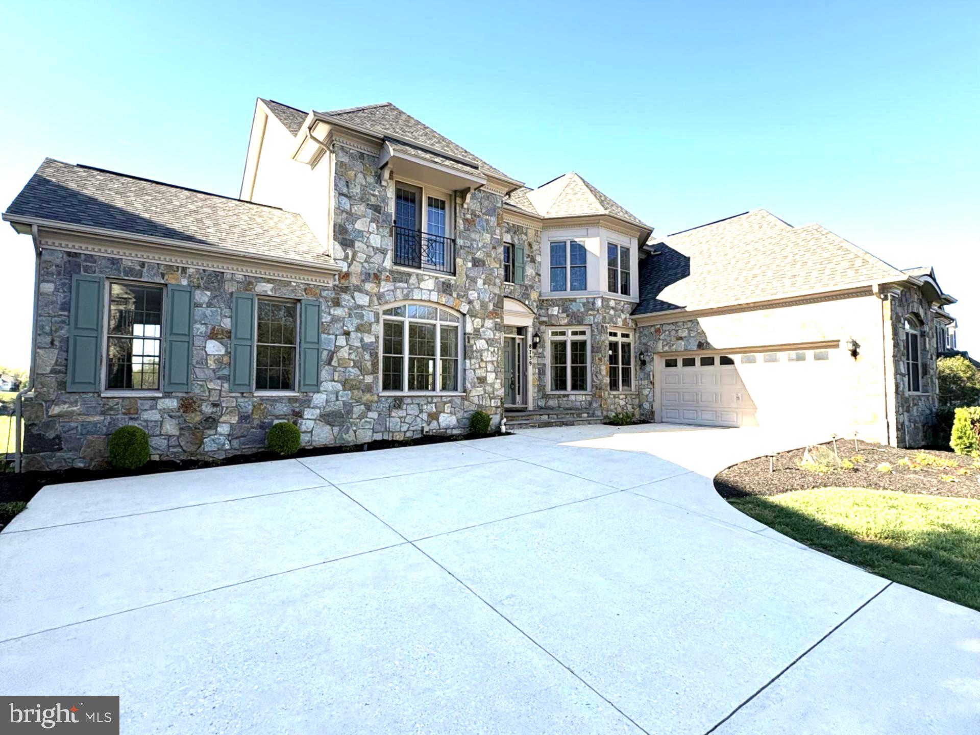 Exquisite Stone front single family house with dramatic Victorian architectural style turret and roof line.  All  bells and whistles that one would expect in such a dream house.
This house feature's 6,600+ finished square foot with a total of 7 bedrooms and 6 Bathrooms. 4 bedrooms and 3 bathrooms on upper floor, 1 bedroom, 1 bath on the main level and 2 bedrooms, 2  full bathroom on lower level.  This house is located within the prestigious gated Stone Lake community in Howard County.  This house is thoughtfully designed with open floor contemporary concept with generous living spaces.  Special emphasis is given while designing to have lake view from as many living areas as possible.  The main level has walls of windows bringing in abundant natural light.  Gleaming hardwood floors, elegant crown molding and refined architectural details.  Spacious Living room opens in to solarium with lake view.  Formal dining room with wainscoting, chair rail and 2 spaces for curio.  Uniquely designed Family room with walls of windows for a very picturesque lake view.  Family room ceiling has dramatic trim ceiling and crown molding.  Gourmet kitchen with a large center island, gas cooktop, ovens-microwave combo, state of the art refrigerator with television/internet screen, oversized pantry, and a built-in desk.  The breakfast area overlooks the lake and opens seamlessly on to a low maintenance deck which is perfect for relaxing and entertaining.  Completing the main level is a main level office/bedroom with attached full bathroom.  Upstairs the expansive Master bedroom overlooks the lake with access to upper level deck.  M Bedroom offers a vaulted ceilings, sitting area, contemporary finishing behind the bed, big walk-in closet with custom cabinets and a luxurious spa-style bath with dual granite vanities, soaking tub, shower with river bed stone flooring  and private water closet.  Laundry room is attached to master bedroom for conveniency.  Large 2nd Bedroom overlooking the lake and with attached bathroom.  Two additional generously sized bedrooms on upper floor.  Basement is fully finished and walk-up level with large recreation room, home theatre, spacious bedroom, upgraded full bath, and ample storage.  Fresh paint and new carpeting make this home completely turnkey.  
In 2017 major interior renovation was done to add contemporary interior look.  This included replacing existing stairs with contemporary steel stairs and tension wires for railing.  New contemporary looking  wet bar with dishwasher, wine refrigerator and under counter refrigerator.  Open home theatre with star light effect created by fiber optic cable tips in tray ceiling, theatre style step seating,  120 inches wide black diamond zero edge screen and Epson projector with anamorphic lens, 9 surround sound dolby atmos martin logan speaker system, pioneer receiver, harmony remote control with scene automation to turn the lights on/off when watching movie. 
Exercise/gym & 2 bedroom with 2 full bathroom and a steam room in the basement.
Two level low maintenance deck overlooking the lake and the Northern sky.
Features added during the major renovation in 2017 were: Nest doorbell, Nest Smart Thermostat on main level and upstairs, Samsung Smart Fridge, Samsung Smart Cooktop, Samsung Washer& Dryer with additional sidekick pedestal washer and pedestal for dryer.  Sonos in ceiling Speaker System in the basement and pre-wired for speakers in the Family rm.  Two (2) Tesla charging stations in the Garage, Lift Master Automated Garage Door opener.
Highly sought-after Stone Lake community with 24 hours security.  8739 Weathered Stone Way offers a true lifestyle with access to a soothing 25-acre lake, private beach, boathouse, stocked fishing, boat slips, walking/jogging trails, tennis, pickleball & basketball courts, putting green, tot lot and a lakeside pavilion available for private events. Lawn care and snow removal are included allowing luxurious lifestyle and resort-style living.